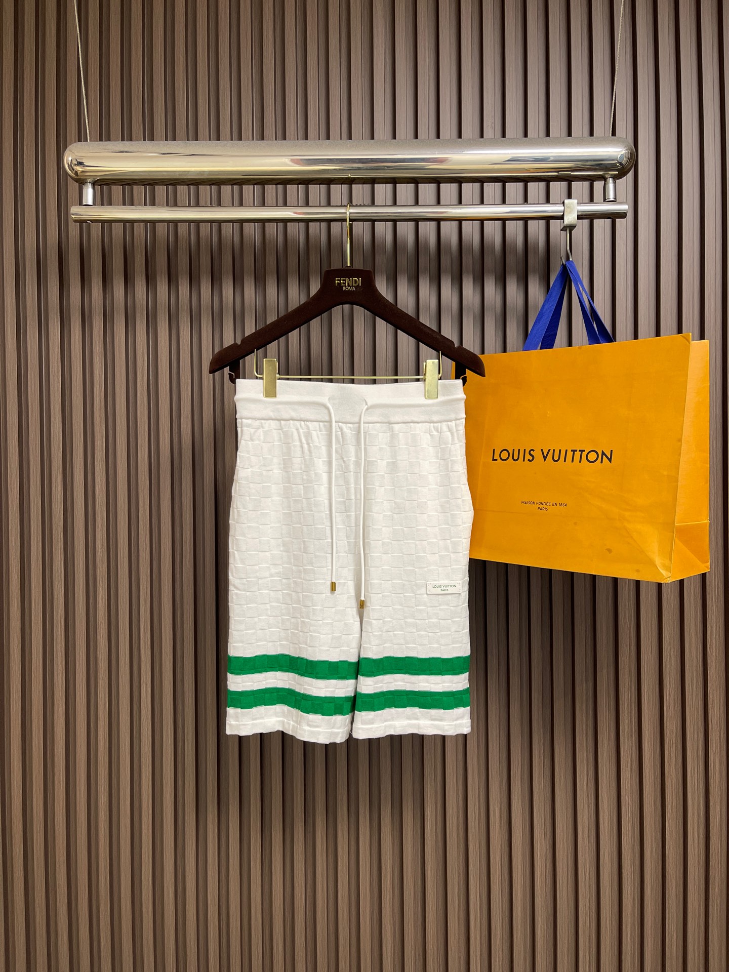 NO:845168,LV  The letter badge piping checkerboard jacquard knitted shorts are made of high-quality knitted fabrics, which are soft and skin-friendly, breathable and comfortable, and have a good drape. The pants are made of classic checker jacquard technology, with a clear and three-dimensional texture, and are paired with contrasting stripe piping designs on the sides. The details are exquisite and eye-catching, and the brand logo is low-key to highlight the style. The drawstring waistband is equipped with metal rope ends, which are easy to put on and take off, fit the waist, and have a loose and comfortable fit.  Fall, modify the leg shape without being tight. The overall routing is smooth and fine, the seams are strong and durable, and not easy to deform and pill. Multiple colors are available to suit a variety of wearing scenarios, easily creating a casual and high-end feel. It is recommended to use 30-40 degree warm water to gently hand wash, avoid violent rubbing, bleaching and sun exposure, and extend the service life of the fabric. The overall routing is straight and delicate, the fabric is comfortable and soft, and the color is consistent without color difference.  It can be matched with the same style to create a fashionable look, and can be used in various occasions. Customized accessories, complete with three standards, same style for men and women!  Size S-XL S size pants length 51 waist size 66 medium size pants length 52 waist size 70 L size pants length 53 waist size 74 XL size pants length 54 waist size 78,,louis vuitton,shorts,19860909LV 字母徽章滚边棋格提花针织短裤,甄选优质针织面料打造,触感柔软亲肤,透气舒适兼具良好垂坠感.裤身采用经典棋格提花工艺,纹理清晰立体,搭配侧边撞色条纹滚边设计,细节精致亮眼,品牌标识低调彰显格调.抽绳腰头搭配金属绳头,穿脱便捷且贴合腰身,版型宽松利落,修饰腿型不紧绷.整体走线平整细密,锁边牢固耐穿,不易变形起球,多色可选适配多种穿搭场景,轻松打造休闲高级感.洗涤建议选用30-40度温水轻柔手洗,避免暴力揉搓、漂白及阳光暴晒,延长面料使用寿命.整体走线平直细腻,面料舒适柔软,颜色一致无色差 能与同款搭配营造时尚造型,驾驭各种场合,定制辅料,三标齐全,男女同款！ 尺码S-XL S码 裤长51 腰围66 M码裤长52 腰围70  L码 裤长53 腰围74 XL码裤长54 腰围78,,louis vuitton,shorts,,Men's clothing