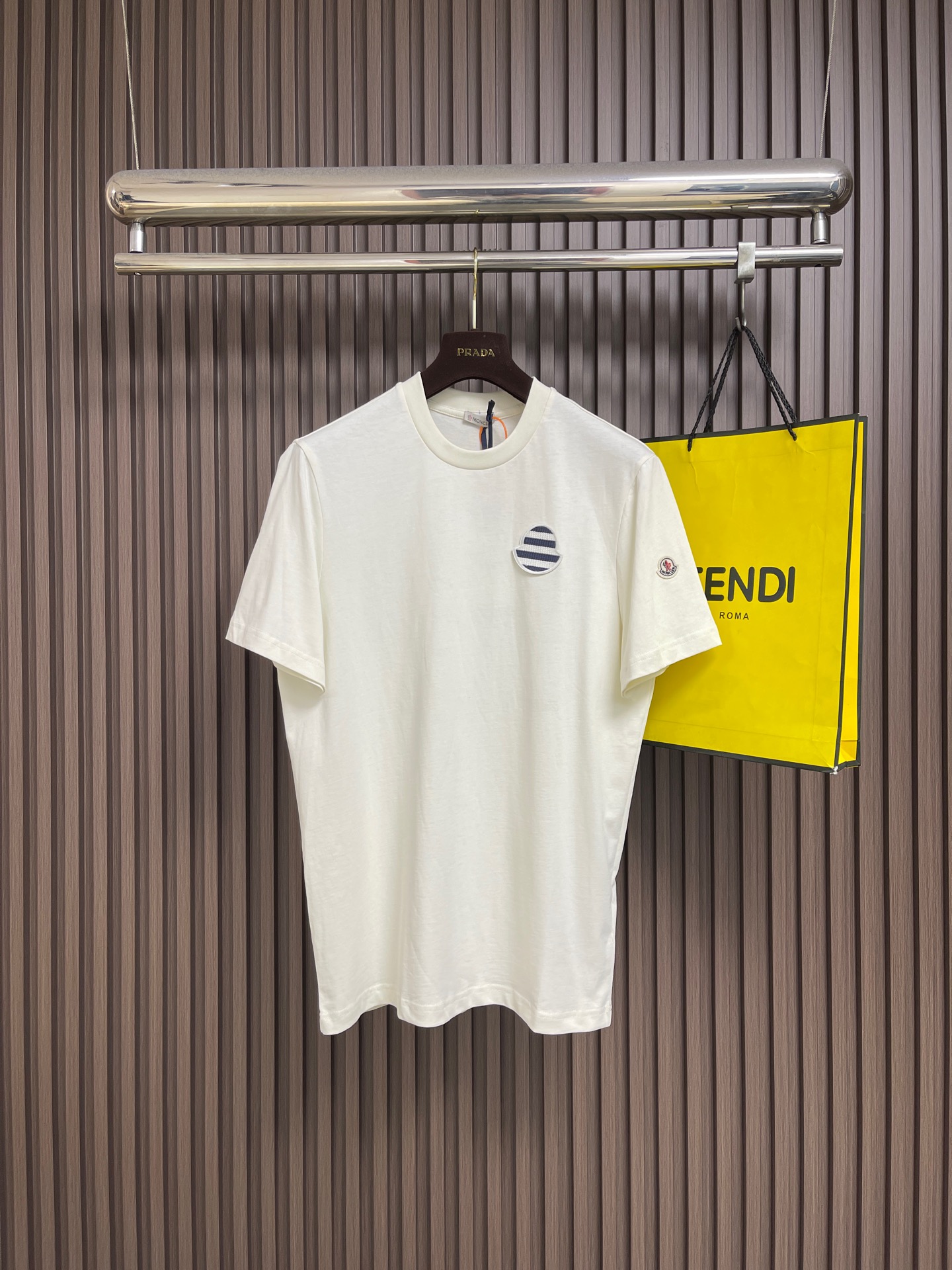 NO:845160,moncler striped logo patch short-sleeved T-shirt, custom-made matte combed plain cotton, nautical stripe patch on the chest like a deep-sea navigation mark, and the same color logo patch on the left sleeve as a secret code of identity. The two echo tacitly in the simple silhouette, hiding Italian elegance and nautical legends in the details, low-key but sharp. Imported machine embroidery technology, advanced computer control system and precision mechanical components are used to realize the Moc logo patch work. Sizes S-XL S size bust 104  Shoulder width 42.5, length 71, size M, bust 108, shoulder width 44, length 73, size L, bust 112, width 45.5, length 75, size XL, bust 116, width 47, length 77, T-shirt, tees, t-shirt,19860909moncler 条纹标识贴片短袖T恤,定制雾感精梳平纹棉,胸间航海条纹贴片如深海航标,左袖同色标识贴片为身份暗语,二者于简约廓形中默契呼应,将意式奢雅与航海传奇藏于细节,低调却锋芒毕露.采用进口机刺绣工艺,使用先进的计算机控制系统和精密的机械部件,实现Moc标识贴片工作.尺码S-XL S码胸围104 肩宽42.5 衣长71 M码 胸围108 肩宽44 衣长73 L码胸围112肩宽45.5 衣长75 XL码 胸围116肩宽47 衣长77,,T-shirt,tees，t-shirt,,Men's clothing