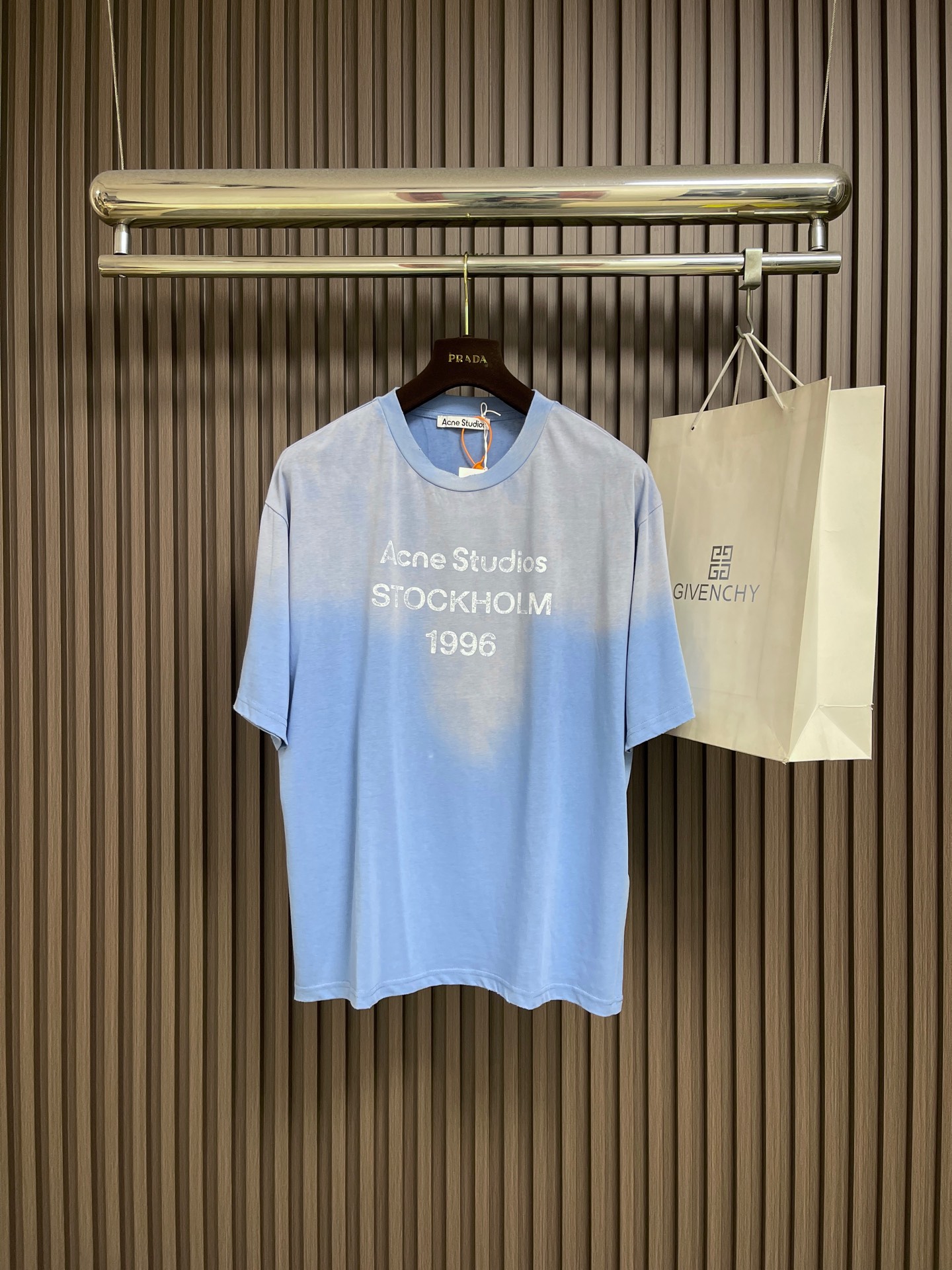 NO:847368,ACNE STUDIOS spray-painted distressed logo short-sleeved T-shirt, custom cloud velvet ski-like cotton, a touch of glacier blue quietly blooming, Ac  The 1996 logo pattern is embellished on the chest. The uneven depth of the letter strokes is like the mark engraved by the years. It is sublimated by the imperfection of the old inkjet printing, forming a visual collision of softness and rigidity. Glue printing is used. The chest printing has been modified by the film screen three times. Glue liquid paint is used on the fabric.  Print the pattern and bake the fabric to fix the printed pattern. Gradient distressing spray process, by spraying dyes of different colors on the surface of the fabric, the clothes can show rich color changes under different lights and increase the visual layering. Many places on the body of the clothing are worn by pure manual regular positioning and hand brush marks  Add texture and depth to the surface of clothing to imitate the texture of natural wear. Sizes S-XL S size bust 112 shoulder width 51.5 length 68 M size chest 116 shoulder width 53 length 70 L size chest size 120 shoulder width 55.5 length 72 XL size bust 124 shoulder width 56 length 74,,acne studios,dior,T-shirt,tees,t-shirt,19860909ACNE STUDIOS 喷绘做旧徽标短袖T恤,定制云绒爽滑雪感棉,一抹冰川蓝悄然绽放,Ac 1996徽标图案点缀于胸前,字母笔触的深浅不均,宛如岁月镌刻的印记,加以喷绘做旧的不完美感为升华,形成柔与刚的视觉碰撞.采用胶浆印花,胸前印花经过三次菲林网板修改.使用胶浆液体涂料在织物上打印图案,烘烤织物以固定印刷图案.渐变做旧喷马骝工艺,通过在织物表面喷洒不同颜色的染料,实现衣物在不同光线下呈现出丰富的色彩变化,增加视觉层次感.衣身多处皆由纯人工规律性定位磨破,手工刷痕 在衣物表面增加纹理和深度感,以模仿自然磨损的质感.尺码S-XL S码胸围112 肩宽51.5 衣长68 M码 胸围116 肩宽53衣长70 L码胸围120 肩宽55.5衣长72 XL码 胸围124 肩宽56衣长74,,acne studios,dior,T-shirt,tees，t-shirt,,Men's clothing