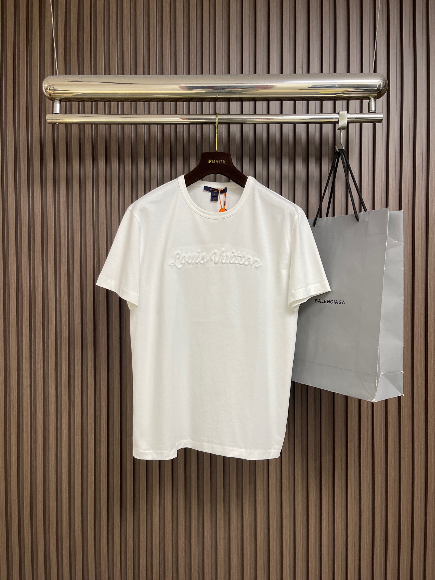 NO:847364,LV  The three-dimensional wave letter short-sleeved T-shirt is made of 15-count special-spun compact cotton with 32-count 1x1 rib. The 15-count yarn is thicker, with strong texture and crisp texture. The cotton fiber is mercerized to enhance the gloss and smoothness, and the background color is full and even. It is then shaped and stretched at high temperature to eliminate wrinkles and internal stress. The 32-count rib collar retracts to the best elastic state and fits well. The handwritten logo on the chest  Three-dimensional core-spun embroidery is used, with core cotton as the base, and the outer layer of embroidery thread is tightly wrapped, giving the letters a rounded and raised three-dimensional effect. The thick-line outline lock edge is reinforced along with the letter outline to strengthen the border clarity and enhance the visual hierarchy. Box-shaped straight cut, precise shoulder line, H-shaped straight body, square and neat outline, and the right-angled outline is maintained after multiple washes. Customized accessories, complete with three standards, the original version is developed only to restore!  Size S-XL S size bust 106 shoulder width 47 length 68 M size bust 110 shoulder width 49 length 69.5 L size bust 114 shoulder width 51 length 7119860909LV 立体浪花字母短袖T恤,采用15支特纺紧密棉,搭配32支1x1罗纹.15支纱线较粗,肌理感强,质地挺括.棉纤维经丝光处理,光泽度与平滑感增强,底色饱满匀净.后经高温定型拉幅,消除褶皱与内应力.32支罗纹领口回缩至最佳弹性状态,贴合不勒.胸前手写体标识采用立体包芯刺绣,以芯棉为底,外层绣线紧密包裹,字母呈圆润隆起立体效果.粗线廓形锁边沿字母轮廓加固,强化边界清晰度,增强视觉层次.箱型直身剪裁,肩线精准,衣身呈H型直筒,轮廓方正利落,多次洗涤后保持直角轮廓感.定制辅料,三标齐全,原版开发只为还原！尺码S-XL S码胸围106 肩宽47 衣长68 M码 胸围110肩宽49 衣长69.5 L码胸围114肩宽51 衣长71 XL码 胸围118肩宽53 衣长72.5,,louis vuitton,T-shirt,tees，t-shirt,,Men's clothing