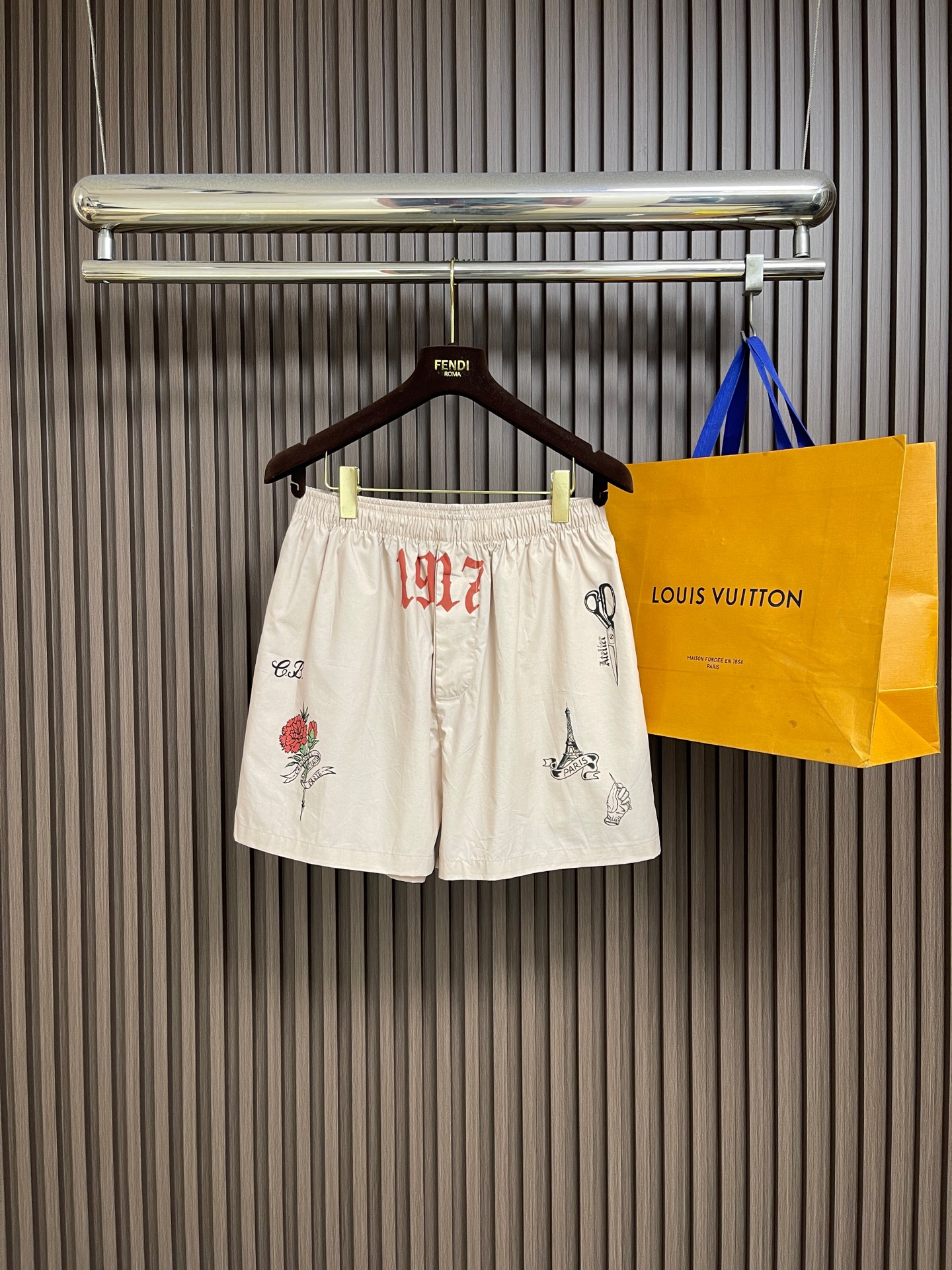 NO:847354,Tops shorts P balenciaga  Retro graffiti printed short-sleeved shirt and shorts set, made of customized high-count double-ply poplin fabric, which has undergone multiple pre-shrinking and anti-wrinkle processes. The texture is light and smooth, soft to the touch and skin-friendly. It has excellent breathability, moisture absorption and anti-wrinkle drape properties. It is not easy to wrinkle and deform after long-term wear, and the upper body is refreshing and comfortable;  The classic lapel design, with precision hemming technology on the edges, neat and smooth lines, stiff and stylish, not easy to collapse, fits the neck line, creating a neat and casual silhouette; the entire body of the garment adopts retro tattoo-style graffiti printing technology, inspired by elements such as roses, Eiffel Tower, scissors, letters and numbers, etc.  Restore the brand's iconic street retro aesthetics, the printing colors are bright and clear, and the details are rich and delicate, breaking the monotony of solid colors, with both recognition and artistic tension; the placket uses resin buttons of the same color, which are smooth and durable in opening and closing, and the details highlight the brand's ingenuity; the overall tailoring is loose and neat, both casual and casual  Sexy and street trendy, it doesn't matter your body shape, and can easily adapt to a variety of dressing scenes. Whether it is for daily outings or vacations, you can easily create a retro trendy look. Sizes S-XL, balenciaga, shorts, shirts, T-shirt,19860909上衣 短裤P balenciaga 复古涂鸦印花短袖衬衫短裤套装,采用定制高支双股府绸面料,经过多道预缩与抗皱工艺处理,质地轻薄顺滑,触感柔软亲肤,兼具优异的透气性、吸湿性与抗皱垂坠性能,久穿不易起皱变形,上身清爽舒适；经典翻领设计,边缘采用精密包边工艺,走线工整流畅,挺括有型不易塌软,贴合颈部线条,打造利落随性的廓形；衣身通体采用复古纹身风涂鸦印花工艺,以玫瑰、埃菲尔铁塔、剪刀、字母数字等元素为灵感,还原品牌标志性的街头复古美学,印花色彩鲜亮清晰,细节丰富细腻,打破纯色单调感,兼具辨识度与艺术张力；门襟采用同色系树脂纽扣,开合顺滑耐用,细节处彰显品牌匠心；整体剪裁宽松利落,兼具休闲随性与街头潮流感,不挑身材,轻松适配多种穿搭场景,无论是日常出街还是度假休闲,都能轻松打造复古潮流的造型.尺码S-XL,,balenciaga,shorts,shirts,T-shirt,,Men's clothing