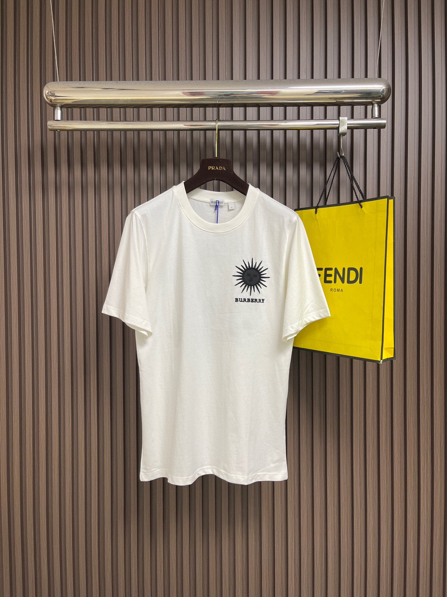 NO:847346,Burberry  The round neck short-sleeved T-shirt with letter sun embroidery is made of specially selected high-count combed cotton fabrics from the brand. It is made of double-strand yarn weaving process to present a delicate and soft skin-friendly texture. It has excellent moisture absorption and breathability and drape and wrinkle resistance. The upper body is light and comfortable, and it is not easy to deform and pill after being washed for a long time. The neckline adopts a round-neck design, and the collar edge is processed by double-thread seaming and reinforcement processes. The threading is smooth and firm, and it can be worn and washed repeatedly.  It is not easy to loose and deform; the front left chest is decorated with the brand's iconic sun pattern embroidery, which is made with high-density embroidery thread technology. The stitches are fine and neat, and the pattern lines are clear and three-dimensional. It is matched with the embroidery of BURBERRY letters below to low-key highlight the brand recognition; the cuffs and hem are made of flat seaming technology, the lines are even and smooth, and the details show the brand's exquisite craftsmanship. Size S-XL  S size bust 102 shoulder width 46 length 73 medium size bust 106 shoulder width 47 length 74.5 L size bust 110 shoulder width 48.5 length 76 XL size bust 114 shoulder width 49 length 77.5, burberry, T-shirt, tees, t-shirt,19860909Burberry 字母太阳刺绣圆领短袖T恤,甄选品牌特供高支精梳棉面料,经过双股纱线织造工艺,呈现出细腻柔软的亲肤质感,兼具优异的吸湿透气性与垂坠抗皱性,上身轻盈舒适,久洗不易变形起球；领口采用圆领设计,领边经过双线锁边与加固工艺处理,走线平整牢固,反复穿着洗涤也不易松垮变形；衣身正面左胸位置饰有品牌标志性太阳图案刺绣,采用高密绣线工艺打造,针脚细密工整,图案线条清晰立体,搭配下方的BURBERRY字母刺绣,低调彰显品牌辨识度；袖口与下摆均采用平整锁边工艺,走线均匀流畅,细节处尽显品牌精湛工艺.尺码S-XL S码 胸围102 肩宽46 衣长73 M码胸围106 肩宽47衣长74.5 L码 胸围110肩宽48.5衣长76 XL码胸围114肩宽49衣长77.5,,burberry,T-shirt,tees，t-shirt,,Men's clothing
