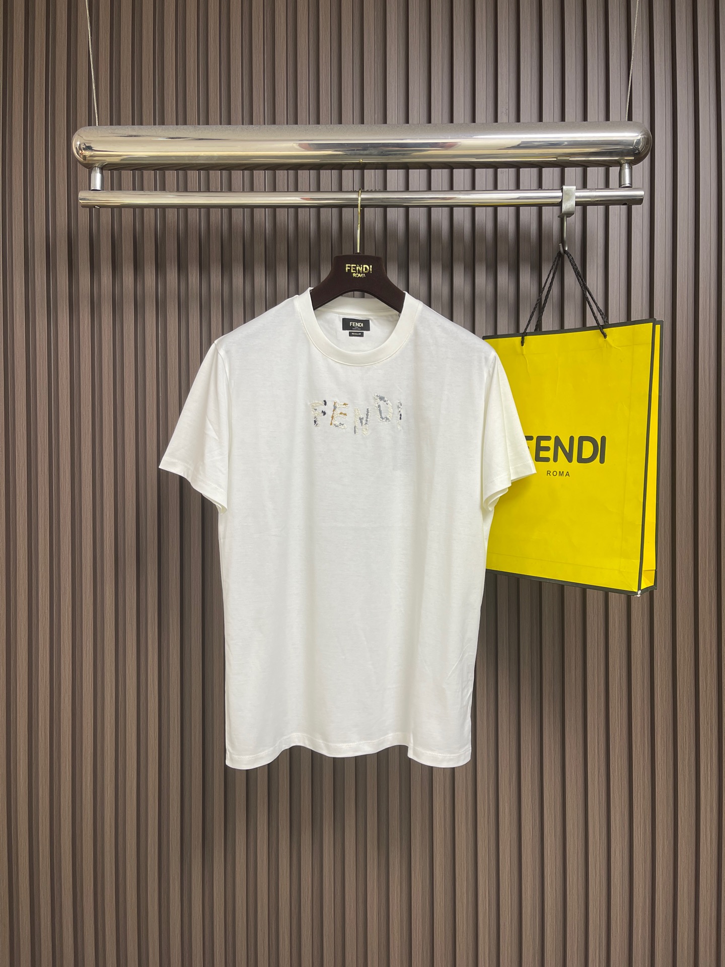 NO:848722,Fendi  The miscellaneous yarn embroidered round neck short-sleeved T-shirt uses 50-count double-ply mercerized cotton, 165gm, with 32-count double yarn, 300gm ribbing. The 50-count is a high-fine yarn count, and the yarn diameter is extremely fine; it has reached the level of a high-end shirt.  Smoothness standard. Double strands are made from two single yarns and twisted into one yarn. This process achieves the smoothness of fine count and the strength of double strands at the same time, making the yarn both delicate and not easy to break. Mercerizing treatment changes the cotton fiber from a flat curly ribbon to a round shape.  The shape is expanded, the cross-section is enlarged, and the surface is smoother; at the same time, the dye adsorption capacity is enhanced, and the color after dyeing is more saturated and brighter. The same-color embroidery words on the chest are made using multi-color needle embroidery technology, and are matched with contrasting yarn details to form rich visual layers and tactile changes. The needle embroidery is derived from traditional hand embroidery techniques, and its effect is simulated by a multi-needle computer embroidery machine. The overall line routing is straight and delicate, the fabric is comfortable and soft, and the colors are consistent and without color difference.  It can be matched with the same style to create a fashionable look, and can be used in various occasions. Customized accessories, complete with three standards, same style for men and women!  Sizes XS-L19860909Fendi 杂纱绣圆领短袖T恤,选用了50支双股丝光棉,165gm,搭配32支双纱,300gm的罗纹.50支属于高细纱支,纱线直径极细；更是达到了高级衬衫的光洁度标准.双股由两根单纱并捻成一根纱线,这一工艺同时实现了细支的柔滑与双股的强韧,使纱线既细腻又不易断裂.丝光处理将棉纤维由扁平卷曲带状变为圆形膨胀状,横截面扩大,表面更光滑；同时染料吸附能力增强,染色后色彩更饱和、更鲜艳.胸前饰有的同色系刺绣字样采用了多色插针刺绣工艺制作,并搭配撞色纱线细节,形成丰富的视觉层次和触感变化.插针刺绣源于传统手工刺绣技法,由多针位电脑刺绣机模拟其效果.整体走线平直细腻,面料舒适柔软,颜色一致无色差 能与同款搭配营造时尚造型,驾驭各种场合,定制辅料,三标齐全,男女同款！尺码XS-L XS码胸围104肩宽46.5 衣长70 S码 胸围108肩宽48衣长72 M码胸围112 肩宽49.5 衣长74 L码 胸围116 肩宽51 衣长76,,fendi,shirts,T-shirt,tees，t-shirt,,Men's clothing