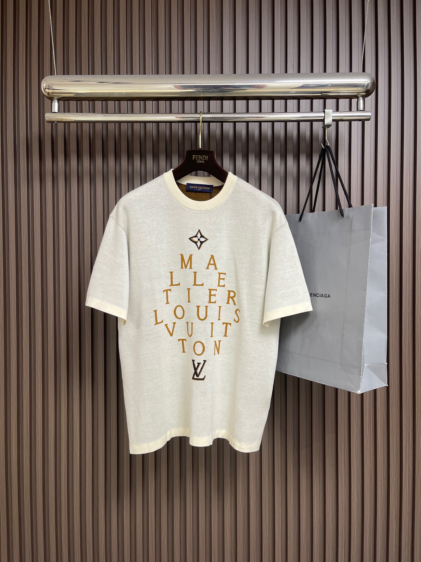 NO:847369,LV letter slogan color block jacquard knitted short-sleeved T-shirt, this LOUIS VUITTON  FW26 men's letter-printed T-shirt is made of high-quality pure cotton fabric. It feels soft and skin-friendly, has good breathability and sweat absorption, and is comfortable to wear. The overall design adopts a neat round neck and fitted tailoring, with clean and neat lines, suitable for a variety of body shapes. The brand's iconic orange-tone letters are printed on the front, paired with the classic LV logo, arranged in a creative shape.  The color is bright and full, the printing process is fine and firm, and it is not easy to fall off and deform after being washed for a long time. The stitching is neat and fine, and the details show the brand's ingenuity and quality. It is simple and has a light luxury style, which can easily control the daily casual and light business wear scenes, injecting high-end texture and fashion into the style. The overall wiring is straight and delicate, the fabric is comfortable and soft, and the color is consistent without color difference.  It can be matched with the same style to create a fashionable look, and can be used in various occasions. Customized accessories, complete with three standards, same style for men and women!  Size S-XL S size Bust 108 Shoulder width 50 Clothing length 67 Medium Bust 112 Shoulder width 51 Clothing length 69 L Size Bust 116 Shoulder width 52 Clothing length 7119860909LV 字母标语拼色提花针织短袖T恤,这款LOUIS VUITTON FW26男款字母印花T恤,甄选优质纯棉面料打造,触感柔软亲肤,透气吸汗性佳,穿着舒适自在.整体采用利落圆领与合身剪裁,线条干净利落,适配多种身形.正面以品牌标志性橙色调字母印花,搭配经典LV标识,排列成创意造型,色彩鲜亮饱满,印花工艺精细牢固,久洗不易脱落变形.车线工整细密,细节处彰显品牌匠心品质,简约中透着轻奢格调,轻松驾驭日常休闲与轻商务穿搭场景,为造型注入高级质感与时尚气息.整体走线平直细腻,面料舒适柔软,颜色一致无色差 能与同款搭配营造时尚造型,驾驭各种场合,定制辅料,三标齐全,男女同款！尺码S-XL S码 胸围108 肩宽50 衣长67 M码胸围112肩宽51 衣长69 L码 胸围116肩宽52 衣长71 XL码胸围120肩宽53 衣长73,,louis vuitton,louis vuitton,T-shirt,tees，t-shirt,,Men's clothing