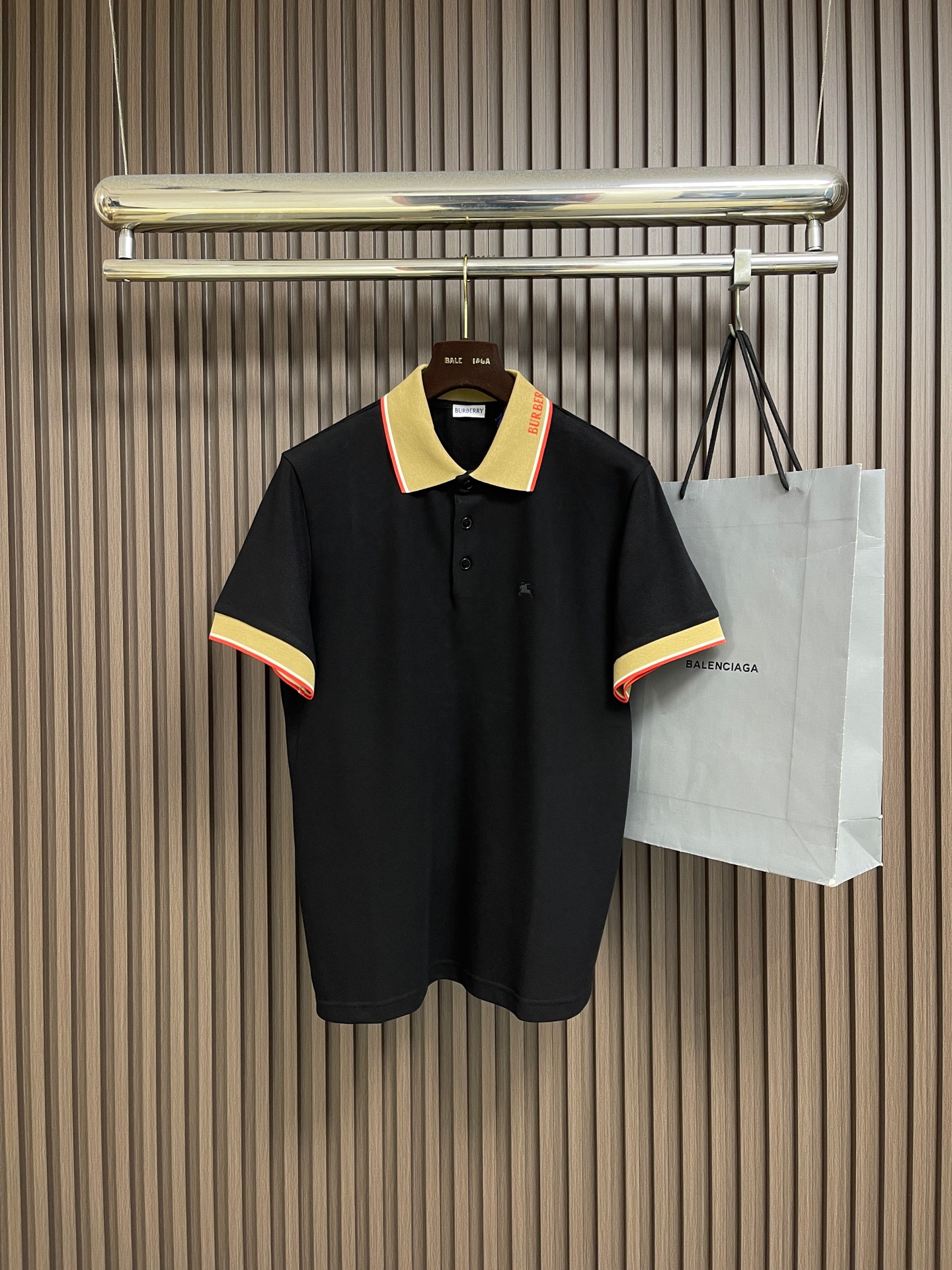 NO:848714,Burberry  The letter logo short-sleeved POLO shirt uses cotton as the base and a small amount of elastic fiber blended pique fabric. It forms a concave and convex mesh texture through a special knitted coil structure. Each group of coils is interlaced with each other to form a breathable 'small honeycomb' structure. The feeding of elastic fibers greatly improves the wrinkle resistance of the fabric, and it is not easy to leave marks when folded at will. It is always smooth and neat for daily wear. At the same time, the pique texture is fine and layered, and the visual effect is  It feels matte and low-key, soft to the touch but not sinewy. Iron the front of the fabric flat in advance, accurately mark the embroidery position, install the embroidery frame on the machine, and align the center point of the pattern. Use high-saturation embroidery thread and pass it through high-density filling needles. The stitches are fine and even, making the knight and war horse pattern clear and layered, visually embossed and not easy to deform. After finishing, the edges of the pattern are smooth, without hard edges, and there is no foreign body feeling when worn against the skin.  The letters on the collar side are integrated into the jacquard weaving process instead of post-printing or embroidery. The letters and contrasting stripes are directly formed by the loom. The lines are clear and neat, with no redundant burrs on the edges. The pattern is integrated with the fabric, and it is not easy to fall off and crack after repeated friction and machine washing. It uses high-permeability resin buttons with a smooth surface and no burrs. The letter logo is engraved in the center of the button. The texture is high-end and wear-resistant. The overall wiring is straight and delicate, the fabric is comfortable and soft, and the color is consistent without color difference.  Can be matched with the same style to create a fashionable look, control various occasions, customized accessories, complete three standards, the same style for men and women. Sizes S-XL 46-52 46 yards shoulder width 47 bust 108 length 68.5 48 yards shoulder width 48 chest 112 length 70 50 yards shoulder width 49 bust 116 length 71.5 52 yards  Shoulder width 50, bust 120, length 73, burberry, T-shirt,19860909Burberry 字母标识短袖POLO衫,选用棉为基底喂入少量弹性纤维混纺而成的珠地布面料,通过特殊的针织线圈结构形成凹凸的网眼纹理,每一组线圈相互交错,构成透气的“小蜂巢”结构.弹性纤维的喂入,大幅提升面料抗皱性,随意折叠也不易留痕,日常穿着始终平整利落.同时珠地纹理细腻且富有层次,视觉上哑光低调,触感柔软却不失筋骨.将面料前幅,提前熨烫平整,精准标记刺绣位置,将绣花框装入机台,对齐图案中心点.选用高饱和度绣线通过高密度填充针,针脚细密均匀,使骑士与战马图案轮廓清晰,层次分明,视觉上有浮雕感,不易变形.后整理之后,图案边缘平滑,无硬边,贴肤穿着无异物感 领侧的字母采用一体提花织入工艺,而非后期印花或刺绣,字母与撞色条纹均通过织机直接成型,线条清晰利落、边缘无冗余毛边,图案与面料融为一体,反复摩擦、机洗也不易脱落开裂.采用高透树脂纽扣,表面光滑无毛刺,纽扣中心刻有字母标识,质感高级且耐磨.整体走线平直细腻,面料舒适柔软,颜色一致无色差 能与同款搭配营造时尚造型,驾驭各种场合,定制辅料,三标齐全,男女同款.尺码S-XL 46-52 46码 肩宽47胸围108衣长68.5 48码 肩宽48胸围112衣长70 50码 肩宽49胸围116衣长71.5 52码 肩宽50胸围120衣长73,,burberry,T-shirt,,Men's clothing