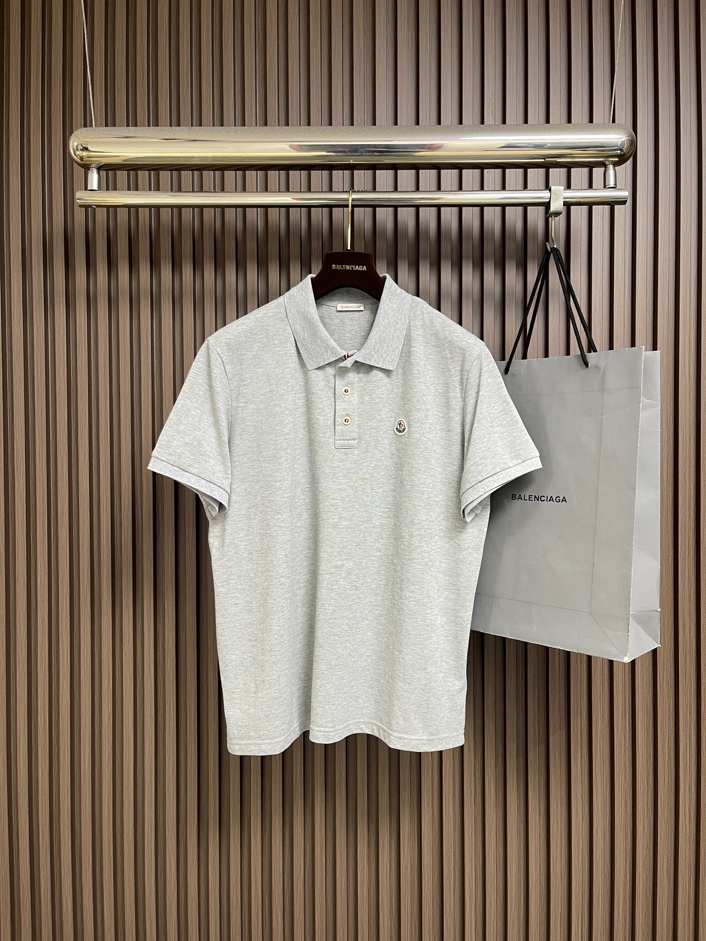 NO:848707,MONER  Logo patch short-sleeved polo shirt, the fabric is made of cotton using pique knitting technology, and a concave and convex mesh texture is formed through a special knitted coil structure. Each group of coils are interlaced with each other to form a breathable 'small honeycomb' structure, forming a pique fabric with a weight of 200g㎡, taking into account both stiffness and drape. The pique mesh structure forms a natural breathable channel, which can quickly export moisture from the body surface and prevent sweating. At the same time, the pique texture is fine and layered, visually dumb  The light is low-key, soft to the touch but not sinewy. The bottom of the placket is decorated with a three-color webbing woven with a customized high-density woven process. The colors are bright and full, and the edges are smooth and lint-free. When paired with custom mother-of-pearl buttons, it forms a strong visual sense of hierarchy. The buttons have delicate brand engravings on the surface, which are warm and textured, and will not be scratched or faded when opened and closed repeatedly. The three-color webbing subtly strengthens the structural stability of the placket, making the overall routing neater. Sizes S-XL  46-52 Size 46 Shoulder width 47 Bust 108 Length 68 Size 48 Shoulder width 48 Bust 112 Length 69.5 Size 50 Shoulder width 49 Bust 116 Length 71 Size 52 Shoulder width 50 Bust 120 Length 72.5,,T-shirt,19860909MONER 标识贴片短袖polo衫,面料选用棉采用珠地针织工艺,通过特殊的针织线圈结构形成凹凸的网眼纹理,每一组线圈相互交错,构成透气的“小蜂巢”结构,形成克重达200g㎡的珠地布,兼顾挺括感与垂坠性.珠地网眼结构形成天然透气通道,能快速导出体表湿气,不闷汗,同时珠地纹理细腻且富有层次,视觉上哑光低调,触感柔软却不失筋骨.门襟底饰有定制高密度梭织工艺编织而成的三色织带,色彩鲜亮饱满、边缘平整不起毛,与定制母贝纽扣搭配,形成强烈的视觉层次感.纽扣表面带有细腻的品牌刻纹,温润有质感,反复开合也不会刮花掉色；三色织带巧妙地强化了门襟的结构稳定性,让整体走线更工整利落.尺码S-XL 46-52 46码 肩宽47胸围108衣长68 48码 肩宽48胸围112衣长69.5 50码 肩宽49胸围116衣长71 52码 肩宽50胸围120衣长72.5,,T-shirt,,Men's clothing