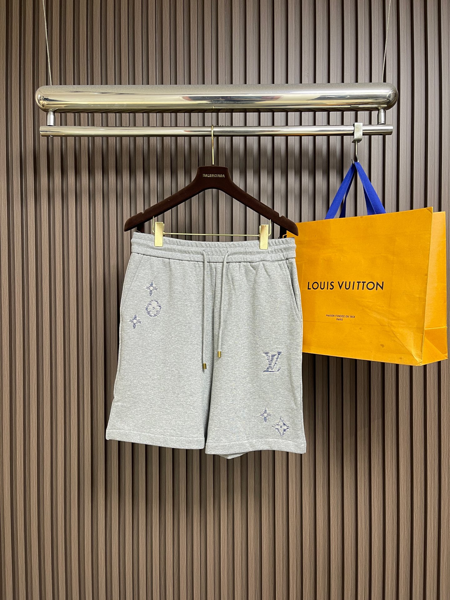 NO:875276,Tops shorts LV  Embroidered logo hooded zipper sweatshirt, jacket and shorts set, made of terry knitted fabric, soft and waxy texture, skin-friendly and breathable, with excellent drape, comfortable and comfortable on the upper body, and not easy to pill and deform after long-term wear; the body uses delicate embroidery technology, inspired by the brand's iconic Monogram elements, to create exquisite LV letters and flower logo embroidery, the stitching is fine and smooth, and the color  The transition is natural and low-key, showing a luxurious texture; the placket adopts a customized metal zipper with the brand logo engraved on the zipper pull, which opens and closes smoothly and is full of texture; there is a large-sized kangaroo pocket on the front, with neat and tight routing, which is practical and adds a sense of layering to the body; the cuffs and hem are made of ribbed edge technology, with moderate elasticity, comfortable to wear but not restrictive, and the loose-shoulder cut is not flattering on the figure.  Sizes S-XL,,louis vuitton,hoodie,sweatshirts,shorts,jackets & coats,hats,19860909上衣 短裤 LV 刺绣标识连帽拉链卫衣外套短裤套装,采用毛圈针织面料,质地软糯,触感亲肤透气,兼具出色垂坠感,上身舒适自在,久穿不易起球变形；衣身采用细腻刺绣工艺,以品牌标志性Monogram元素为灵感,打造精致的LV字母与花卉标识刺绣,针脚细密平整,色彩过渡自然,低调中尽显奢华质感；门襟采用定制金属拉链,拉链头刻有品牌标识,开合顺滑流畅,质感十足；正面设有大尺寸袋鼠口袋,走线工整紧密,实用之余增添衣身层次感；袖口与下摆采用罗纹收边工艺,弹性适中,穿着舒适不勒身,宽松落肩版型剪裁不挑身材. 尺码S-XL,,louis vuitton,hoodie,sweatshirts,shorts,jackets & coats,hats,,Men's clothing