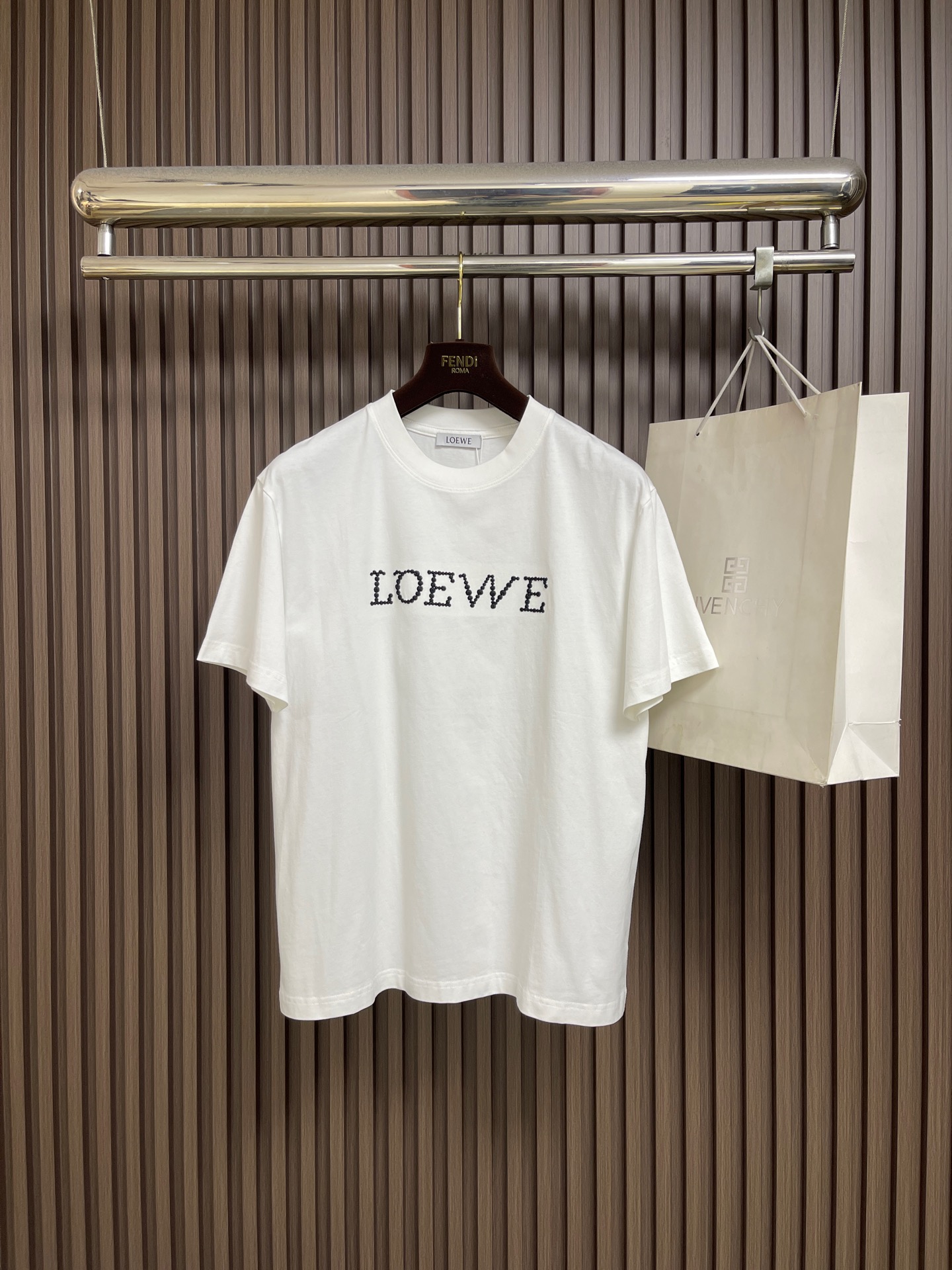 NO:875289,Loewe's classic letter logo embroidered short-sleeved T-shirt is finished with exquisite logo embroidery, simple but not simple!  Delicate embroidery craftsmanship outlines the brand's iconic pattern, and the texture is perfect. The pure cotton fabric is breathable and skin-friendly, and the classic round neck + loose fit adapts to various body shapes. It can be easily controlled for daily commuting, casual outings, or layering. It shows low-key high-end taste and creates a 'less is more' textured outfit~ Sizes M-3XL M, length 67, shoulder width 47.5, bust 104, size L, length 69, shoulder width 49, bust 108 XL  Length 71, shoulder width 50.5, bust 112 XXL, length 73, shoulder width 52, bust 116 XXXL, length 75, shoulder width 53.5, bust 120,,loewe,T-shirt,tees,t-shirt,19860909Loewe 经典字母logo刺绣短袖T恤,以精致logo刺绣点睛,简约不简单！细腻刺绣工艺勾勒品牌标志性图案,质感满分.纯棉面料透气亲肤,经典圆领+宽松版型适配各种身形,日常通勤、休闲出街或叠穿都能轻松驾驭,低调彰显高级品味,打造“less is more”的质感穿搭～尺码M-3XL M码 衣长67肩宽47.5 胸围104 L码衣长69肩宽49 胸围108 XL码 衣长71 肩宽50.5 胸围112 XXL码 衣长73 肩宽52 胸围116 XXXL码衣长75 肩宽53.5 胸围120,,loewe,T-shirt,tees，t-shirt,,Men's clothing
