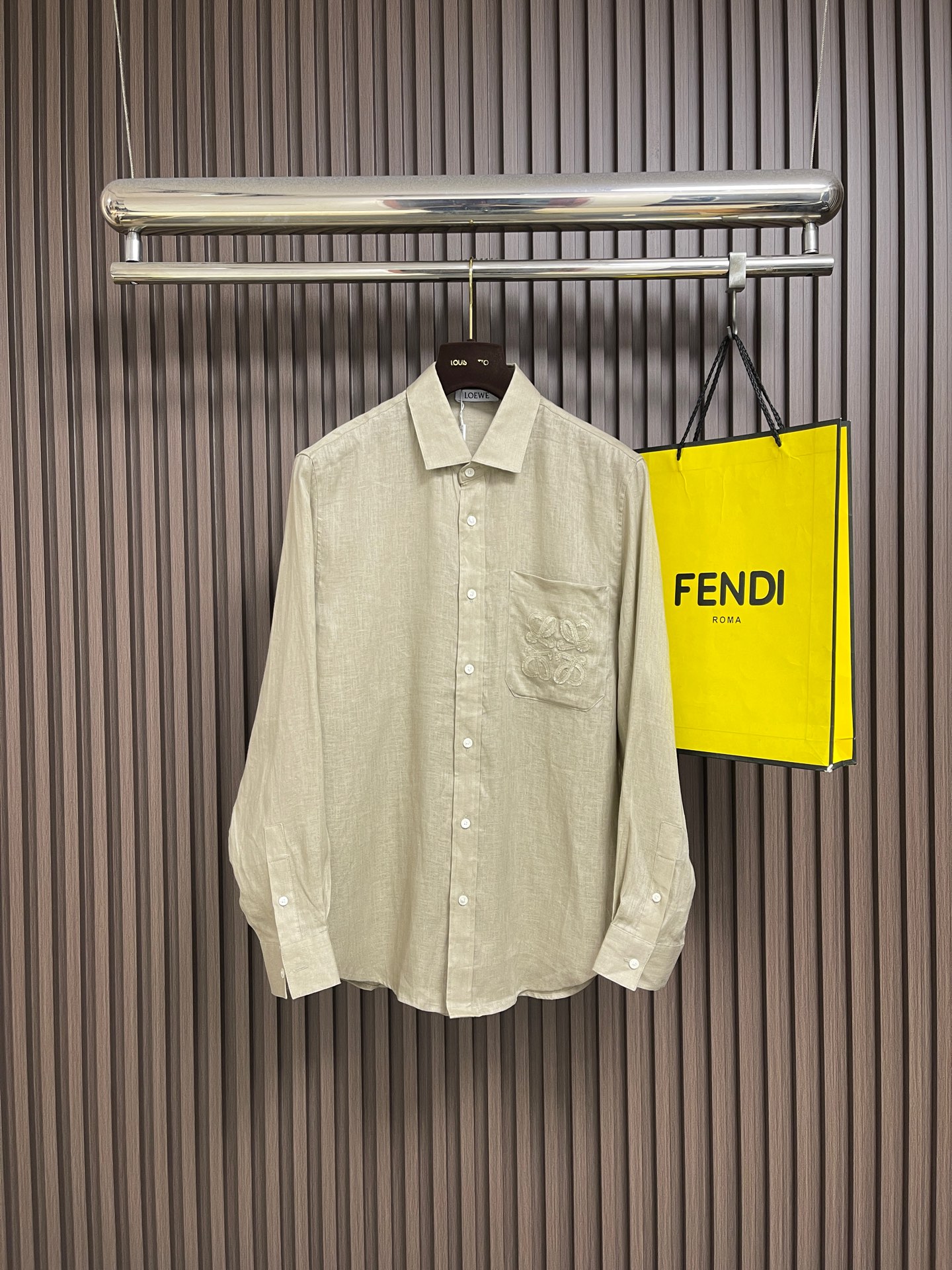 NO:911617,Loewe  The 2026SS new summer embroidered linen long-sleeved shirt is a fusion of viscose fiber and linen, and realizes fiber interlocking through air-spinning technology. The smooth drape of viscose fiber neutralizes the rough texture of linen, and the skeletal support of linen makes up for the shortcomings of viscose fiber's easy deformation. The higher moisture absorption rate of viscose fiber is linked with the porous fiber structure of linen to form a dual-channel sweat removal system. It has both wrinkle resistance and drape, reflecting the two fibers.  Features given by fusion. The Anagram totem on the chest patch pocket adopts hidden hook embroidery technology, using extremely fine silk threads to evolve a precision matrix of 320 stitches CM2 on the linen base, which resonates at the same frequency as the natural texture of the fabric. The inner lining is embedded with anti-stretch mesh underlay to ensure that the embroidery remains as smooth as ever after frequent use. Size 38/S-39/M-40/L-41/XL-42/XXL  38/S size shoulder width 45 bust 103 length 75 39/M size shoulder width 46 bust length 76 40/L size shoulder width 47 bust 113 length 78 41/XL size shoulder width 49 bust 118 length 80 42/XXL shoulder width 50 bust 123 length 81,,loewe,shirts,19860909Loewe 2026SS夏季新款绣花亚麻长袖衬衫,以粘胶纤维与亚麻融合,通过气流纺纱技术实现纤维互锁,粘纤的柔滑垂坠感中和亚麻的粗粝肌理,亚麻的骨感支撑力弥补粘纤易变形的短板.粘纤较高的吸湿率与亚麻的多孔纤维结构联动,形成双通道排汗系统.抗皱性与垂坠感兼得,体现两种纤维融合赋予的特性.胸前贴袋的Anagram图腾,采用隐式勾针刺绣工艺,以极细丝线在亚麻基底上演化出320针CM2的精密矩阵,与布料天然纹理同频共振.内衬植入抗拉伸网纱衬底,确保频繁使用后刺绣依然平整如初.尺码38/S-39/M-40/L-41/XL-42/XXL 38/S码肩宽45 胸围103衣长75 39/M码 肩宽46 胸围衣长76 40/L码肩宽47 胸围113衣长78 41/XL码 肩宽49 胸围118衣长80 42/XXL码肩宽50 胸围123衣长81,,loewe,shirts,,Men's clothing