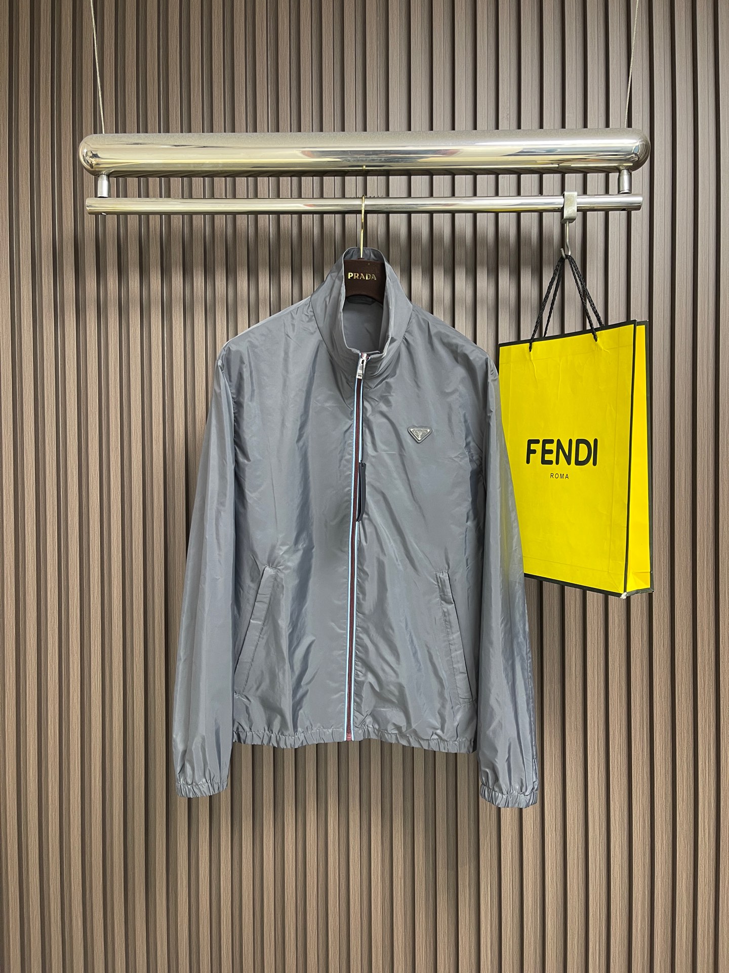NO:911621,Prada  Zipper-trimmed stand-up collar jacket, made of selected high-density woven nylon fabric, with firm and full fiber texture, light and thin overall texture, and zero weight on the upper body. After the fabric has been treated with water-repellent treatment, slight wet water will not easily adhere to it, and it also has excellent anti-fouling ability, making daily stains easy to wipe and clean. The fiber characteristics make the woven fabric tough.  Excellent, tear-resistant and anti-snagging, not prone to wrinkling and collapse when worn for a long time, and can maintain a neat and crisp silhouette even when worn for a long time, taking into account both beauty and practicality. It adopts an embedded double-layered edge zipper placket, the outside of the burgundy zipper teeth is covered with light blue webbing, and the outer layer is wrapped with gray fabric, and the zipper tape is fixed and routed with two fine topstitches.  Uniform and straight, the appearance is neat and layered. The custom-engraved metal puller drives the opening and closing. After the finished garment is finished, it is ironed at low temperature to smooth out the wrinkles and trim the threads. The left and right plackets are symmetrical and regular, and the hemming width is consistent, which not only improves the windproof sealing, but also combines durability and high-end texture. The hem and cuffs adopt a double-layer elastic gathering process to ensure smoothness.  The smooth nylon fabric is folded and overlocked with embedded elastic bands, and the double threads are evenly sewn and fixed. The stitch length is regular and fine, and the pleats are evenly arranged and natural. The elasticity is moderate, tightening to fit the body shape without tightening the skin, effectively blocking the intrusion of wind and rain, and improving the windproof and temperature locking effect. The overall wiring is straight and delicate, the fabric is comfortable and soft, and the color is consistent without color difference.  Can be matched with the same style to create a fashionable look, to suit various occasions, customized accessories, complete with three standards!  Sizes S-XL S size Shoulder width 51 Bust 118 Length 69 Medium Shoulder width 52 Bust 122 Length 70.5 L size Shoulder width 53 Bust 126 Length 72 XL Shoulder width 54 Bust 130 Length 73.5,,prada,jackets & coats,jackets & coats,19860909Prada 拉链饰边立领夹克外套,精选高密织造尼龙面料,纤维肌理紧实饱满,整体质地轻盈轻薄,上身零负重.面料经过防泼水处理之后,轻微湿水不易附着,同时具备优良抗污能力,日常污渍易擦拭清洗.纤维特性使织成的面料韧性出色,抗撕裂、防勾丝,久穿不易起皱塌陷,长久穿着也能维持利落挺括的廓形,兼顾美观与实用性.采用嵌入式双层包边拉链门襟,酒红色拉链齿外侧包覆浅蓝色织带,外层再用灰色衣料包裹拉链布带,两道精细明线固定,走线均匀笔直,外观整洁层次分明.定制刻标金属拉头带动开合,成衣之后进行低温整烫抚平褶皱、修剪线头,门襟左右对称规整,包边宽度一致,既提升防风密封性,又兼具耐用性与高级质感.下摆与袖口采用双层松紧收束工艺,光滑尼龙面料对折包缝内嵌松紧带,双线均匀车缝固定,针距规整细密,褶皱排布匀称自然.松紧弹力适中,收紧贴合身形又不紧绷勒肤,有效阻挡风雨灌入,提升防风锁温效果.整体走线平直细腻,面料舒适柔软,颜色一致无色差 能与同款搭配营造时尚造型,驾驭各种场合,定制辅料,三标齐全！尺码S-XL  S码 肩宽51 胸围118 衣长69 M码肩宽52 胸围122 衣长70.5 L码 肩宽53 胸围126 衣长72 XL码 肩宽54 胸围130 衣长73.5,,prada,jackets & coats,jackets & coats,,Men's clothing