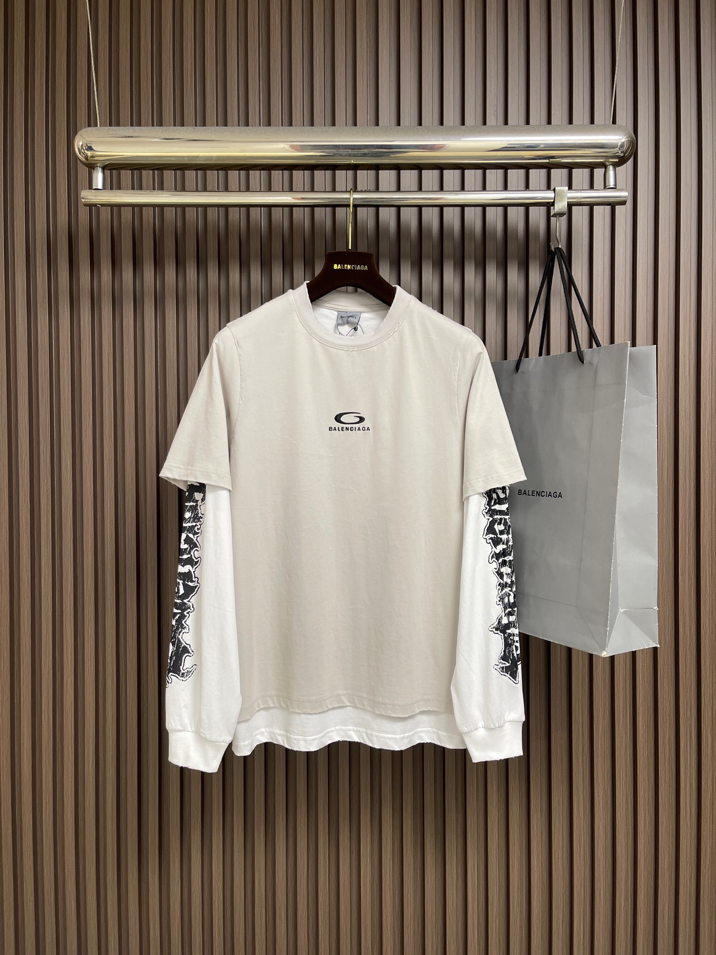 NO:935660,Balenciaga  Fake two-piece T-shirt with printed embroidery logo. This fake two-piece T-shirt with printed embroidered logo is made of heavy washed cotton fabric. The fabric is soft and breathable. It has been pre-shrunk and is not prone to shrinkage and deformation. It adopts a layered fake two-piece structure design, with a round neckline and regular workmanship. The brand logo is sewn on the chest with fine embroidery technology. The stitches are fine and full, strong and not easy to fall off. The inner long sleeves use high-definition digital printing technology, the Gothic pattern is clear and three-dimensional, and the ink adheres stably.  , resistant to washing and not easy to fade and crack. The body is made of neat flat stitching, and the hem is double-layered and trimmed to restore the original raw edge details. The cuffs are tightly and neatly trimmed. The overall style is loose and dropped shoulders, with accurate size and cutting proportions, and the fabric color  It has excellent fastness and takes into account street style. It can be worn alone or as an inner layer. The solid sewing process further improves the durability of the clothing. The overall wiring is straight and delicate, the fabric is comfortable and soft, and the color is consistent without color difference.  Can be matched with the same style to create a fashionable look, to suit various occasions, customized accessories, complete with three standards. Sizes S-M-L-XL, balenciaga, tees, t-shirt,19860909Balenciaga 假两件印花刺绣标识T恤,这款假两件印花刺绣标识T恤选用重磅水洗棉面料,面料柔软透气,经过预缩水处理,不易出现缩水变形问题.采用分层式假两件结构设计,圆领领口做工规整,胸前采用精细刺绣工艺缝制品牌标识,针脚细密饱满,牢固不易脱线.内层长袖袖身运用高清数码印花工艺,哥特式图案清晰立体,油墨附着稳定,耐水洗不易褪色开裂.衣身各处采用工整平缝车线,下摆做双层拼接裁边,还原原版毛边细节,袖口收边紧实利落.整体为宽松落肩版型,尺码剪裁比例精准,面料色牢度优良,兼顾街头潮流风格,既可以日常单穿,也能够作为内搭,扎实的缝制工艺进一步提升了服饰的耐穿程度.整体走线平直细腻,面料舒适柔软,颜色一致无色差 能与同款搭配营造时尚造型,驾驭各种场合,定制辅料,三标齐全.尺码S-M-L-XL,,balenciaga,tees，t-shirt,,Men's clothing
