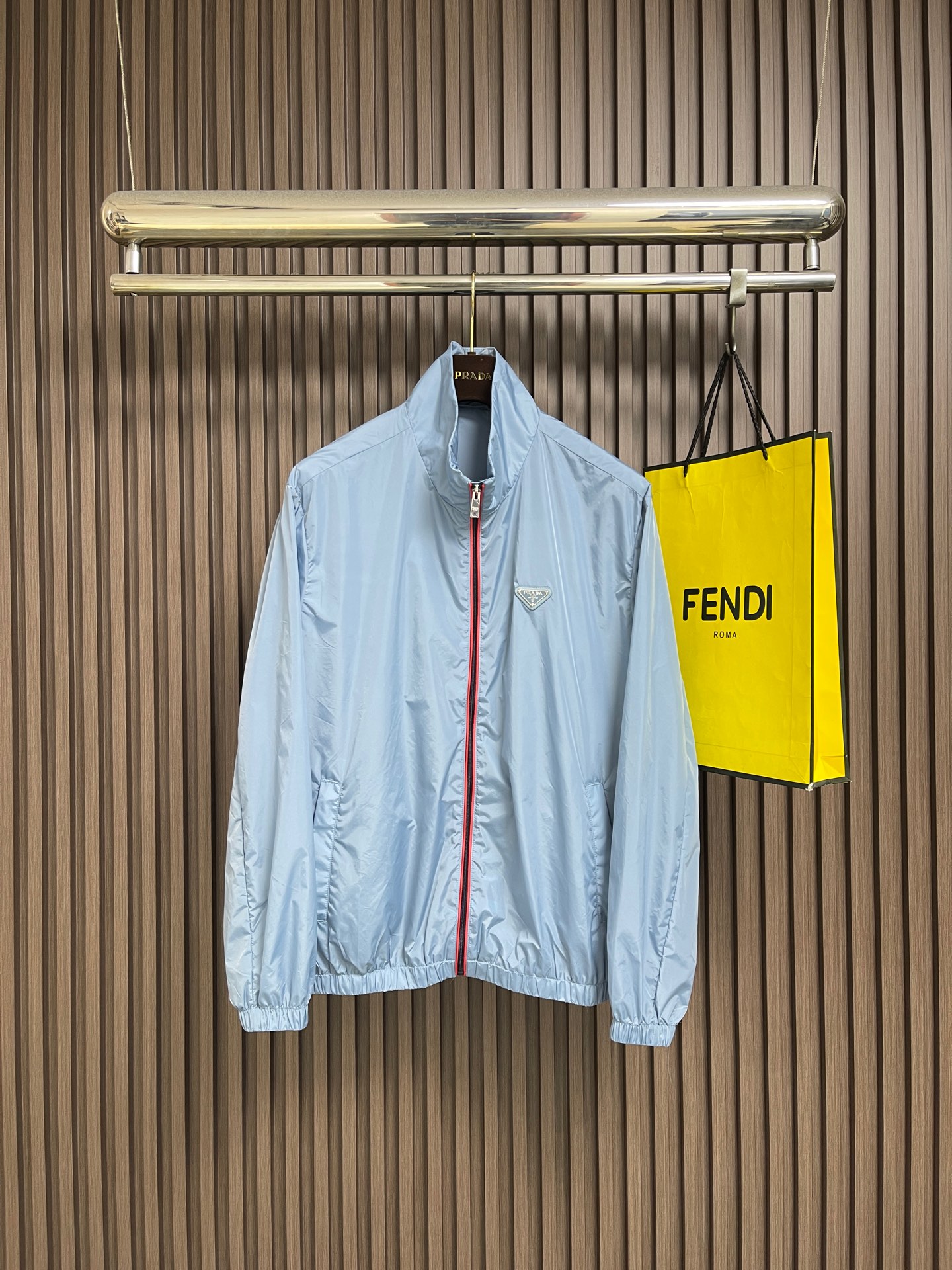 NO:914578,Prada  Zipper-trimmed stand-up collar jacket, made of selected high-density woven nylon fabric, with firm and full fiber texture, light and thin overall texture, and zero weight on the upper body. After the fabric has been treated with water-repellent treatment, slight wet water will not easily adhere to it, and it also has excellent anti-fouling ability, making daily stains easy to wipe and clean. The fiber characteristics make the woven fabric tough.  Excellent, tear-resistant and anti-snagging, not prone to wrinkling and collapse when worn for a long time, and can maintain a neat and crisp silhouette even when worn for a long time, taking into account both beauty and practicality. It adopts an embedded double-layered edge zipper placket, the outside of the burgundy zipper teeth is covered with light blue webbing, and the outer layer is wrapped with gray fabric, and the zipper tape is fixed and routed with two fine topstitches.  Uniform and straight, the appearance is neat and layered. The custom-engraved metal puller drives the opening and closing. After the finished garment is finished, it is ironed at low temperature to smooth out the wrinkles and trim the threads. The left and right plackets are symmetrical and regular, and the hemming width is consistent, which not only improves the windproof sealing, but also combines durability and high-end texture. The hem and cuffs adopt a double-layer elastic gathering process to ensure smoothness.  The smooth nylon fabric is folded and overlocked with embedded elastic bands, and the double threads are evenly sewn and fixed. The stitch length is regular and fine, and the pleats are evenly arranged and natural. The elasticity is moderate, tightening to fit the body shape without tightening the skin, effectively blocking the intrusion of wind and rain, and improving the windproof and temperature locking effect. The overall wiring is straight and delicate, the fabric is comfortable and soft, and the color is consistent without color difference.  Can be matched with the same style to create a fashionable look, to suit various occasions, customized accessories, complete with three standards!  Size S-XL S size bust 119 shoulder width 52 length 67 M size bust 123 shoulder width 53 length 68.5 L size bust 127 shoulder width 54 length 70 XL size bust 131 shoulder width 55 length 72.5,,prada,jackets & coats,jackets & coats,19860909Prada 拉链饰边立领夹克外套,精选高密织造尼龙面料,纤维肌理紧实饱满,整体质地轻盈轻薄,上身零负重.面料经过防泼水处理之后,轻微湿水不易附着,同时具备优良抗污能力,日常污渍易擦拭清洗.纤维特性使织成的面料韧性出色,抗撕裂、防勾丝,久穿不易起皱塌陷,长久穿着也能维持利落挺括的廓形,兼顾美观与实用性.采用嵌入式双层包边拉链门襟,酒红色拉链齿外侧包覆浅蓝色织带,外层再用灰色衣料包裹拉链布带,两道精细明线固定,走线均匀笔直,外观整洁层次分明.定制刻标金属拉头带动开合,成衣之后进行低温整烫抚平褶皱、修剪线头,门襟左右对称规整,包边宽度一致,既提升防风密封性,又兼具耐用性与高级质感.下摆与袖口采用双层松紧收束工艺,光滑尼龙面料对折包缝内嵌松紧带,双线均匀车缝固定,针距规整细密,褶皱排布匀称自然.松紧弹力适中,收紧贴合身形又不紧绷勒肤,有效阻挡风雨灌入,提升防风锁温效果.整体走线平直细腻,面料舒适柔软,颜色一致无色差 能与同款搭配营造时尚造型,驾驭各种场合,定制辅料,三标齐全！尺码S-XL S码胸围119 肩宽52衣长67 M码 胸围123 肩宽53衣长68.5 L码胸围127 肩宽54衣长70 XL码 胸围131 肩宽55衣长72.5,,prada,jackets & coats,jackets & coats,,Men's clothing