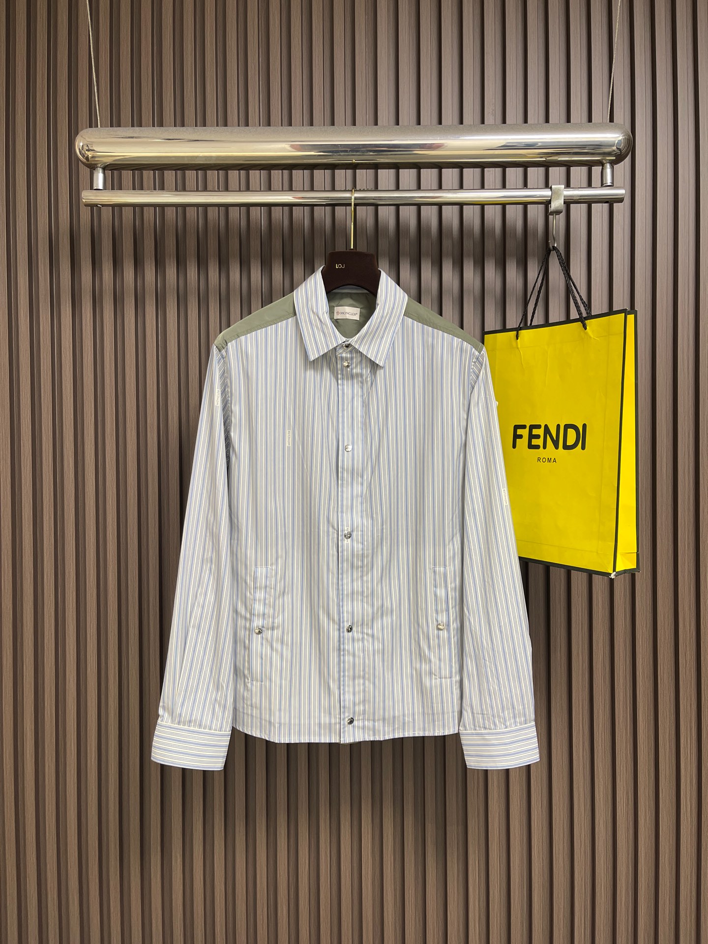 NO:928810,Moncler  2026SS new spring and summer striped patchwork shirt. The main body of the shirt is made of high-count yarn-dyed pure cotton poplin. The fine blue and white vertical stripes have a refreshing and attractive texture. The cloth surface is flat and wrinkle-resistant. The upper body is breathable, skin-friendly and not stuffy. The shoulders are made of military green nylon fabric with contrasting colors.  Splicing, a whole piece of khaki nylon interlining on the back, taking into account the stiff shape and light breathability, the transition stitching is neat and tight, the layered design is high-end and not monotonous. The details are full of recognition, the classic circular embroidered badge on the left arm is exquisite and three-dimensional but not cheap; door  The placket has a built-in brand-customized metal zipper, and the outer layer is equipped with a double-layered opening and closing with metal snap buttons with the same engraving. The snap button pockets on both sides take into account both storage and beauty. The double brand metal buttons on the cuffs can be freely adjusted for tightness. The loose slightly dropped shoulder version is not flattering on the figure, and can be worn alone.  It has a refreshing youthful feel, suitable for both inner and outer wear. It can be worn in spring, summer, early autumn, and can be used for commuting, traveling, and light business meetings. It has an Italian light luxury outdoor casual style. Mature men just need to wear a layered jacket when the season changes. Size 38-39-40-41  S-XL Size 38 bust 118 shoulder width 52 length 77 Size 39 bust 122 shoulder width 53 length 78 Size 40 bust 126 shoulder width 54 length 79 Size 41 bust 130 shoulder width 55 length 80,,jackets & coats,shirts,19860909Moncler 2026SS春夏新品条纹拼接衬衫,衣身主体甄选高支色织纯棉府绸,细密蓝白竖条纹肌理清爽耐看,布面平整抗皱,上身透气亲肤不闷汗；肩部采用军绿色尼龙面料撞色拼接,后背整片卡其锦纶衬布,兼顾挺括版型与轻薄透气性,过渡拼接走线工整严密,层次设计高级不单调.细节拉满辨识度,左臂经典圆形刺绣徽章,精致立体不廉价；门襟内置品牌定制金属拉链,外层搭配同刻字金属按扣双层开合,两侧按扣口袋兼顾收纳与美观,袖口双颗品牌金属纽扣可自由调节松紧.宽松微落肩版型不挑身材,单穿自带清爽少年感,内搭外搭都适配,春夏初秋三季可穿,通勤、出游、轻商务会面一件搞定,意式轻奢户外休闲风,成熟男士换季刚需叠穿神外套.尺码38-39-40-41 S-XL 38码胸围118 肩宽52衣长77 39码胸围122 肩宽53衣长78 40码胸围126 肩宽54衣长79 41码胸围130 肩宽55 衣长80,,jackets & coats,shirts,,Men's clothing