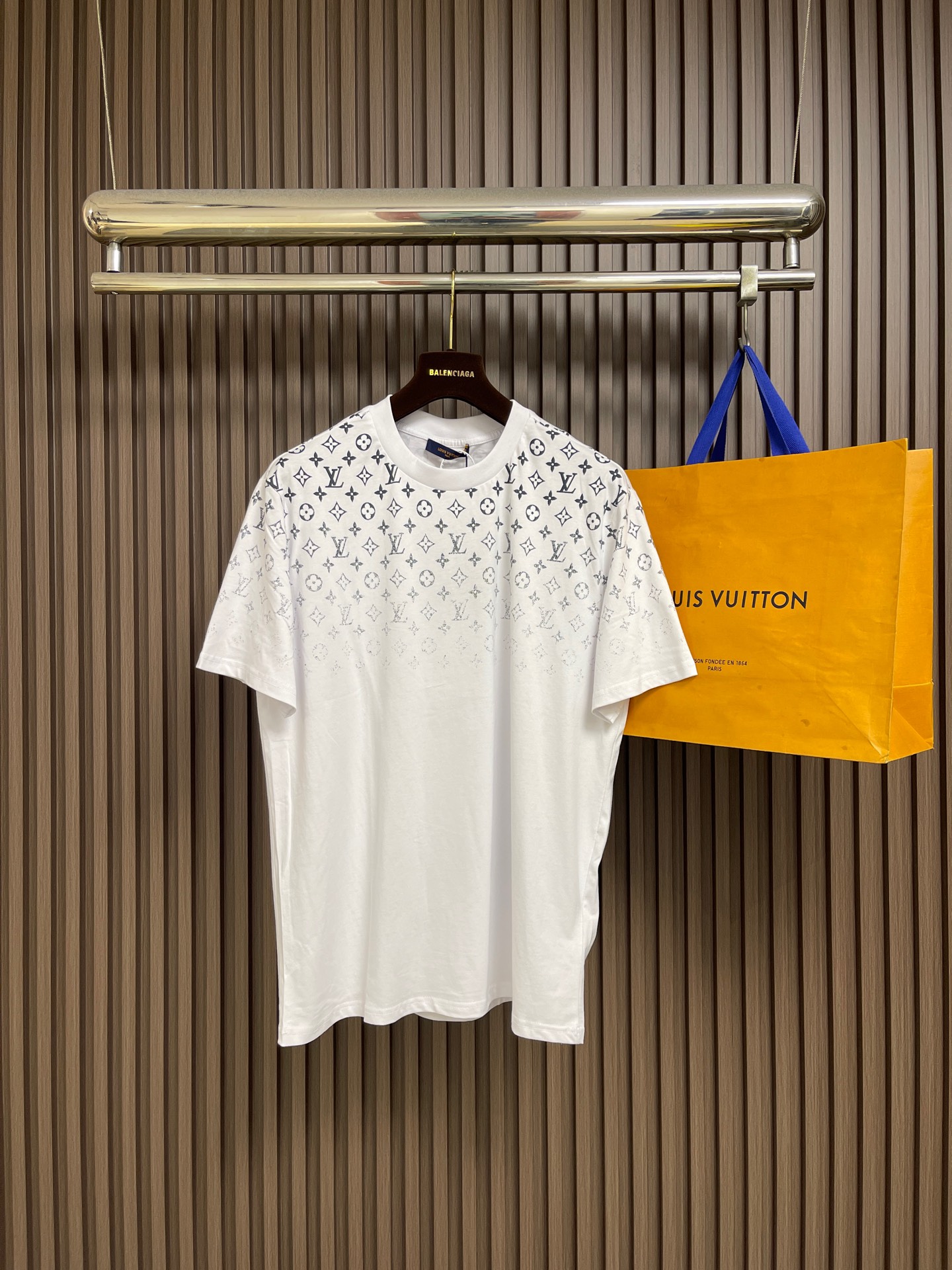 NO:928717,LV Gradient Presbyopia T-shirt, the fabric is made of 32s double-ply combed cotton tightly spun yarn, matched with 1*1 flat knitted cotton thread. The front and rear left and right sleeves of the whole piece of clothing are printed with Kornit white ink digital direct injection. The first draft is made based on the Y-version scanned pattern, and the clarity of the first draft is corrected by hand drawing to ensure that the printed flower pieces have a gradient and orderly visual effect. The overall routing is straight and delicate, the fabric is comfortable and soft, and the colors are consistent and without color difference.  It can be matched with the same style to create a fashionable look, and can be used in various occasions. Customized accessories, complete with three standards, same style for men and women!  Size SML19860909LV 渐变老花T恤,面料采用32s双股纱精梳棉紧密赛络纺纱线,配套1*1横机全棉螺纹,整件衣服前后幅左右袖均采用康丽白墨数码直喷印花,根据Y版扫描图案出初稿,手工绘制修正初稿清晰度,保证打印出来的花片有渐变有序的视觉效果.整体走线平直细腻,面料舒适柔软,颜色一致无色差 能与同款搭配营造时尚造型,驾驭各种场合,定制辅料,三标齐全,男女同款！尺码SMLXL S码衣长71　 胸围110　 肩宽48 M码 衣长72.5　 胸围114　 肩宽49 L码衣长74　 胸围118　 肩宽50 XL码 衣长75.5　 胸围122　 肩宽51,,louis vuitton,tees，t-shirt,,Men's clothing
