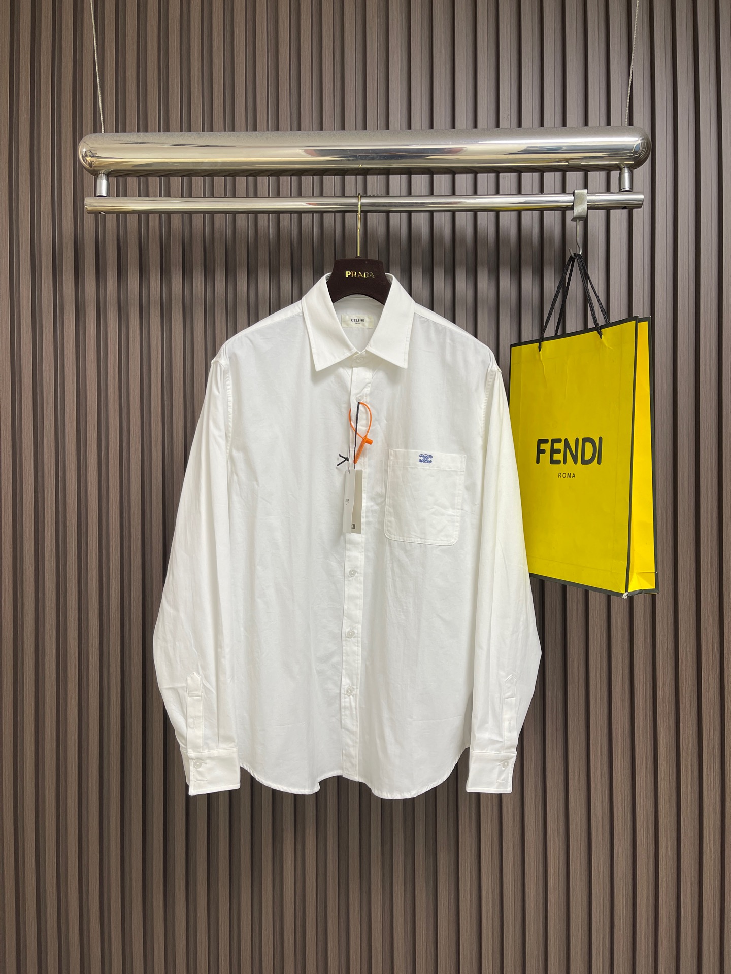 NO:945984,Celine logo embroidered long-sleeved shirt, custom-made luxurious and tough double-weft Oxford fabric. Stiff and stylish, comfortable and breathable. Made of gentle moonlight-soaked white as the base, it outlines the essence of luxury. Square-inch logo embroidery on the chest. The stitching is as meticulous as weaving. The contrasting colors are the finishing touch. It condenses Italian luxury and elegance. It strikes the right elegant balance between low-key restraint and avant-garde style. It adopts imported machine embroidery technology and uses advanced computer control systems and precision mechanical parts to realize the logo embroidery work.  High precision, smooth and delicate lines. The fabrics have been fermented and have a better hand feel. Not easy to deform, not easy to shrink, not easy to fade, and maintain long-term beauty. Sizes S-M-L-XL S size, back center length 76, bust 120, shoulder width 50, M size, back center length 77.5, chest girth 124, shoulder width 52, L size, back center length 79, chest girth 128, shoulder width 54  XL size back length 80.5, bust 132, shoulder width 56,,celine,shirts,19860909celine 徽标刺绣长袖衬衫,定制奢韧双纬牛津纺 挺括有型 舒适透气 以温柔的月光浸白为底 勾勒高级感的本质 胸口方寸徽标刺绣 针脚缜密如织 撞色点睛成韵 凝练意式奢雅风骨 于低调内敛与先锋格调之间 拿捏恰到好处的优雅平衡,采用进口机刺绣工艺 使用先进的计算机控制系统和精密的机械部件 实现徽标刺绣作业 精度高 线条流畅而细腻 面料都经过酵洗 手感质感更佳 不易变形 不易缩水 不易褪色 保持长久的美观.尺码S-M-L-XL S码 后中长76 胸围120 肩宽50 M码 后中长77.5 胸围124 肩宽52 L码 后中长79 胸围128 肩宽54 XL码后中长80.5 胸围132 肩宽56,,celine,shirts,,Men's clothing