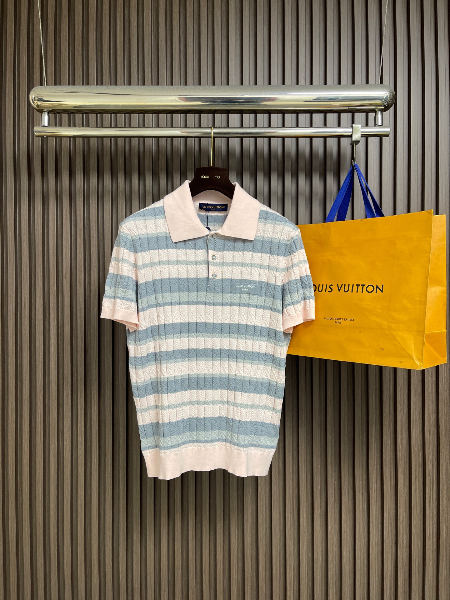NO:945919,LV  Letter emblem color-blocked striped knitted short-sleeved Polo shirt. This short-sleeved Polo is woven with high-count combed ice-feel knitted yarn. The whole body adopts a delicate cable twisted rope texture weaving. The stripes are layered with three-color contrasting horizontal stripes of lavender, light blue, and soft green.  The texture and color are dyed and finished using active color-fixing technology, which is not easy to fade and turn white after long-term wear. The collar is decorated with flat lapels of the same color, and the placket is equipped with three matte metal round buttons. The stitching is neat and dense, and the chest is decorated with small leather brand logos of the same color, and the sewing is flat.  There are no excess threads. The hem and cuffs are ribbed, with moderate elasticity and not easy to loosen and deform. The entire garment is woven with seamless side seams to reduce friction and discomfort. The light and breathable knitted structure is suitable for daily commuting and casual wear, and is tailored to fit the body shape.  Tight, not easy to pill or shrink after washing, taking into account delicate texture and practical and durable properties. The soft macaron color scheme is gentle and refreshing, and the rich texture layers enhance the sophistication of the item. The overall routing is straight and delicate, the fabric is comfortable and soft, and the color is consistent without color difference.  Can be matched with the same style to create a fashionable look, to suit various occasions, customized accessories, complete with three standards!  Size S-XL Size S, length 66, bust 108, shoulder width 44, sleeve length 22, size M, length 68, bust 112, shoulder width 45, sleeve length 22, size L, length 70, bust 116, shoulder width 46, sleeve length 23, XL size, length 72, bust 120, shoulder width 47, sleeve length 23,19860909LV 字母徽章拼色条纹针织短袖POLO衫,这件短袖Polo选用高支精梳冰感针织纱线织造,整体采用细腻绞花扭绳肌理织法,条纹部分分层融入淡紫、浅蓝、柔绿三色横条撞色织纹,色彩染整采用活性固色工艺,久穿不易褪色发白.领部做同色系平整翻领定型处理,门襟搭配三颗哑光金属圆扣,走线工整锁边密实,胸口点缀同色系皮质品牌小标,车缝平整无多余线头.下摆与袖口采用罗纹收边工艺,弹性适中不易松垮变形,整件衣物无缝侧缝织造减少摩擦不适感,轻薄透气的针织结构兼顾日常通勤与休闲穿搭,剪裁贴合身形不紧绷,水洗后不易起球、不易缩水,兼顾细腻质感与实穿耐穿属性,柔和马卡龙配色温柔清爽,肌理层次丰富提升单品精致度.整体走线平直细腻,面料舒适柔软,颜色一致无色差 能与同款搭配营造时尚造型,驾驭各种场合,定制辅料,三标齐全！ 尺码S-XL S码衣长66 胸围108 肩宽44 袖长22 M码 衣长68 胸围112肩宽45 袖长22 L码衣长70 胸围116肩宽46 袖长23 XL码 衣长72 胸围120肩宽47 袖长23,,louis vuitton,T-shirt,,Men's clothing