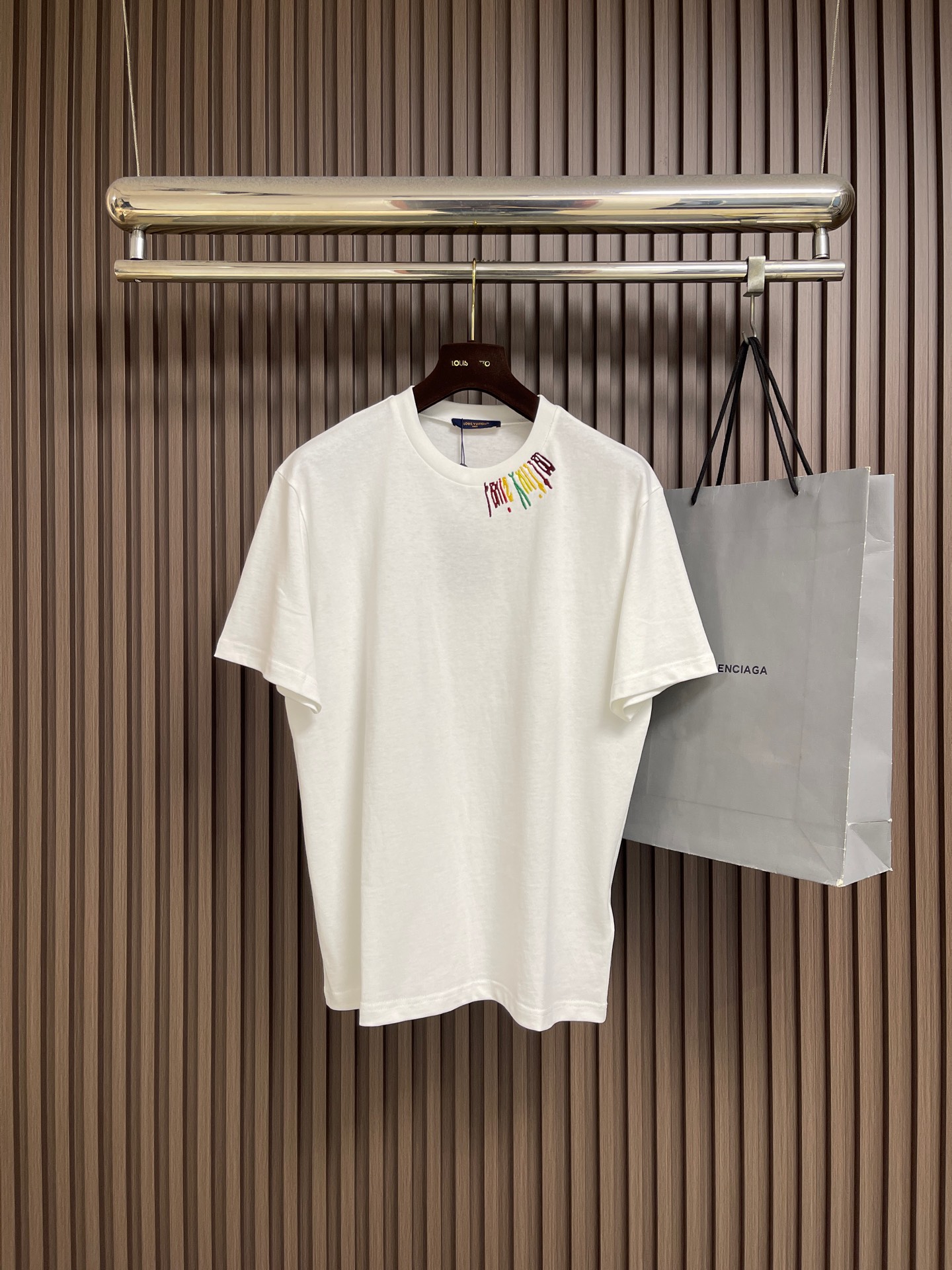 NO:945882,LV  Team color logo round neck short-sleeved T-shirt. This short-sleeved T-shirt is made of heavyweight double-ply combed pure cotton plain fabric. The fabric is thick and stiff and not easy to see through the skin. It has been pre-shrunk, washed and softly shaped. The upper body is skin-friendly and breathable, and will not shrink easily after repeated washing.  Deformation, stiffness and pilling. The neckline is made of reinforced double-layer rib weaving and is matched with anti-deformation hemming and sewing to prevent it from loosening and collapsing after long-term wear. The body of the garment uses environmentally friendly digital color printing technology to present contrasting color letter logos, and the ink penetrates the fabric fibers  , the printing is light and has no glue feel, is strong and washable without cracking or peeling, and the colors are bright, full, and even. The overall design is cut with a loose shoulder and dropped shoulders, and the four-thread overlocking process is used for the wiring. The seams are flat and firm, and the hem is double-layered with reinforced edging. The version is packaged.  It accommodates all body shapes. The overall workmanship is fine and regular, taking into account daily commuting and casual wear scenarios. It is comfortable and practical and fashionable, and the texture is high-end and durable. The overall routing is straight and delicate, the fabric is comfortable and soft, and the color is consistent without color difference.  Can be matched with the same style to create a fashionable look, to suit various occasions, customized accessories, complete with three standards!  Sizes XS-L19860909LV 团队彩标圆领短袖T恤,本款短袖T恤选用重磅双股精梳纯棉平纹面料,面料厚实挺括不易透肤,经过预缩水洗与柔软定型工艺,上身亲肤透气,多次水洗不易缩水变形、发硬起球.领口采用加固双层罗纹织法,搭配防变形包边车缝,久穿拉扯不易松垮塌陷.衣身采用环保数码彩印工艺呈现撞色彩色字母标识,墨水渗透面料纤维,印花轻薄无胶感,牢固耐洗不开裂、不剥落,色彩鲜亮饱满均匀.整体采用正肩宽松落肩剪裁,走线采用四线锁边工艺,接缝平整牢固,下摆双层加固包边,版型包容各类身形.整体做工精细规整,兼顾日常通勤、休闲穿搭场景,兼具舒适实穿性与潮流辨识度,质感高级耐看.整体走线平直细腻,面料舒适柔软,颜色一致无色差 能与同款搭配营造时尚造型,驾驭各种场合,定制辅料,三标齐全！尺码XS-L XS码 衣长69 胸围108 肩宽48.0 S码 衣长71 胸围112 肩宽49.5 M码衣长73 胸围116 肩宽51.0 L码 衣长75 胸围120 肩宽52.5,,louis vuitton,T-shirt,tees，t-shirt,,Men's clothing