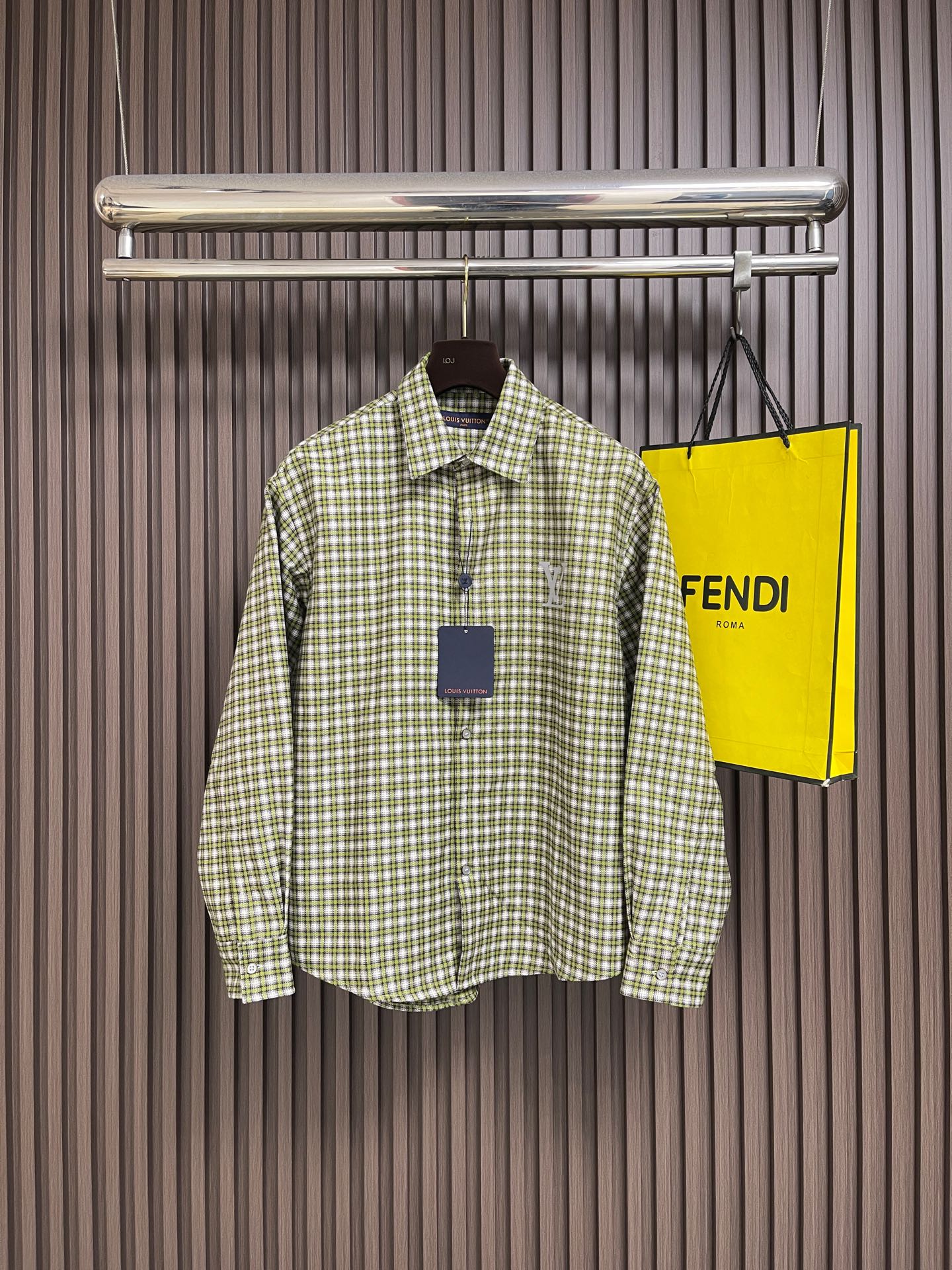 NO:950725,LV green plaid embossed LV logo long-sleeved shirt, retro green plaid pattern, front and rear brand logo design for full recognition, retro plaid pattern has its own high-end atmosphere, suitable for both casual and light business wear!  High-count custom-woven plaid cotton is selected. The fabric surface is smooth and delicate, breathable and skin-friendly. Special solid-color printing and dyeing technology makes the plaid color layered and not easy to fade and turn white after long-term washing. The classic green and white fine grid color is retro and durable, and can be worn casually in spring and autumn. It can be worn with a suit or inside in autumn and winter.  The layering has a strong sense of layering. Plaid fabrics have strict standards for cutting piece alignment. The placket, shoulder seam, and back plaid must be aligned horizontally and vertically. Misalignment directly destroys the overall texture; the metal LV pressure mark on the front chest is flat without bulges, and the large three-dimensional printing on the back is even and does not crack;  The lapel is double-layered and lock-stitched, and the collar is not easily deformed when washed. The fabric pre-shrinking and shaping process is complex, and the mass production process threshold is high. The buttons are made of customized accessories of the same brand, and the entire body of the body is evenly stitched. Check pattern alignment deviation, printing loss, and rough neckline routing  Ready-to-wear garments are directly screened, and strict quality control is carried out simultaneously. The loose-shouldered casual version hides the body fat without choosing the body shape and looks slimmer; the retro green checkered pattern is versatile and can be worn on the bottoms without choosing bottoms. It can be worn on the upper body for daily travel, commuting to work, and street wear. It is a light luxury checkered pattern that is highly wearable all year round!  Size S-XL Size S, length 72, shoulder width 51, bust 114, sleeve length 60, size M, length 74, shoulder width 53, bust 118, length of sleeve 61, size L, length 76, width 54, bust 122, length of sleeves 62, size XL, length 78, shoulder width 56, bust 126, length of sleeve 63,19860909LV 绿格压纹LV标识长袖衬衫,复古绿格纹,前后品牌标识设计辨识度拉满,复古格纹自带高级氛围感,休闲、轻商务穿搭都能驾驭！甄选高支定织格纹棉料,布面平整细腻,透气亲肤,特殊固色印染工艺,格纹色彩层次分明,久洗不易晕色发白；经典绿白细格配色复古耐看,春秋单穿随性,秋冬内搭西装、叠穿层次感极强.格纹面料对裁片对位标准严苛,门襟、肩缝、后背格纹必须横竖对齐,错位直接破坏整体质感；前胸金属LV压标平整无凸起,后背大号立体印花均匀不开裂；翻领双层包边锁缝,水洗不易翘领变形,面料预缩定型工序复杂,量产工艺门槛较高,纽扣统一品牌定制辅料,衣身全幅均匀包缝走线,格纹对位偏差、印花脱落、领口走线粗糙的成衣直接筛除,同步严苛品控,宽松落肩休闲版型,不挑身形藏肉显瘦；复古绿格百搭不挑下装,日常出行、通勤上班、街头穿搭均可上身,一年四季实穿度超高的轻奢格纹！尺码S-XL S码衣长72 肩宽51 胸围114 袖长60 M码 衣长74 肩宽53 胸围118 袖长61 L码衣长76 肩宽54 胸围122 袖长62 XL码 衣长78 肩宽56 胸围126 袖长63,,louis vuitton,shirts,business suit,,Men's clothing