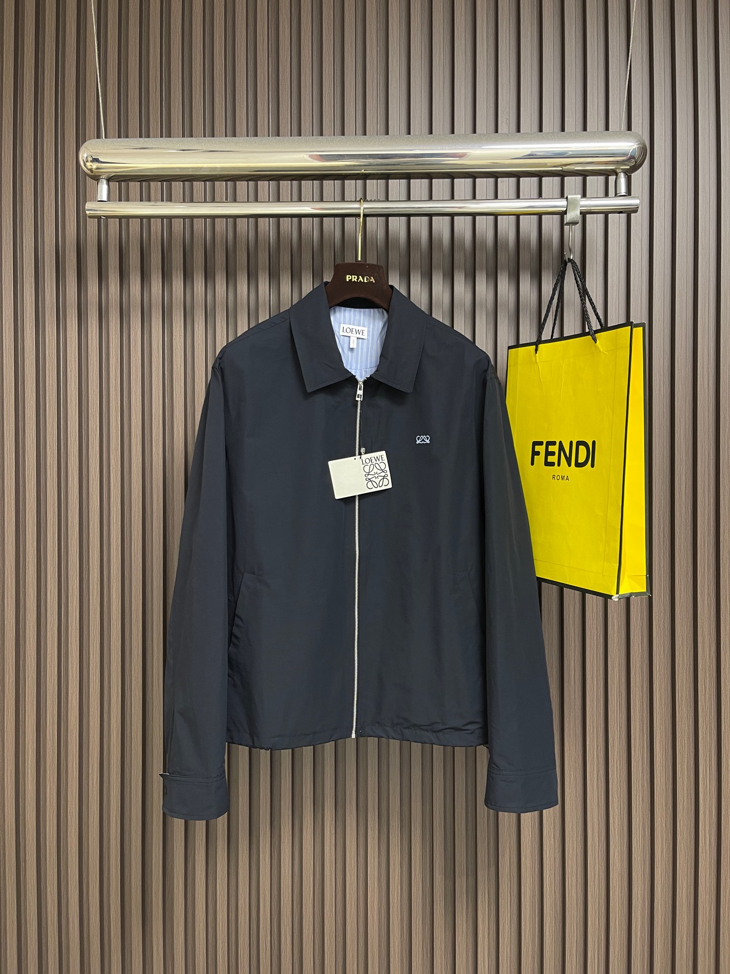 NO:950700,Loewe  The jacket is lined with embroidery and contrasting stripes. The body is made of 61 cotton + 39 nylon blended plain weave, which combines the dual advantages of natural cotton and nylon fiber. It has been pre-shrunk and matte soft after dual post-processing. The natural cotton fiber gives the fabric a delicate and soft skin-friendly touch, rich in breathable pores, and is not stuffy and sweaty for daily commuting; the high proportion of nylon yarn improves the fabric's anti-wrinkle and abrasion resistance, and is resistant to rubbing.  It is not easy to produce stubborn creases, and it is not easy to pill and wear after long-term wear. The interior is equipped with a linen + nylon blended interlining, which is made with high-definition digital direct-injection blue and white vertical stripe technology. The edges of the lines are clean and neat, without halo and blurred edges. The flax fiber has natural breathable and antibacterial properties, excellent heat dissipation, and avoids being stuffy and sticky to the skin. It is reinforced with nylon yarn to solve the shortcomings of pure linen that is easy to wrinkle and tear.  The interlining is light and smooth, with no friction when putting it on and taking off. It will not turn white or fall off after repeated washing, and there is no thick glue layer to block the ventilation holes, fully retaining the core advantages of the lining, which is breathable and skin-friendly. The chest embroidery adopts high-density embroidery technology, and the front piece accurately locates the embroidery area and fixes it with a positioning frame to prevent displacement during the sewing process and reduce fabric wrinkles caused by embroidery pulling. Light white high-tenacity embroidery thread is used, and more  Layer-by-layer dense turns are routed to fill the outline of the pattern; then encrypted lock stitching is done along the edge of the double L pattern. The lines are smooth and round, with no broken threads or skipped stitches, and the three-dimensional is full and not flat. The finished embroidery is smooth and compliant, with high recognition, and is not easy to get off-line or fluff when washed. The classic lapel-style flat lapel is sewn with two layers of fabric, with a full circle of open-stitched seams. The collar shape is durable and three-dimensional, and will not collapse or warp after long-term wear and washing. Sizes S-XL  Size S, length 67.5, bust 122, shoulder width 50, sleeve length 65, size M, length 69, bust 126, shoulder width 51, sleeve length 66, size L, length 70.5, bust 130, shoulder width 52, sleeve length 67, size XL, length 72, bust 134, shoulder width 53, sleeve length 68,,loewe,jackets & coats,jackets & coats,19860909Loewe 饰绣花撞色条纹内衬夹克外套,衣身采用61棉+39锦纶混纺平纹织造,融合天然棉料与锦纶纤维双重优势,经过预缩、哑光柔软双重后整处理.天然棉纤维赋予面料细腻柔和的亲肤触感,透气孔隙丰富,日常通勤穿着不闷汗；高占比锦纶丝提升面料抗皱、耐磨性能,揉搓后不易产生顽固折痕,久穿不易起球磨损.内里搭配亚麻+锦纶混纺衬布,采用高清数码直喷蓝白竖条纹工艺打造,纹路边缘干净利落,无晕色、无模糊毛边.亚麻纤维自带天然透气抑菌属性,散热性出众,避免闷身粘肤；搭配锦纶丝补强,解决纯亚麻易皱、易撕裂的短板,衬布轻薄顺滑,穿脱无摩擦阻滞,反复洗涤不会发白脱落,且无厚重胶层堵塞透气孔,完整保留内衬透气亲肤的核心优势.胸前刺绣采用高密度绣花工艺,前片精准定位刺绣区域,用定位框固定,防止缝制过程移位,降低刺绣拉扯导致的面料起皱,选用浅白色高韧度绣线,多层密匝走线填充图案轮廓；接着沿双L图案边缘做加密锁针,线条流畅圆润无断线、跳针,立体饱满不扁平；成品刺绣平整服帖,辨识度高,水洗不易脱线、起毛.经典翻领式平翻领双层布料复合缝制,整圈明线锁边,领型持久立体,久穿洗涤不塌陷、不起翘.尺码S-XL S码衣长67.5 胸围122 肩宽50 袖长65 M码 衣长69 胸围126 肩宽51 袖长66 L码衣长70.5 胸围130 肩宽52 袖长67 XL码 衣长72 胸围134 肩宽53 袖长68,,loewe,jackets & coats,jackets & coats,,Men's clothing