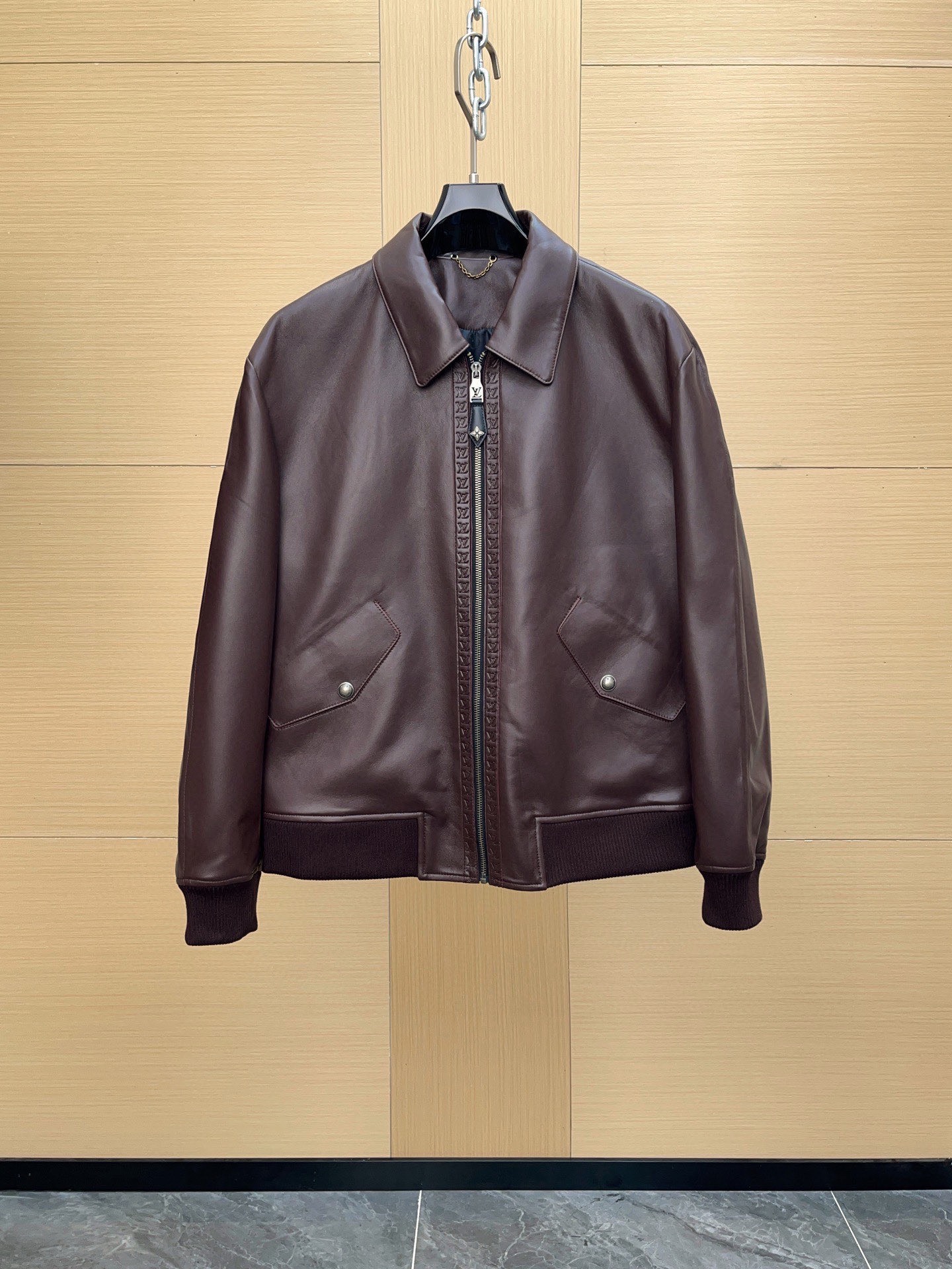 NO:701615,1V 2025 Autumn and Winter Men's Clothing Genuine Leather Bomber Jacket Leather Cow Leather Lined Monogram Flower Original Imported Single Product · Trading Company Order Channel Imported from Italy The first layer of cow leather is thick and compact, with clear natural pores on the surface, and a tough and tensile texture. Cow leather is famous for its toughness and wear resistance. The garments are crisp and stylish, and will not collapse easily after being worn for a long time. It also has a delicate feel and a stable texture, giving it a strong men's aura. The leather is processed with heavy craftsmanship and high difficulty. The cowhide is thicker during the trimming process, and cutting and splicing require high-tonnage presses and skilled craftsmen. The edges are trimmed and polished by hand, and the stitches are fine and firm, taking into account the crisp appearance and durability. Multiple processes are superimposed. The zipper is equipped with logo embossed trim (whole opposite grain). The surface of the cowhide presents a Monogram pattern, which is three-dimensional and uniform. It not only improves the visual level, but also avoids large-area wrinkles on the leather surface due to long-term use. Highly difficult to splice. The splicing parts are slightly distressed, and the edges are hand-finished and the stitching is reinforced to ensure stiffness and durability. The whole garment has both a straight silhouette and a retro charm. Accessory details: The hardware zipper adopts a custom-grade metal zipper, and the surface is treated with a retro brushing process to present a low-key matte texture. It is smooth and durable, and the zipper head is engraved with the logo. The zipper leather buckle is embossed with a four-petal flower pattern and is fixed with hand-stitching, taking into account both decoration and practicality. Rib webbing The hem, cuffs and collar are made of high-density knitted ribs, which are moderately tight and fit the body's movements, providing both comfort and shape retention. High-density fiber fabric is used, which is flexible and wear-resistant, breathable and warm. The lining is decorated with Monogram flowers and geometric textures Continuous quilting is 198609091V 2025秋冬男装 真皮飞行员夹克 皮料牛皮革 内衬Monogram 花卉 原厂进口单品 · 贸易公司订单渠道 意大利进口 头层牛皮革皮质厚实紧密,表层天然毛孔清晰,纹理硬朗而富有张力.牛皮以坚韧耐磨著称,成衣挺括有型,久穿不易塌陷,同时兼具细腻手感与沉稳质感,极具男装硬朗气场.皮革处理上采用重工艺高难度制作 ,植物鞣制 ,鞣制环节采用植鞣工艺,令皮革保持天然油脂 ,厚皮拼接 & 收边工序牛皮较厚,裁切与拼接需高吨位压机与熟练匠人操作,边缘经手工收边打磨,线迹细密牢固,兼顾挺括外形与穿着耐久度. 多重重工艺叠加 拉链配有标识压纹饰边（整条对纹） 牛皮表层呈现 Monogram 花纹,立体清晰且均匀,不仅提升视觉层次,还避免了皮面因长久使用而产生大面积褶皱.  高难度拼接 拼接部位采用微做旧处理,手工收边并加固缝线,确保挺括度与耐用性,整件成衣兼具挺拔轮廓与复古韵味. 辅料细节 五金拉链采用定制级金属拉链,表面经复古拉丝工艺处理,呈现低调哑光质感.顺滑耐用,拉链头刻印Logo.拉链皮扣加压浮雕四瓣花图案,结合手工缝线固定,兼顾装饰性与实用性. 罗纹织带 下摆、袖口与领口选用高密度针织罗纹,松紧适中,贴合人体动作,舒适度与保型性兼具采用高密度纤维织物,柔韧耐磨,透气性与保暖性兼具. 内衬以 Monogram 花卉与几何纹理 连续绗缝呈现,针脚紧密工整,线迹均匀,具有立体雕塑感.绗缝工艺不仅为装饰,更能固定内层填充,使衣身挺括有型,穿着时不易变形.防磨耐拉,细节处亦延续高定级别的严谨处理. 这款皮衣是 工艺与设计的双重标杆 —— 在经典飞行员夹克的廓形中,融入高级皮革的压纹与植鞣技术,真正诠释低调却无可替代的高端男装气场.,,jackets & coats,leather jacket,cowhide,Top Customize1,Men's clothing