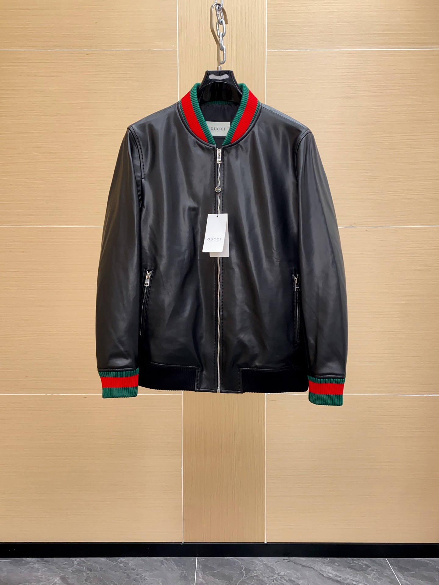 NO:754585,Gucci Nappa leather bomber jacket. Soft nappa leather + wool-cotton blended knit, texture and comfort. The outer layer is made of soft and delicate black nappa sheepskin. The leather texture is natural and delicate, smooth to the touch, and has both stiffness and flexibility. The surface gloss is even, showing a low-key and luxurious high-end texture. Knitting splicing process  The sleeves and back are made of wool and cotton blended knitted fabric, with dense stitching and high elasticity. While maintaining a comfortable wearing experience, it enhances the breathability and flexibility of the body. The three-dimensional straight slim fit bomber jacket has a straight shoulder line and a neat body shape. The splicing process naturally transitions to give both sporty and urban feel. The placket is equipped with a metal zipper, which is smooth and durable. The cuffs and hem are ribbed knitted and embellished with classic red and green webbing to highlight the iconic elements.  The lining is made of smooth spliced knitted fabric, which is smooth and comfortable to wear. It adds warmth and durability.,,gucci,gucci,jackets & coats,jackets & coats,sheepskin,Top Customize119860909Gucci古驰纳帕皮飞行员夹克外套 .柔软纳帕皮革 + 羊毛棉混纺针织,质感与舒适度 外层选用柔软细腻的黑色纳帕羊皮,皮质纹理自然细腻,触感顺滑,兼具挺括感与柔韧度.表面光泽均匀,展现低调奢华的高级质感. 针织拼接工艺 袖子与背部采用羊毛与棉混纺针织面料,针脚密实且富有弹性.在保持舒适穿着体验的同时,增强衣身的透气性与灵活性.立体剪裁版型直筒修身飞行员夹克版型,肩线挺括,身形利落.拼接工艺自然过渡 兼顾运动风与都市感. 门襟配备金属拉链,顺滑耐用. 袖口与下摆采用罗纹针织,并点缀 经典红绿织带,彰显标志性元素. 内里采用光滑里布拼接针织,穿着顺滑舒适.增添保暖性与耐穿性.,,gucci,gucci,jackets & coats,jackets & coats,sheepskin,Top Customize1,Men's clothing