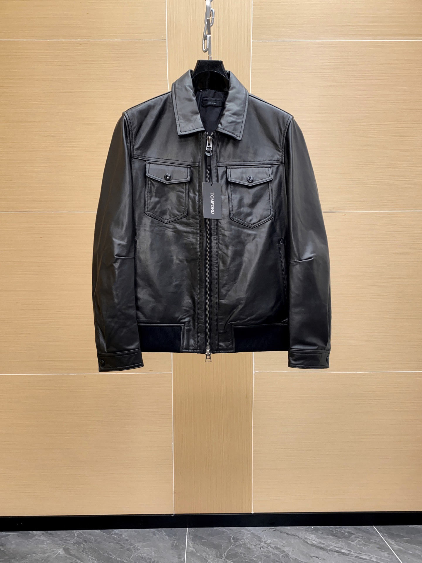 NO:754600,Tom Ford Men's Napa Leather Shirt Jacket continues the brand's consistent high luxury standards in terms of leather selection and craftsmanship details. Made of imported lambskin,  Tanned by the Napa process. This kind of leather is taken from young lambs. The fiber is fine and soft and feels extremely smooth. The Napa process can maintain the natural pores of the leather while making the surface more delicate and shiny. It is both light and flexible and has good wear resistance. It can stick to the body lines when worn, showing a sense of luxury and high comfort. The entire leather jacket is made of whole sheepskin to avoid the uneven feeling caused by redundant splicing; the leather surface is processed  Hand-polished and lightly coated for protection, it maintains the natural texture and has an antioxidant effect. Napa grain treatment The leather surface shows a low-key and delicate natural texture, showing an oily luster under different lights. Precision sewing technology Double-line seams are used on the edges to strengthen the structure and keep the lines simple and neat. Customized Tom Ford's latest original custom molded hardware zippers and snaps, matte silver texture, low-key but highly recognizable.  Each process needs to be completed manually by experienced craftsmen to ensure the crisp silhouette and precise details of the leather jacket.,,tom ford,jackets & coats,shirts,leather jacket,sheepskin,Top Customize119860909Tom Ford 男士纳帕纹皮革衬衫夹克 无论是皮料选择还是工艺细节,都延续了品牌一贯的高奢标准. 进口小羊皮打造,采用 纳帕工艺鞣制.这种皮料取自幼龄羔羊,纤维细密柔软,手感极其顺滑.纳帕工艺能在保持皮质天然毛孔的同时,让表面更细腻光泽,既有轻盈的柔韧性,又兼具良好的耐磨度.穿着时能紧贴身体线条,展现奢华感和极高的舒适度. 整件皮衣采用 整张羊皮拼裁,避免多余拼接带来的不平整感；皮面经过 手工打磨与轻薄涂层保护,保持自然纹理并兼具抗氧化效果. 纳帕纹处理 皮面展现出低调细腻的自然纹路,不同光线下呈现油润光泽. 精密缝制工艺 边缘处采用双线锁边,既加固结构又保持线条简洁利落. 定制 Tom Ford 最新原版定制开模五金拉链与按扣,哑光银色质感,低调却极具辨识度. 每一道工序都需经验丰富的工匠手工完成,保证皮衣挺括廓形和细节精度.,,tom ford,jackets & coats,shirts,leather jacket,sheepskin,Top Customize1,Men's clothing