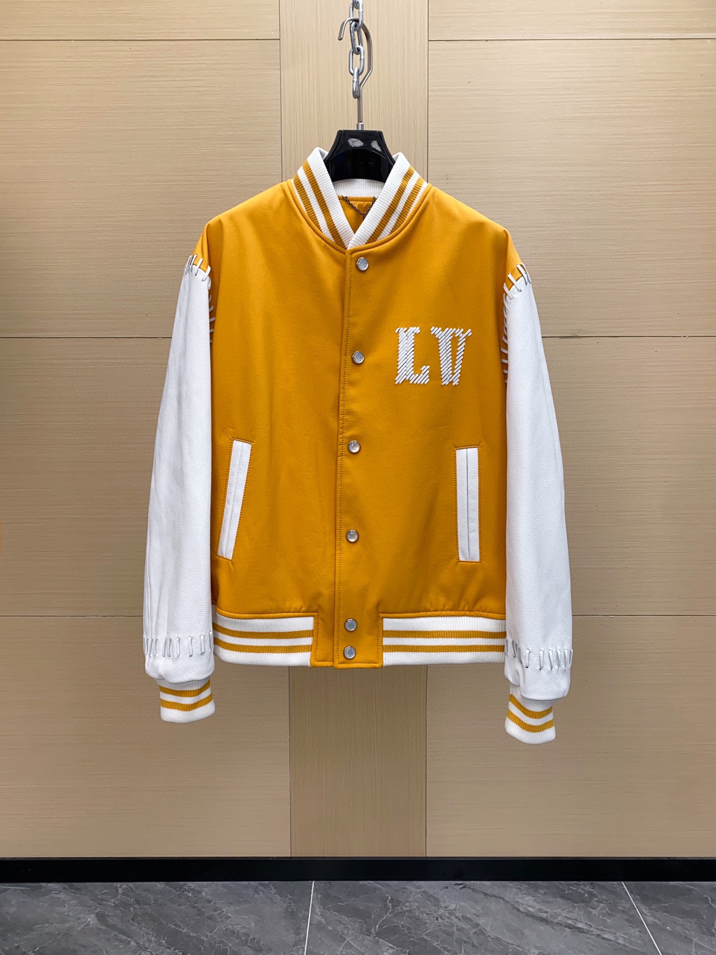 NO:754611,1V 25FW yellow embroidered strappy baseball tunic jacket. This baseball tunic jacket interprets the western theme of the 2025 autumn and winter show in bright colors. The technical body is paired with cow leather sleeves, and the slim leather straps are embroidered with the LV logo. The shoulders and cuffs are embellished with stitching details, and pearlescent snap buttons stretch the dandy style. The main fabric is cow leather;  Body 52 polyester fiber, 48 nylon; Rib 58 polyester fiber, 20 nylon, 19 cotton, 3 polyurethane fiber Lining 1 mulberry silk; Lining 2 cotton Size 46-56,, louis vuitton, jackets & coats, cowhide, Top Customize1198609091V 25FW 黄色刺绣绑带棒球束腰夹克 本款棒球束腰夹克以鲜明色调演绎 2025 秋冬秀场的西部主题.科技衣身搭配牛皮革衣袖,纤细皮革饰带刺绣 LV 标识.肩部和袖口点缀缝线细节,珠光按扣舒展丹迪风尚. 主面料牛皮革； 大身52聚酯纤维,48锦纶；罗纹58聚酯纤维,20锦纶,19棉,3聚氨酯纤维 内衬内衬1 桑蚕丝；内衬2 棉 尺码46-56,,louis vuitton,jackets & coats,cowhide,Top Customize1,Men's clothing