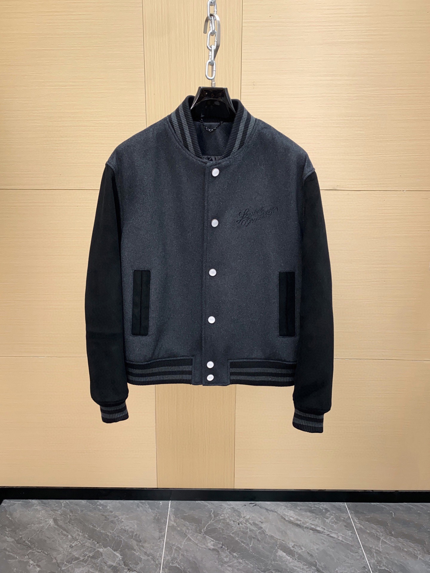 NO:772159,Ready for sale!  Louis Vuitton 2025 Autumn and Winter Baseball Jacket Made of leather sheepskin + sheep wool, lined with cupro fiber, large and high-count wool, which has undergone multiple milling compression and grinding processes to make the fiber structure tighter, making the finished product stiff and wear-resistant, while retaining the flexibility and warmth of natural wool. Sleeves Suede Sheep Leather  Imported first-layer sheepskin is selected, which is degreased, tanned, and sanded to form a fine velvet feel. This type of leather has extremely high cutting requirements, and the grain direction must be consistent to achieve a uniform and delicate visual effect after finished clothing. The Louis Vuitton handwritten logo on the chest is embroidered with high-density chain embroidery, and the stitches are arranged tightly and elastically, which not only maintains the three-dimensional sense of the pattern, but also resists loosening over time. Rib weaving  The collar, cuffs, and hem are all made of double-layer thread weaving technology and two-color parallel weaving, which ensures elasticity and anti-deformation performance, and will not loosen easily after long-term wear. Double-needle lock stitching is used for the splicing parts of wool and leather. The wiring is even and high-strength to ensure the tension balance between the fabrics and avoid the leather being pulled and deformed. Accessories and accessories Customized hardware buckle placket fasteners are specially molded to benchmark the original factory, with 1V embossing on both sides.  Logo, the surface has been electroplated and anti-oxidation treated to ensure gloss and durability. The inside of the pocket is covered with twill cloth to enhance durability and avoid deformation of the bag due to frequent use.,, louis vuitton,jackets & coats,sheepskin,Top Customize119860909现货发售！路易威登 2025秋冬棒球夹克 皮料羊皮革+绵羊毛 内衬铜氨纤维 大身高支数羊毛,经多道缩绒压缩与碾磨工艺,使纤维结构更加紧密,成品挺括耐磨,同时保留天然羊毛的柔韧与保暖性. 袖身绒面羊皮革 选用进口头层羊皮,经去脂、鞣制、磨砂打磨形成细腻绒感.此类皮革裁切要求极高,必须保证纹理方向一致,才能达到成衣后均匀细腻的视觉效果. 胸前路易威登手写体 Logo 采用高密度链式绣法,针脚排列紧密且富有弹性,不仅保持图案的立体感,同时经久不易松散. 罗纹织造 领口、袖口、下摆三处均采用双层螺纹机织工艺,双色并线织造,保证了弹性与抗变形性能,长久穿着不易松垮. 拼接走线羊毛呢与皮革的拼接部分使用双针锁缝,走线均匀且强度高,保证面料间的张力平衡,避免皮革拉扯变形. 辅料与配件 定制五金扣门襟扣件为对标原厂专属开模,正反双面均有1V压纹 Logo,表面经过电镀与防氧化处理,保证光泽与耐久度. 袋口工艺插袋内部覆以斜纹布衬,既提升耐用性,也避免因频繁使用导致袋口变形.,,louis vuitton,jackets & coats,sheepskin,Top Customize1,Men's clothing