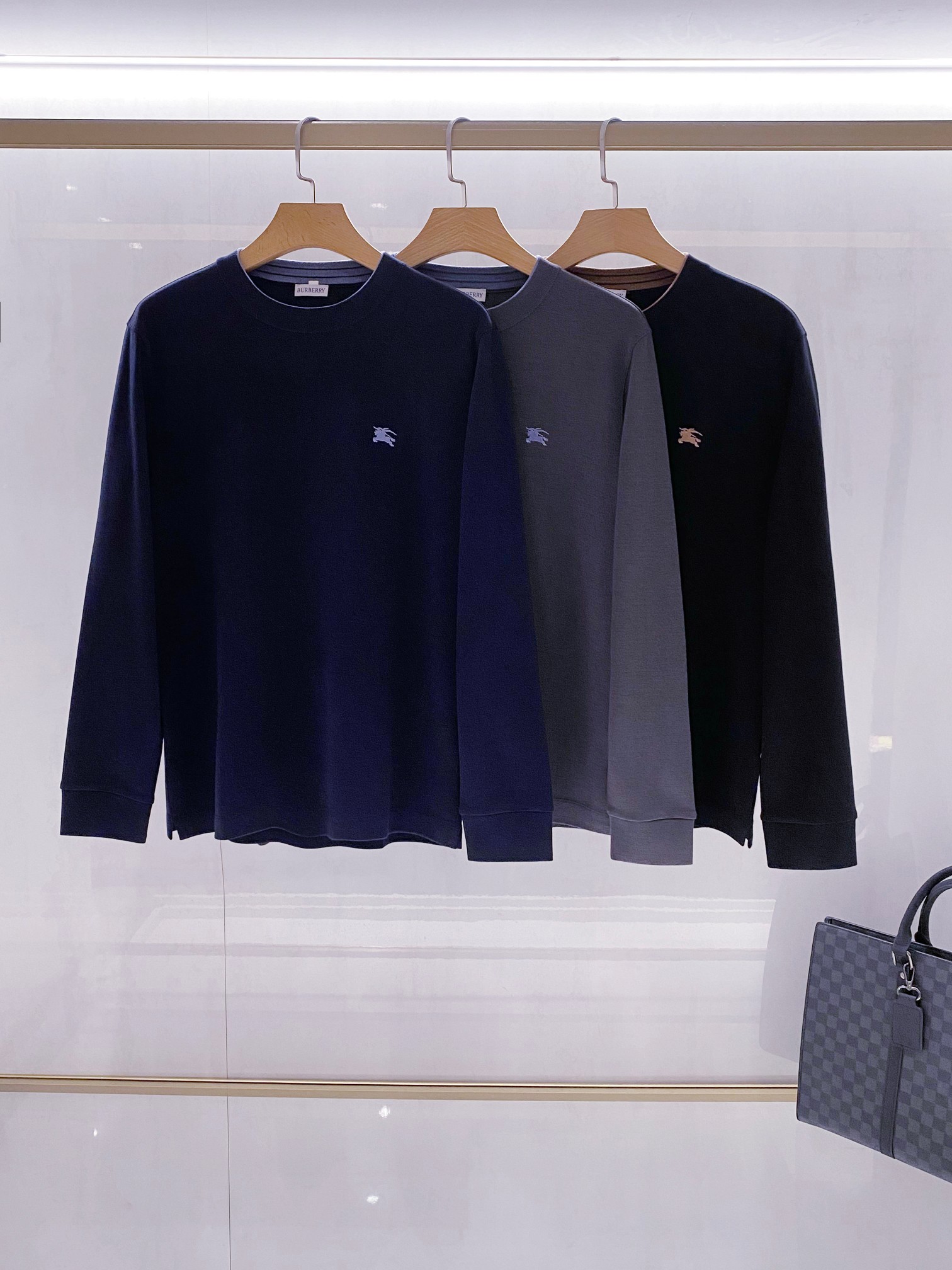 NO:596839,[BURBE*RY classic knitted series｜British style, weaving an elegant winter] Exclusive sale!  - Iconic design blends chivalry and modern aesthetics. Classic knight embroidery. Each sweater is decorated with the brand's iconic knight emblem on the left chest. The dark gray version has light blue embroidery, the navy version has dark blue embroidery, and the black version has warm brown embroidery. The delicate stitching outlines the galloping posture of the horse, showing exquisite craftsmanship.  The three-color aesthetic interprets the calmness of navy blue, the elegance of dark gray, and the classic black. They are all made of high-quality wool blended materials, with a fine knitted texture on the surface, which is soft and skin-friendly and has good warmth retention. The three-dimensional tailoring is simple and straight, suitable for a variety of body shapes, and the ribbed round neck outlines the elegant neckline. It can be worn alone or layered - the details bear witness to the luxurious quality. A white woven label is sewn on the inside of the neckline, clearly marked with the 'BURBERRY' brand logo, which forms an elegant contrast with the main color of the sweater!  The collar is treated with double-layer fabric. The navy model has a light blue inner collar, and the black model has a brown inner collar. The details reflect the color ingenuity - exquisite craftsmanship. The shoulder line and armholes are made of reinforced knitting to ensure that they will not deform after long-term wear!  The hem and cuffs have ribbed edges that are neat and crisp, maintaining a long-lasting and stable fit!  - Scenario-based outfit proposal. Pair a navy blue sweater with khaki trousers for business and casual occasions. The knight badge becomes the finishing touch, creating a low-key and refined business image!  For weekend leisure time, combine the dark gray style with jeans and match it with the dark gray plaid handbag in the lower right corner (Picture 1), which perfectly interprets the British casual aesthetics!  For an evening social gathering, wear a black sweater with a white shirt underneath, and the slightly exposed neckline adds a sense of layering, suitable for a variety of occasions between formal and casual!  Color: dark blue, black, gray Size: M-3XL, burberry, jeans, sweaters, shirts, alexander wang19860909【BURBE*RY 经典针织系列｜英伦格调,织就优雅冬日】独家销售！ - 标志性设计骑士精神与现代美学的交融 经典骑士刺绣每件毛衣左胸均饰以品牌标志性骑士徽章,深灰款配浅蓝刺绣、藏蓝款配深蓝刺绣、黑色款配暖棕刺绣,细腻针脚勾勒骏马奔腾姿态,展现精湛工艺 三色美学演绎藏蓝沉稳、深灰雅致、黑色经典,均采用优质羊毛混纺材质,表面呈现细腻针织纹理,兼顾柔软亲肤与良好保暖性 立体剪裁版型简约直身设计适配多种身形,罗纹圆领勾勒优雅颈线,单穿或内搭皆宜 - 细节见证奢华品质 领口内侧缝制白色织标,清晰标注'BURBERRY'品牌标识,与毛衣主色形成优雅对比！领部采用双层面料处理,藏蓝款配浅蓝内领、黑色款配棕内领,细节处体现色彩巧思 -精湛工艺处理 肩线与袖笼采用加固针织法,确保长久穿着不变形！ 下摆与袖口罗纹收边利落挺括,维持版型持久稳定！ -场景化穿搭提案 商务休闲场合藏蓝色毛衣搭配卡其色长裤,骑士徽章成为点睛之笔,塑造低调精致的商务形象！ 周末休闲时光深灰色款式与牛仔裤组合,搭配右下角深灰格纹手提包（图1）,完美诠释英伦休闲美学！ 晚间社交聚会黑色毛衣内搭白色衬衫,领口微露增添层次感,契合正式与休闲之间的多种场合！ 颜色:深蓝,黑色,灰色 码数:M-3XL,,burberry,jeans,sweaters,shirts,alexander wang,Men's clothing