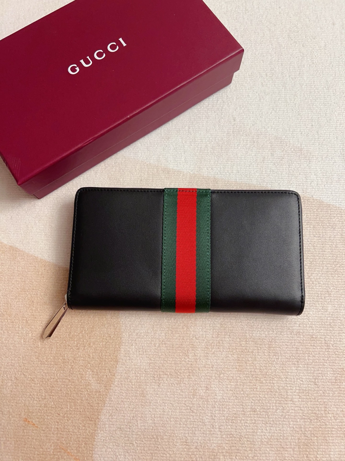 NO:813065,Newly launched in the 2026 spring and summer series, the new soft calfskin zipper wallet is a subtle interpretation of the brand's unremitting pursuit of high-quality materials. This piece is ingeniously embellished with new webbing details, integrating practical and versatile style, adding a refined style to the entire design. Black soft leather, silver-tone accessories, black taffeta lining, interior 12 credit card slots, 3 bill compartments and 1 zippered coin pocket. Zipper closure 19cm (width) x  10.5 cm (height) x 2.5 cm (depth) Model: 867284, color: leather, Gucci wallet, gucci, wallets, cowhide198609092026春夏系列全新上市全新柔软小牛皮拉链钱包单品精妙诠释品牌对优质材质的不懈追求这款单品匠心点缀焕然一新的织带细节,融蕴实用百搭风尚,令整个设计平添精致格调 黑色软皮 银色调配件 黑色塔夫绸衬里 内部12个信用卡槽,3个钞票隔层和1个拉链零钱袋 拉链封口 19厘米（宽）x 10.5厘米（高）x 2.5厘米（深） 型号: 867284,颜色: 克皮,Gucci钱包,gucci,wallets,cowhide,Wallet purse