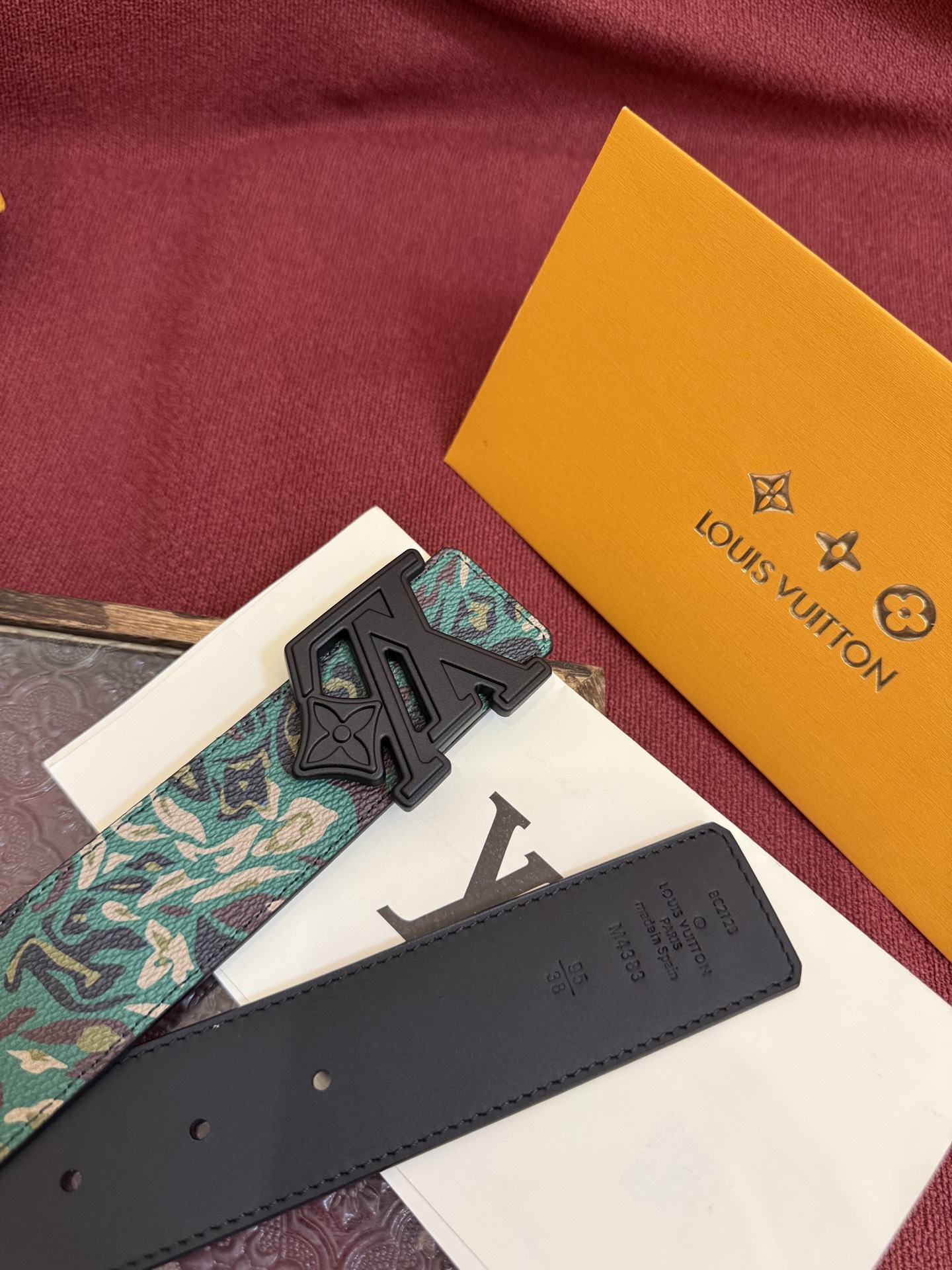 LV花卉迷彩40mm可翻转腰带是对户外爱好者长期青睐的男性主题的一次巧妙重新诠释。柔和的色调被转化为漩涡形状与品牌标识的融合。作为一款时尚优雅的替代品，反面的材质则是黑色皮革。带有花卉标识的银色扣子既适合前卫时尚的选择，也完全契合整体风格。P160