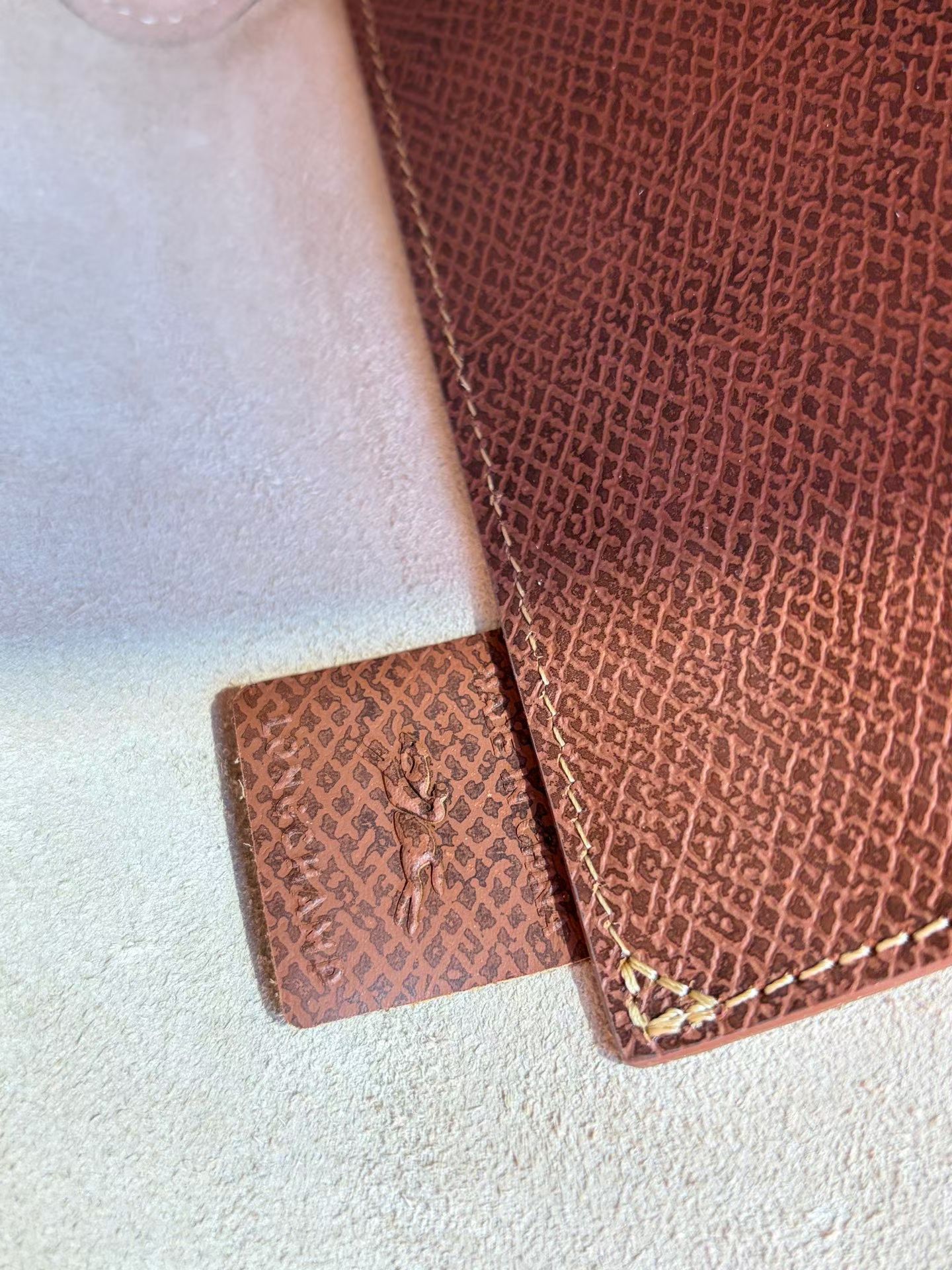 Longchamp The inside of the bag is suede, with an open design. There is no zipper compartment, just a compartment for cards, and interior label d