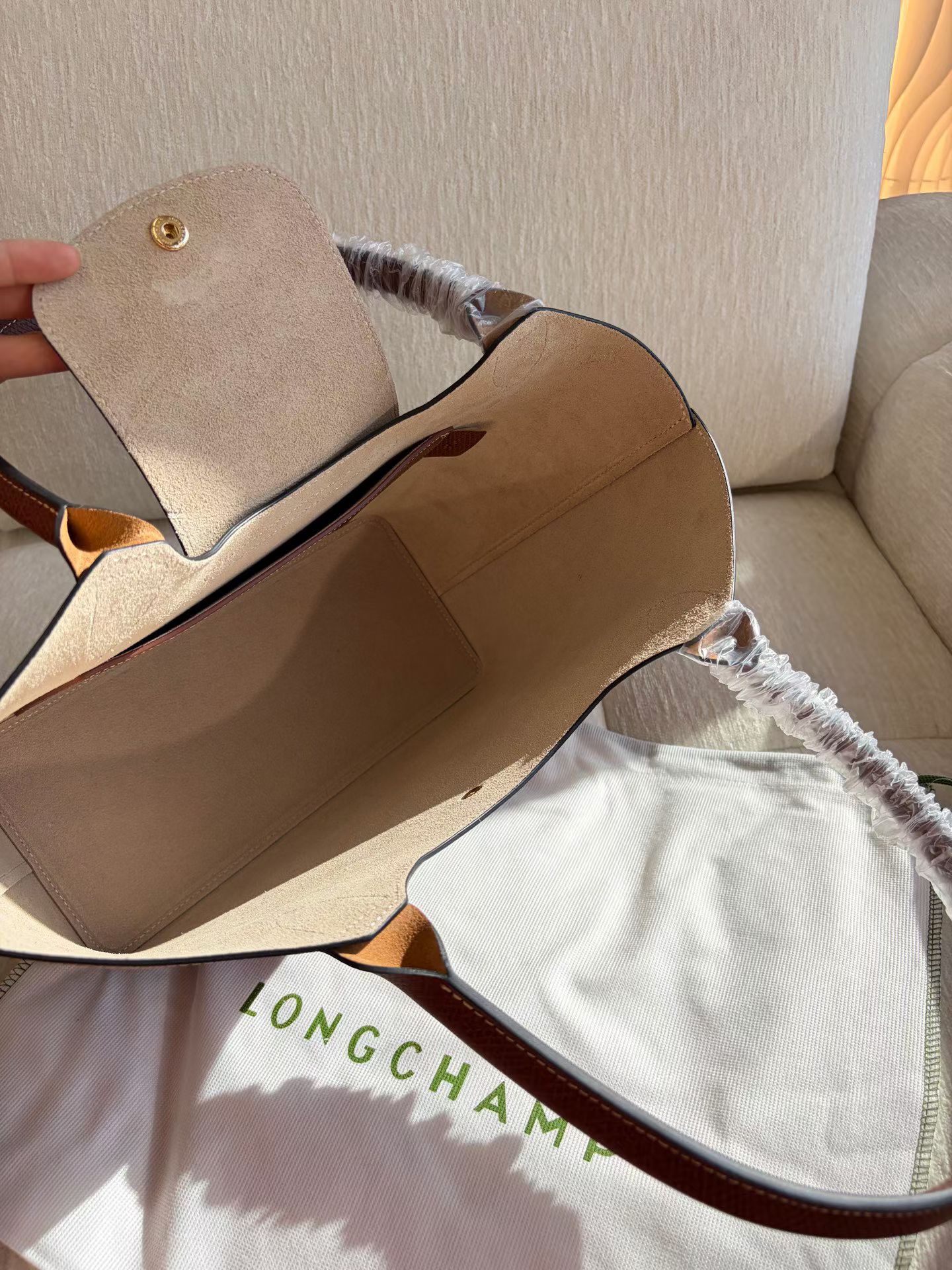 Longchamp The inside of the bag is suede, with an open design. There is no zipper compartment, just a compartment for cards, and interior label d