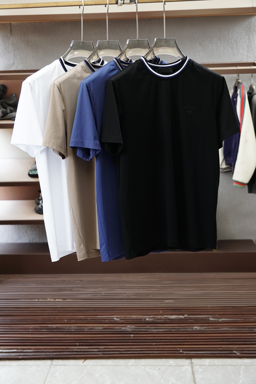 NO:945320,The new round neck Prada Prada and the 26 spring and summer new short-sleeved T-shirts reshape daily wear with minimalist aesthetics. The solid colors are clean and neat, and the round neck is decorated with contrasting edges. It is low-key and injects exquisite details to outline an elegant silhouette. Brand embroidery on the left chest  The embroidered logo is faintly visible, highlighting a low-key luxury texture. The fabric is made of high-count cotton blend, which is smooth and breathable to the touch. It drape naturally and fits the body shape without being tight, taking into account both comfort and style. The short sleeves are neatly cut, and the slightly arc design at the hem adds a casual atmosphere and is light.  It can be easily used in multiple scenes such as commuting, leisure, light socializing, etc. The overall style is simple but not simple. It is a versatile and durable 'basic ceiling' in the wardrobe. It is also an ideal choice for modern urbanites who pursue texture and relaxation. Without complicated decoration, one piece can brighten the spring and summer style and return daily wear to purity and high-end. M-4XL (model 173, 143 pounds upper body size L), prada, prada, T-shirt, tees, t-shirt,19860909新品圆领Prada普拉达、26春夏新品短袖T恤,以极简美学重塑日常穿搭.纯色干净利落,圆领处饰以撞色边线,低调中注入精致细节,勾勒出优雅轮廓.左胸处品牌刺绣标识若隐若现,彰显低调奢华质感.面料选用高支棉混纺,触感柔滑透气,垂坠自然,贴合身形却不紧绷,兼顾舒适与型格.短袖剪裁利落,下摆微弧设计增添随性气息,轻松驾驭通勤、休闲、轻社交等多重场景.整体风格简约而不简单,是衣橱中百搭耐看的“基础款天花板”,亦是现代都市人追求质感与松弛感的理想之选.无需繁复装饰,一件即能点亮春夏造型,让日常穿搭回归纯粹与高级.M-4XL（模特173,143斤上身L码）,,prada,prada,T-shirt,tees，t-shirt,,Men's clothing