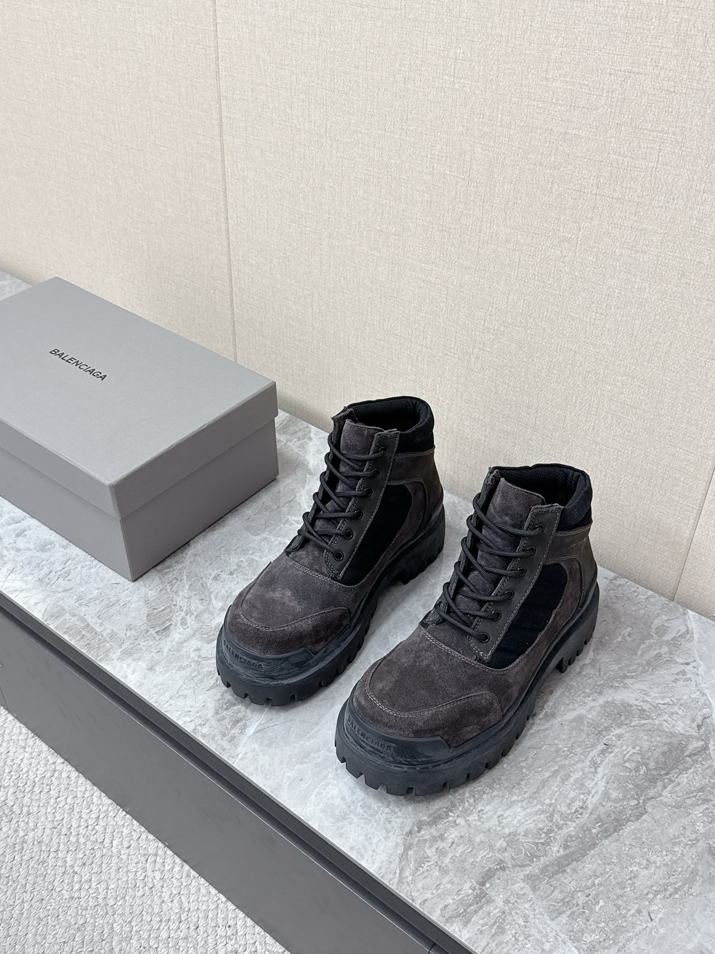 NO:781219,Balenciaga's latest couple's thick-soled high-top workwear Martin boots are popular with many celebrity internet celebrities. The upper is dark gray suede, with a retro texture and a distressed and worn effect, which fits the brand's wasteland style and high street aesthetics. The body of the shoe is spliced with black canvas/nylon quilted strips, and the mouth is edged with black fabric, which is rich in layers and improves the sense of ankle wrapping. The same color Balenciaga brand logo is printed on the side of the shoe, which is low-key and unobtrusive.  The short-tube high-top design is highly tolerant to leg shapes and is suitable for various styles such as Y2K, high street, workwear, mountain style, etc. The distressed craftsmanship gives each pair of shoes a unique retro texture, which is the core item to create the 'old money style' and 'waste style' look. The original molded outsole is 35-40 for women and 39-45 for men, balenciaga, balenciaga, boots, chamois leather19860909巴黎世家Balenciaga最新情侣款厚底高帮工装马丁靴 超多明星网红种草 鞋面深灰色反绒麂皮,质感复古做旧,自带做旧磨损效果,契合品牌的废土风、高街美学 鞋身拼接黑色帆布/尼龙绗缝条带,鞋口为黑色织物包边,层次丰富,同时提升了脚踝包裹感 鞋侧印有同色系Balenciaga品牌标识,低调不张扬 短筒高帮设计 对腿型包容度高,适配Y2K、高街、工装、山系等多种穿搭风格 做旧工艺让每双鞋都有独特的复古质感,是打造“老钱风”“废土风”造型的核心单品 原版开模大底码数女35-40 男39-45,,balenciaga,balenciaga,boots,chamois leather,Men's shoes