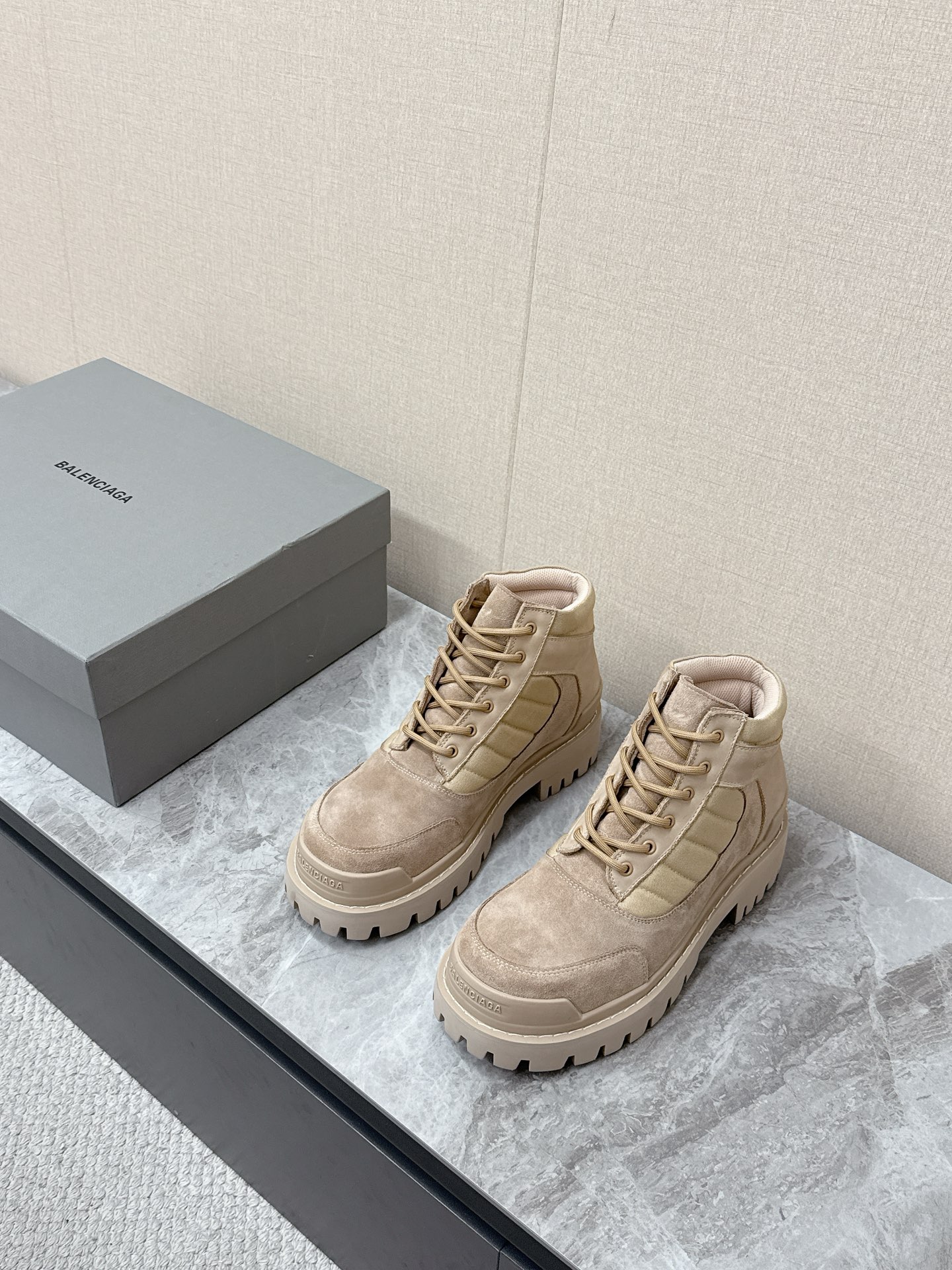 NO:781228,Balenciaga's latest couple's thick-soled high-top workwear Martin boots are popular with many celebrity internet celebrities. The upper is dark gray suede, with a retro texture and a distressed and worn effect, which fits the brand's wasteland style and high street aesthetics. The body of the shoe is spliced with black canvas/nylon quilted strips, and the mouth is edged with black fabric, which is rich in layers and improves the sense of ankle wrapping. The same color Balenciaga brand logo is printed on the side of the shoe, which is low-key and unobtrusive.  The short-tube high-top design is highly tolerant to leg shapes and is suitable for various styles such as Y2K, high street, workwear, mountain style, etc. The distressed craftsmanship gives each pair of shoes a unique retro texture, which is the core item to create the 'old money style' and 'waste style' look. The original molded outsole is 35-40 for women and 39-45 for men, balenciaga, balenciaga, boots, chamois leather19860909巴黎世家Balenciaga最新情侣款厚底高帮工装马丁靴 超多明星网红种草 鞋面深灰色反绒麂皮,质感复古做旧,自带做旧磨损效果,契合品牌的废土风、高街美学 鞋身拼接黑色帆布/尼龙绗缝条带,鞋口为黑色织物包边,层次丰富,同时提升了脚踝包裹感 鞋侧印有同色系Balenciaga品牌标识,低调不张扬 短筒高帮设计 对腿型包容度高,适配Y2K、高街、工装、山系等多种穿搭风格 做旧工艺让每双鞋都有独特的复古质感,是打造“老钱风”“废土风”造型的核心单品 原版开模大底码数女35-40 男39-45,,balenciaga,balenciaga,boots,chamois leather,Men's shoes