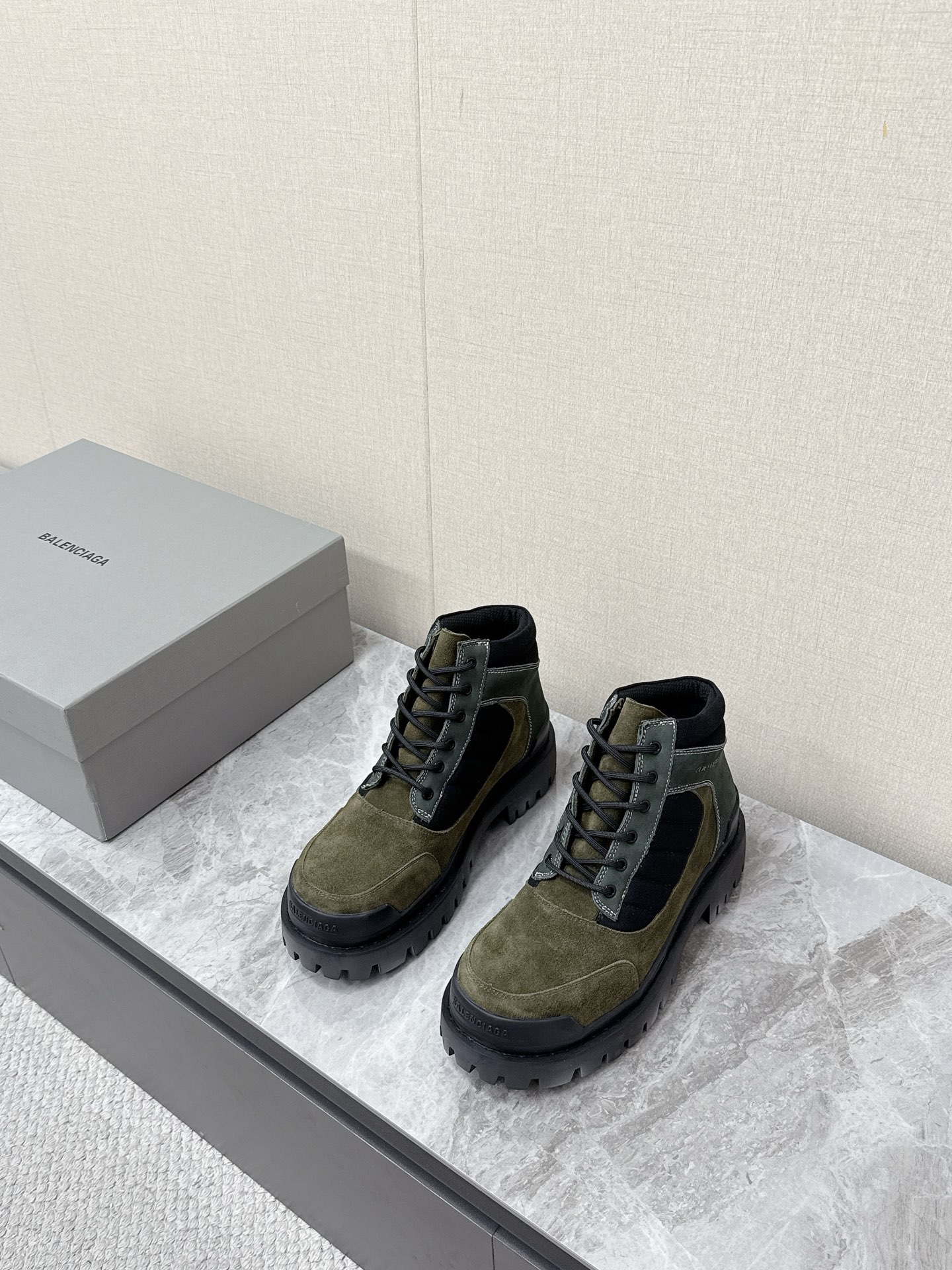 NO:898192,Balenciaga's latest couple's thick-soled high-top workwear Martin boots are popular with many celebrity internet celebrities. The upper is dark gray suede, with a retro texture and a distressed and worn effect, which fits the brand's wasteland style and high street aesthetics. The body of the shoe is spliced with black canvas/nylon quilted strips, and the mouth is edged with black fabric, which is rich in layers and improves the sense of ankle wrapping. The same color Balenciaga brand logo is printed on the side of the shoe, which is low-key and unobtrusive.  The short-tube high-top design is highly tolerant to leg shapes and is suitable for various styles such as Y2K, high street, workwear, mountain style, etc. The distressed craftsmanship gives each pair of shoes a unique retro texture, which is the core item to create the 'old money style' and 'waste style' look. The original molded outsole is 35-40 for women and 39-45 for men, balenciaga, balenciaga, boots, chamois leather19860909巴黎世家Balenciaga最新情侣款厚底高帮工装马丁靴 超多明星网红种草 鞋面深灰色反绒麂皮,质感复古做旧,自带做旧磨损效果,契合品牌的废土风、高街美学 鞋身拼接黑色帆布/尼龙绗缝条带,鞋口为黑色织物包边,层次丰富,同时提升了脚踝包裹感 鞋侧印有同色系Balenciaga品牌标识,低调不张扬 短筒高帮设计 对腿型包容度高,适配Y2K、高街、工装、山系等多种穿搭风格 做旧工艺让每双鞋都有独特的复古质感,是打造“老钱风”“废土风”造型的核心单品 原版开模大底码数女35-40 男39-45,,balenciaga,balenciaga,boots,chamois leather,Men's shoes