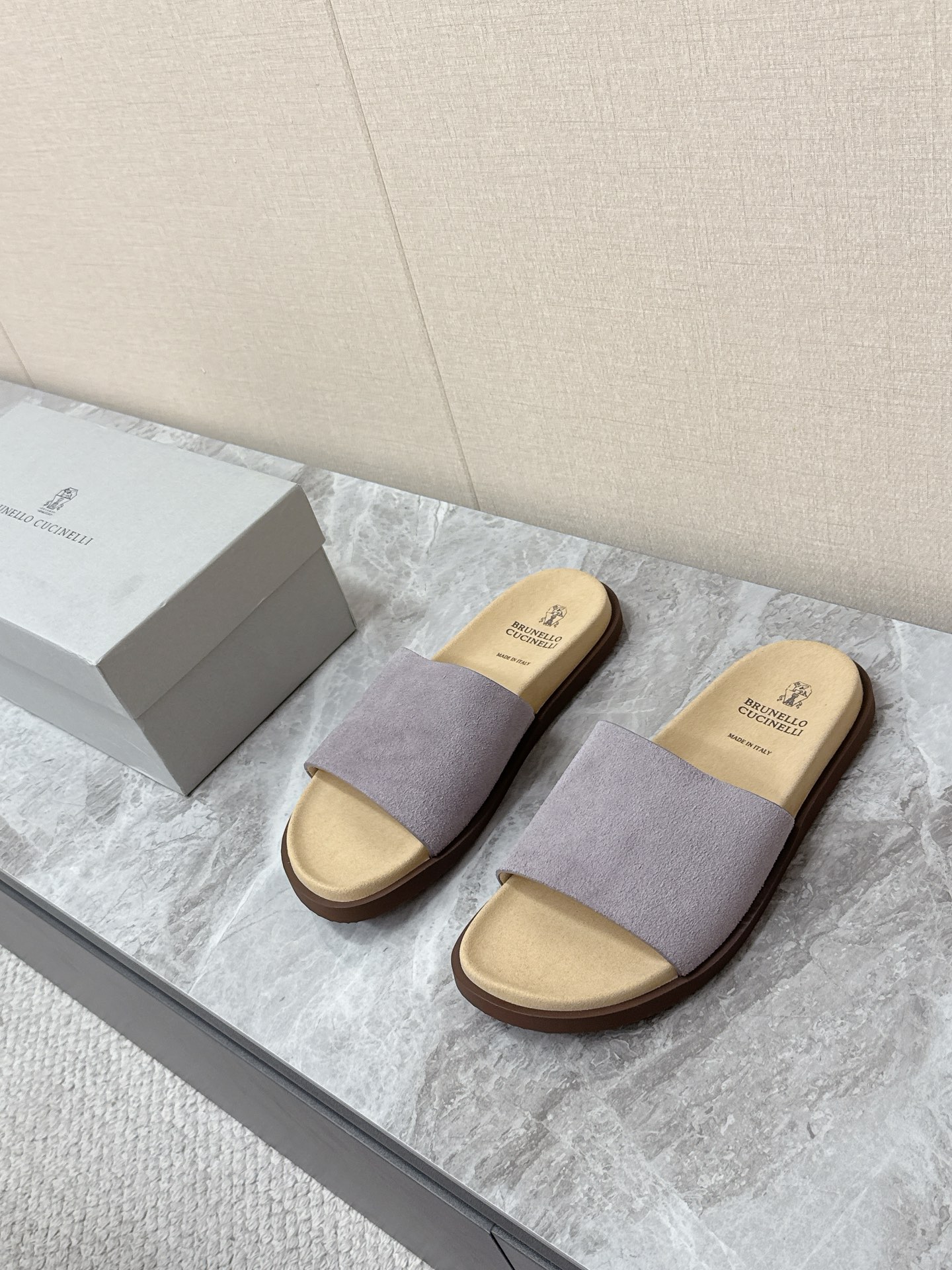 NO:851312,Brunello Cucinelli suede old-money style slip-on slippers. There are many celebrity Internet celebrities. Simple and retro 'Birkenstock style' style. The color scheme is mainly earth tones (dark brown, dark coffee, etc.). It is versatile and can be worn with casual shorts or linen shirts to create a resort style. It can also be worn with a relaxed feel for daily commuting. The upper is made of the brand's iconic washed suede material, which is soft and delicate to the touch.  It has a matte texture after special treatment. The footbed is soft leather of the same color and printed with the brand logo. The single wide shoelace design takes into account the convenience of putting on and taking off and the wrapping feeling of the foot. There is no unnecessary decoration. It perfectly interprets the brand's concept of 'low-key luxury'. Original molded non-slip outsole size 39-45, brunello cucinelli, slippers, shorts, shirts, chamois leather19860909Brunello Cucinelli布鲁奈罗·库奇内利 麂皮老钱风一字拖鞋 超多明星网红种草 简约复古的“勃肯风”造型 配色以大地色系为主（深棕、深咖等） 百搭不挑穿搭 既可以搭配休闲短裤 亚麻衬衫打造度假风造型 也能适配日常通勤的松弛感穿搭鞋面采用品牌标志性的水洗麂皮材质 触感柔软细腻 经过特殊处理后自带哑光质感 鞋床为同色系的软质皮革 印有品牌标识 单条宽面鞋带设计,兼顾了穿脱便捷性与脚面的包裹感,没有多余装饰 完美诠释了品牌“低调奢华”的理念原版开模防滑大底码数39-45,,brunello cucinelli,slippers,shorts,shirts,chamois leather,Men's shoes