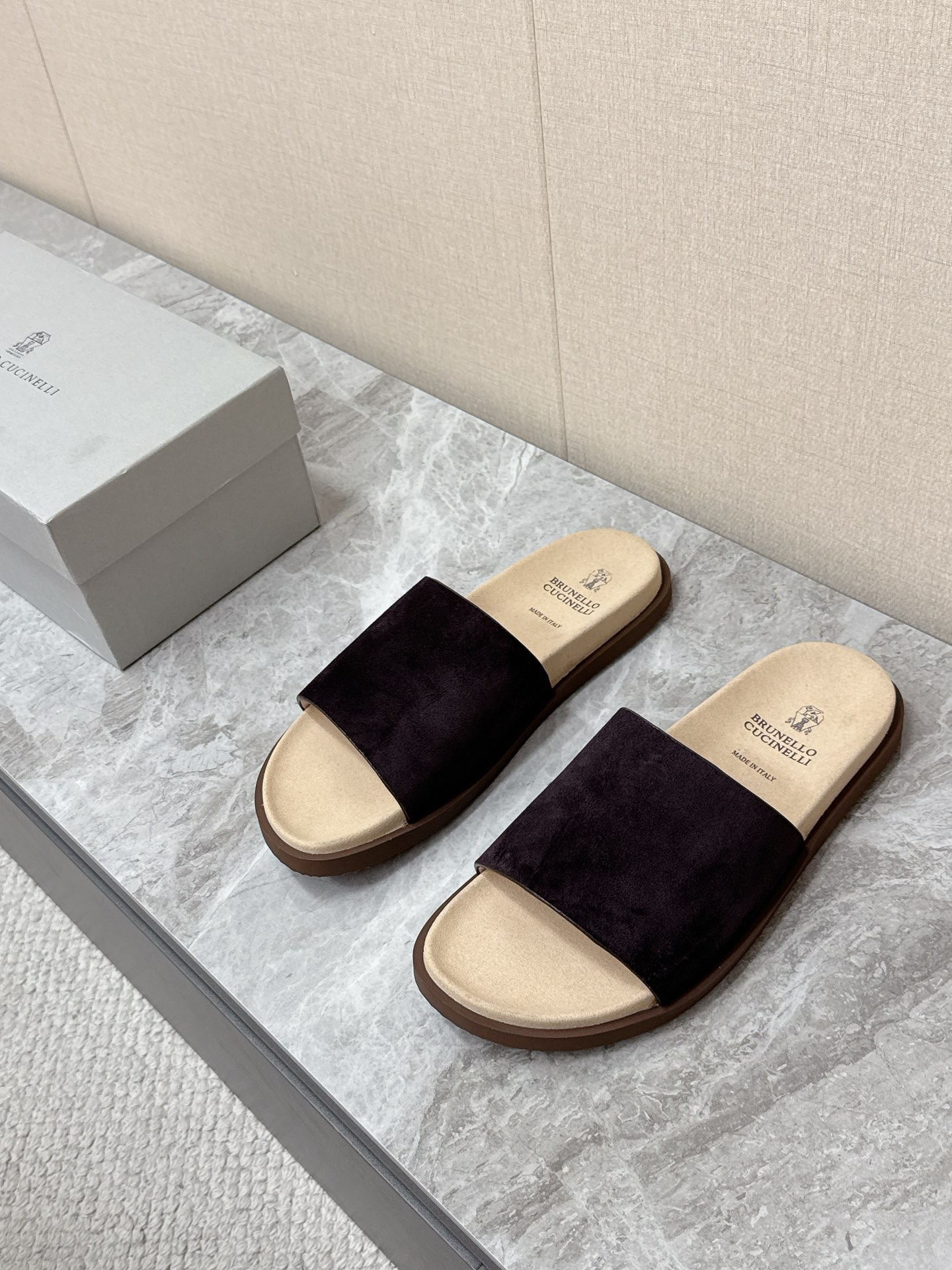 NO:889946,Brunello Cucinelli suede old-money style slip-on slippers. There are many celebrity Internet celebrities. Simple and retro 'Birkenstock style' style. The color scheme is mainly earth tones (dark brown, dark coffee, etc.). It is versatile and can be worn with casual shorts or linen shirts to create a resort style. It can also be worn with a relaxed feel for daily commuting. The upper is made of the brand's iconic washed suede material, which is soft and delicate to the touch.  It has a matte texture after special treatment. The footbed is soft leather of the same color and is printed with the brand logo. The single wide shoelace design takes into account the convenience of putting on and taking off and the wrapping feeling of the foot. There is no unnecessary decoration. It perfectly interprets the brand's concept of 'low-key luxury'. Original molded non-slip outsole size 39-45, slippers, brunello cucinelli, slippers, shorts, shirts, chamois leather19860909Brunello Cucinelli布鲁奈罗·库奇内利 麂皮老钱风一字拖鞋 超多明星网红种草 简约复古的“勃肯风”造型 配色以大地色系为主（深棕、深咖等） 百搭不挑穿搭 既可以搭配休闲短裤 亚麻衬衫打造度假风造型 也能适配日常通勤的松弛感穿搭鞋面采用品牌标志性的水洗麂皮材质 触感柔软细腻 经过特殊处理后自带哑光质感 鞋床为同色系的软质皮革 印有品牌标识 单条宽面鞋带设计,兼顾了穿脱便捷性与脚面的包裹感,没有多余装饰 完美诠释了品牌“低调奢华”的理念原版开模防滑大底码数39-45,拖鞋,brunello cucinelli,slippers,shorts,shirts,chamois leather,Women's Shoes