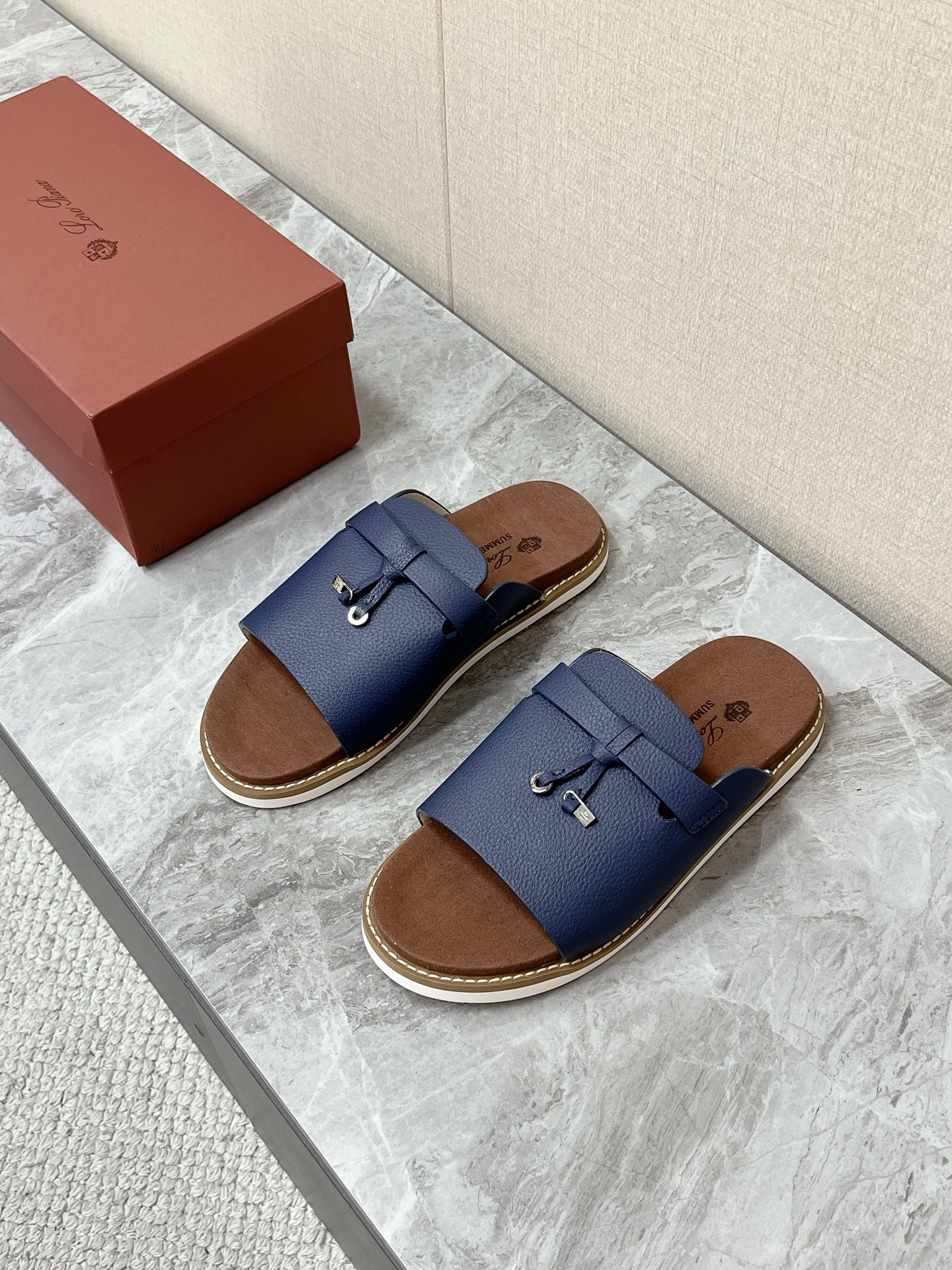 NO:889904,Loro Piana is the latest old-money casual slippers for spring and summer. Loro Piana Runway series of one-line casual slippers are the brand's iconic old-money style men's summer shoes. It focuses on light luxury and relaxed wear. Linen shorts, casual trousers, jeans, and vacation suits are suitable for minimalist luxury and old-money relaxed style. A single belt on the upper is matched with the brand's mini metal lock buckle. It is simple and not exaggerated. The core of brand recognition. The belt can be fine-tuned.  Suitable for different instep widths. Upper suede calfskin. Matte and delicate. Retro style. Original foam outsole. Size 39-46 (45 and 46 non-returnable). Slippers, loro piana, slippers, shorts, jeans, cowhide.19860909Loro Piana 诺悠翩雅春夏最新款老钱风休闲拖鞋 超多明星网红种草 Loro Piana Runway系列一字休闲凉拖 是品牌标志性老钱风男士夏日鞋款 主打轻奢松弛穿搭 亚麻短裤、休闲西裤、牛仔裤、度假套装,契合极简轻奢、老钱松弛风 鞋面单条皮带搭配品牌迷你金属锁扣 简约不浮夸 品牌辨识度核心 皮带可微调松紧 适配不同脚背宽度 鞋面牛反绒翻毛皮小牛皮 哑光细腻 复古格调突出 原版发泡大底码数39-46（45 46不退换）,拖鞋,loro piana,slippers,shorts,jeans,cowhide,Women's Shoes
