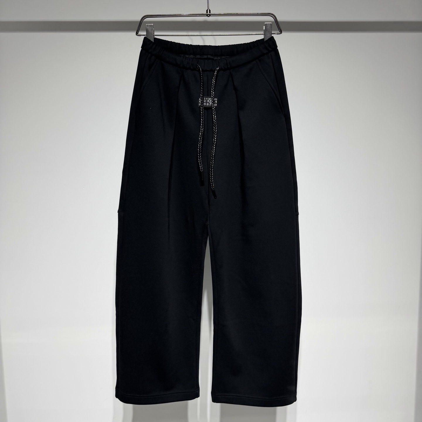NO:637563,Martin Margiela sports fashionable and casual pleated scimitar wide-leg pants, a fashionable out of the circle. The pleated design adds a sense of layering and highlights the exquisite details. The scimitar stitching on the back panel has a unique personality and can easily shape the leg lines. The wide-leg version is chic and casual, covering the flesh and showing the height. The fabric is comfortable, the texture is high, and it can be worn freely and without restraint. It is a versatile artifact, suitable for various tops and styles. The elastic waist drawstring design is adjustable!  The loose version is suitable for a wide range of people!  The craftsmanship is carefully crafted, the neat and clean style is simple, fashionable and versatile!  The fabric has been washed and is not easily deformed or shrunk, making it very interesting!  Can be worn alone or as an inner layer!  Versatile fashion trend!  Martin Margiela is like a god in the fashion world. The fabrics are soft and full of texture, and the loose silhouette is suitable for both men and women. It hides the designer’s endless imagination. The texture of the brand’s printed letters is visible to the naked eye. It has become popular with its deconstructionism, and the peak tradition returns to design!  Style No. Color Black Gray Size M-L-XL-XXL-XXXL L waist 38, hip 55, pants length 108. Refer to the L size data to choose the size that suits you!  ,menswear,masion margiela,alexander wang19860909Martin Margiela 马丁.马吉拉运动时尚休闲打褶弯刀阔腿裤,时尚出圈.打褶设计增添层次感,凸显精致细节.后幅弯刀拼接,独特个性,轻松塑造腿部线条.阔腿版型,潇洒随性,遮肉显高一流. 面料舒适,质感上乘,穿着自在无拘束.百搭神器,适配各种上衣与风格. 松紧腰头抽绳设计可调节！宽松版型适应人群丰富！工艺尽心打造,利落干净的版型 简约大气时尚百搭！ 面料做了水洗工艺不易变形缩水趣味十足！ 单穿内搭皆可！百搭时尚潮流！ 马丁马吉拉时尚圈神一般的存在 面料柔软质感拉满,廓形宽松剪裁版型男女通穿,隐藏着设计师无穷无尽的想象力,品牌印花字母肉眼可见的质感,以其解构主义火出圈,巅峰传统回归设计！ 款号 颜色 黑色 灰色 尺码 M-L-XL-XXL-XXXL L腰围38、臀围55、裤长108 参考L尺寸数据选择合适自己的尺码！,男装,masion margiela,alexander wang,Women's clothing