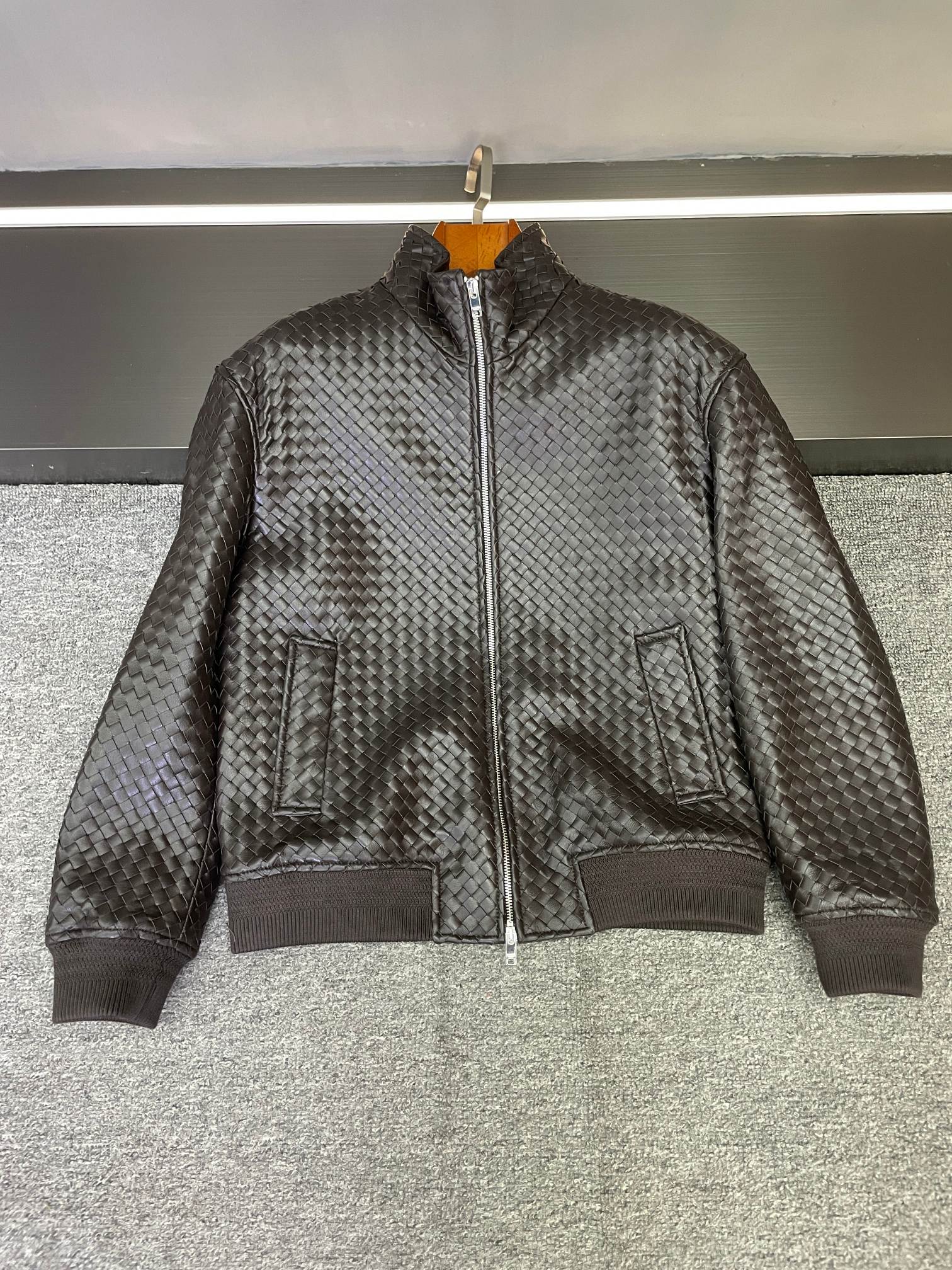 NO:674824,Bottega Veneta is the ultimate texture hit in autumn and winter. Bottega Veneta's 2025 autumn and winter men's new sheepskin jacket, just by seeing this dark coffee color imported from Australia, you know that it understands the sense of luxury.  The selected sheepskin has a warm luster, and the weaving process of the whole body is a stroke of genius - it is not a rigid splicing, but the leather presents a delicate and interlaced texture in the hands of the craftsman. From a distance, it is a low-key texture, but only when you look up close can you appreciate every inch of the craftsmanship. This kind of design that 'cannot see the logo but has its own aura' is exactly the most charming thing about Bottega Veneta.  The dark brown color has a retro accent. Whether it is paired with a knitted sweater of the same color to create a sense of layering, or worn with a simple white T to highlight the texture, it can be easily worn effortlessly and fashionably. A jacket that can be worn for many years and has a taste over time is probably this. 48-56,,bottega veneta,jackets & coats,sheepskin,Top Customize119860909葆蝶家,是秋冬最该有的质感暴击  葆蝶家2025秋冬男士新款羊皮夹克,光是看到这抹澳洲进口的深咖色,就知道是懂高级感的.  精选的羊皮自带温润光泽,而全身的编织工艺更是神来之笔——不是生硬的拼接,而是让皮革在匠人的手中呈现出细腻交错的纹理,远看是低调的肌理感,近看才能品出每一寸的匠心.这种“看不见logo却自带气场”的设计,恰恰是葆蝶家最迷人的地方.  深咖色自带复古腔调,无论是搭配同色系针织衫营造层次感,还是内搭简单白T凸显质感,都能轻松穿出不费力的时髦.一件能穿多年、越穿越有味道的夹克,大概就是这样了吧.  48-56,,bottega veneta,jackets & coats,sheepskin,Top Customize1,Men's clothing