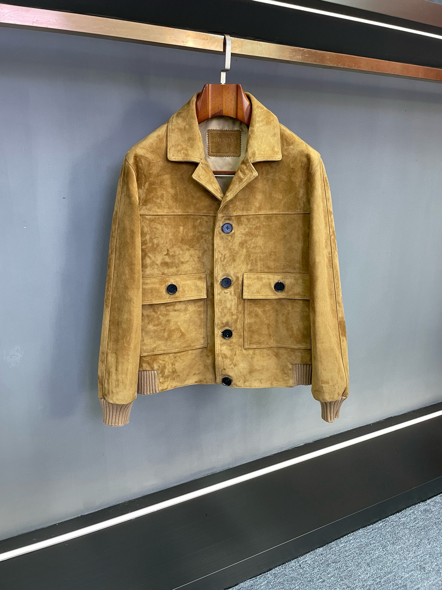 NO:674701,Prada's new autumn and winter men's suede sheepskin jacket is a classic interpretation of workwear style and luxurious texture. Prada's autumn and winter series presents another ingenuity. The new men's suede sheepskin jacket uses neat design and high-end materials to create an autumn and winter clothing choice for contemporary men with both practicality and aesthetic value.  This jacket is carefully sewn from suede sheepskin imported from New Zealand. The leather is delicate, soft and tough, with a warm and mellow touch, and has a retro texture and high-end luster. The two classic colors of brown and black are not only in line with the calm atmosphere of autumn and winter, but also have strong matching adaptability - brown contains retro warmth and shows an elegant style; black has a calm aura and can easily control various scenes.  The design incorporates the essence of workwear style. The small lapels of workwear are neat and stylish, which not only retains the cool temperament of workwear items, but also weakens the heavy feeling of traditional workwear, making it more light and flexible, and has good tolerance for different body shapes. The brand's ingenuity can be seen in the details. The Prada iconic triangle logo patch is embellished under the back collar. The simple lines outline the brand recognition. It is unobtrusive but full of luxury, and demonstrates extraordinary taste in details.  Whether it is a simple match for daily commuting or a casual style for casual occasions, this suede sheepskin jacket can be easily used. It is not only a core item to enhance the texture of the outfit, but also an ideal choice to interpret men's low-key style. It perfectly fits Prada's design concept of 'symbiosis of classics and practicality'. Size 48-56,,prada,prada,jackets & coats,sheepskin,Top Customize119860909Prada 普拉达秋冬新款男士反绒羊皮外套工装格调与奢华质感的经典演绎 普拉达秋冬系列再献匠心之作,全新男士反绒羊皮外套以利落设计与高端材质,为当代男士打造兼具实用性与美学价值的秋冬着装选择. 该外套甄选新西兰进口反绒羊皮精心缝制,皮质细腻柔软且富有韧性,触之温润醇厚,自带复古质感与高级光泽.推出的棕色与黑色两款经典色调,既契合秋冬季节的沉稳氛围,又具备极强的搭配适配性——棕色蕴含复古暖意,尽显优雅格调；黑色则自带沉稳气场,轻松驾驭多元场景. 设计上融入工装风格精髓,工装小翻领利落有型,既保留了工装单品的飒爽气质,又弱化了传统工装的厚重感,更显轻盈灵动,对不同身形具有良好包容性.细节处更见品牌巧思,后衣领下方缀以普拉达标志性三角标贴皮,简约线条勾勒品牌辨识度,不事张扬却尽显奢华底蕴,于细节处彰显不凡品味. 无论是日常通勤的简约搭配,还是休闲场合的自在造型,这款反绒羊皮外套皆能轻松胜任,既是提升穿搭质感的核心单品,也是诠释男士低调格调的理想之选,完美契合普拉达对“经典与实用共生”的设计理念. 码数 48-56,,prada,prada,jackets & coats,sheepskin,Top Customize1,Men's clothing