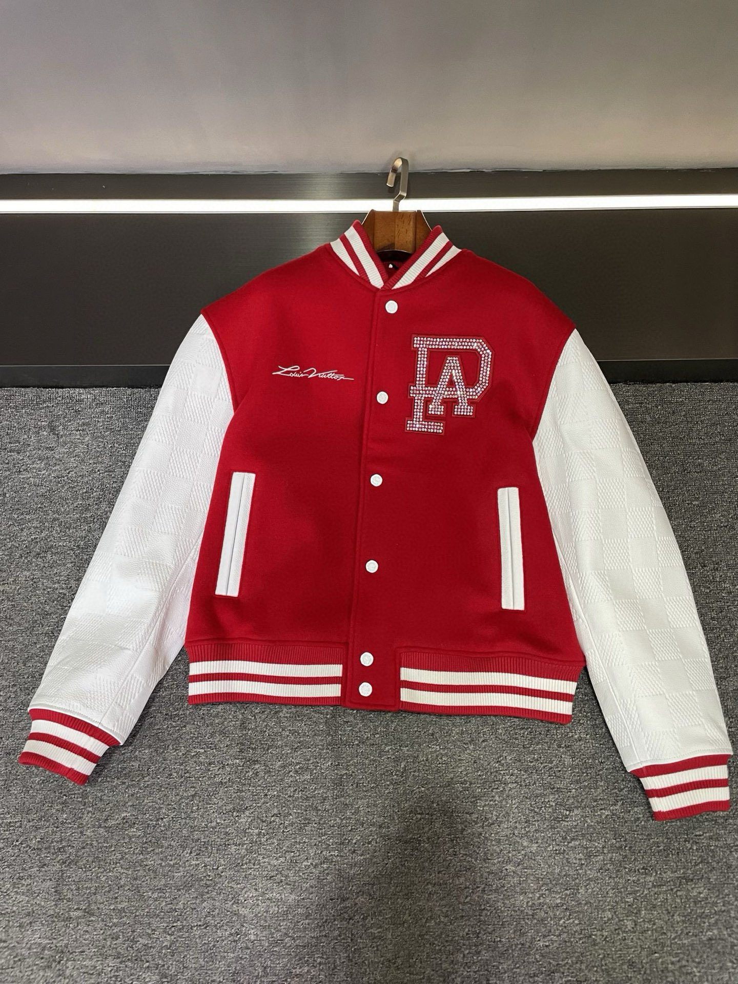 NO:675258,Tiled details of LV’s new 2025 autumn and winter men’s and women’s baseball uniforms!   The body part is made of bright red cashmere fabric, which is soft to the touch, bright in color, and full of high-end feel. The white sleeves are made of checkerboard embossed cowhide, which is fashionable and textured. The LOUIS VUITTON on the right chest is exquisitely embroidered, and the PA letters patterned into Swarovski rhinestones on the left chest are even more dazzling. Look at the back, where irregular-sized pearls are hand-strung and made of LOUIS VUITTON.  And brand logo, it is simply luxurious!   There are also red and white contrasting threaded collars and hems, and the details are full of exquisiteness. This baseball uniform from Lujia is really amazing, and friends who love fashion should not miss it!   Size XS-XXL,,louis vuitton,louis vuitton,louis vuitton,louis vuitton,cowhide,Top Customize119860909LV 2025 秋冬新款男女同款棒球服的平铺细节图展示！  身子部分用的是大红色羊绒面料,触感柔软,色泽鲜艳,满满的高级感.白色袖子是棋盘格压纹牛皮的,时尚又有质感.  右胸前的 LOUIS VUITTON 绣花精美绝伦,左胸施洛华水钻烫成的 PA 字母样式更是璀璨夺目.  再瞧瞧后背,不规则大小的珍珠手工串制成 LOUIS VUITTON 及品牌标识,简直奢华至极！  还有红白撞色螺纹领口及下摆,细节之处尽显精致.  驴家这款棒球服真的太惊艳啦,爱时尚的朋友们不容错过！  码数 XS-XXL,,louis vuitton,louis vuitton,louis vuitton,louis vuitton,cowhide,Top Customize1,Men's clothing