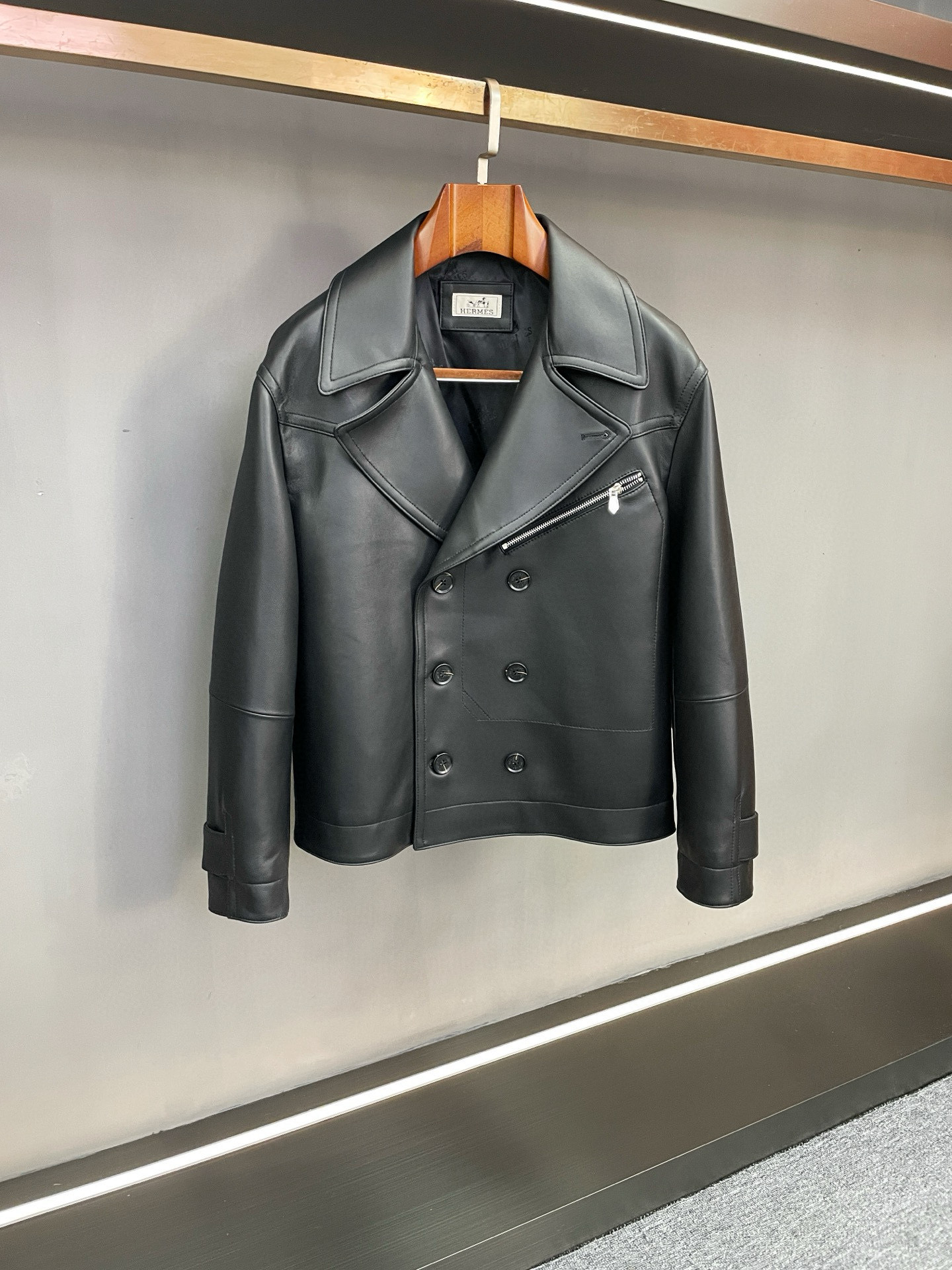 NO:675288,Hermes 2025 new autumn and winter men's sheepskin jacket is the ultimate interpretation of the classic silhouette and ingenious texture. The Hermes 2025 autumn and winter series presents new men's sheepskin jackets. With the brand's consistent exquisite craftsmanship and aesthetic concepts, it creates a must-have autumn and winter item for contemporary men that is both stylish and practical, interpreting the elegance and power of high-end men's clothing.  This jacket is carefully crafted from sheepskin imported from New Zealand. The leather is delicate and pliable, with a warm and mellow touch. It has a soft texture and a crisp silhouette. The two classic colors of black and gray are launched, which are in line with the calm atmosphere of autumn and winter, while still being versatile - black has a deep aura, highlighting low-key luxury; gray has an elegant style, interprets calm taste, and meets the dressing needs of different occasions.  The design combines classic and modern, using a neat flight jacket shape with smooth and elegant lines, showing a tall and straight figure on the upper body; the large open collar design extends the neck line, adding a casual and free feeling; the double-breasted elements are infused with retro charm, which is both decorative and practical.  , windproof and warm when fastened, and more layered when open. The details are even more ingenious. The iconic Hermès logo jacquard craftsmanship is used on the inside. The exquisite texture revealed when the plack is opened, highlights the brand recognition in the details, and shows the extraordinary style in a low-key manner.  Whether it is daily commuting or leisure travel, this sheepskin jacket can be easily controlled. It can be paired with casual pants for a casual and elegant look, or with trousers for an elegant business style. Hermès has accumulated a century of craftsmanship and perfectly integrated materials, styles and details to bring functional and aesthetic clothing options to men who pursue quality, showing the ultimate charm of high-end men's clothing. Size M-3XL,,hermes,hermes,jackets & coats,jackets &  coats,sheepskin,Top Customize119860909Hermes 爱马仕2025秋冬新款男士羊皮外套经典廓形与匠心质感的极致演绎 Hermes2025秋冬系列重磅呈现男士羊皮外套新作,以品牌一贯的精湛工艺与美学理念,为当代男士打造兼具格调与实用的秋冬必备单品,诠释高端男装的优雅与力量感. 该款外套甄选新西兰进口羊皮悉心打造,皮质细腻柔韧,触感温润醇厚,兼具柔软质感与挺括廓形.推出的黑色与灰色两大经典色系,既符合秋冬的沉稳氛围,又不失百搭属性——黑色自带深邃气场,彰显低调奢华；灰色则透着雅致格调,诠释从容品味,满足不同场合的穿搭需求. 设计上融合经典与现代,采用利落的飞行夹克版型,线条流畅大气,上身尽显挺拔身形；大开领设计延伸颈部线条,增添随性洒脱之感；双排扣元素则注入复古韵味,兼具装饰性与实用性,扣合时防风保暖,敞开时更显层次感.细节之处更见匠心,内里采用爱马仕标志性Logo提花工艺,翻开衣襟时露出的精致纹路,于细节处彰显品牌辨识度,尽显低调中的不凡格调. 无论是日常通勤还是休闲出行,这款羊皮外套都能轻松驾驭,可搭配休闲裤演绎随性洒脱,亦可搭配西裤展现儒雅商务风范.爱马仕以百年工艺积淀,将材质、版型与细节完美融合,为追求品质的男士带来兼具功能性与美学价值的着装选择,尽显高端男装的极致魅力. 码数M-3XL,,hermes,hermes,jackets & coats,jackets & coats,sheepskin,Top Customize1,Men's clothing