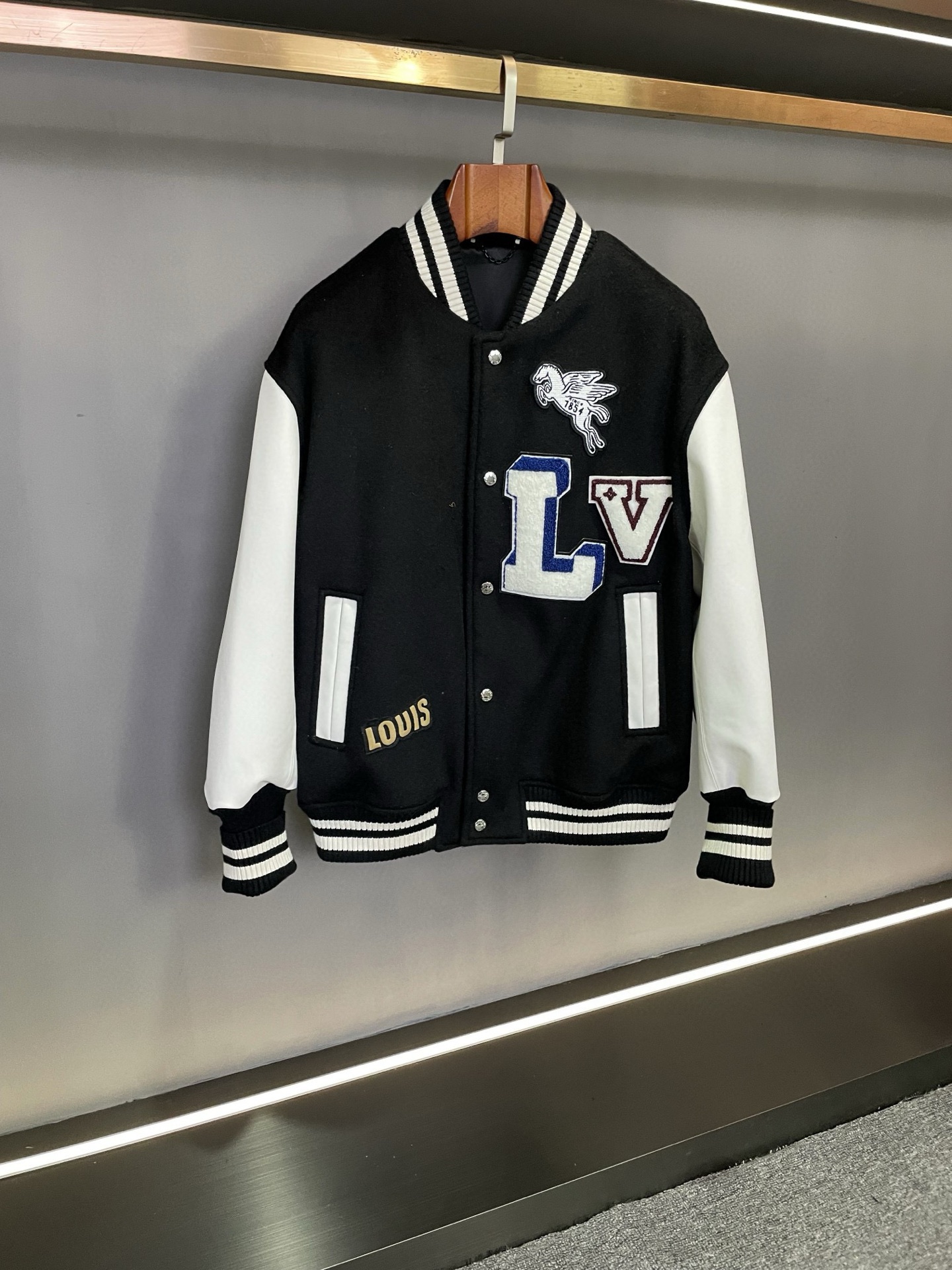 NO:675281,Louis Vuitton's LV 25 new autumn and winter men's and women's cowhide stitching baseball jersey. This baseball jersey is luxurious and fashionable in design and material selection. The body part is made of black cashmere fabric imported from Australia, which is soft and delicate, giving people the ultimate comfort. The khaki color is warm and elegant, which is suitable for the atmosphere of autumn and winter, and can be easily matched with various clothing.  The sleeves are made of first-layer white calfskin imported from Spain, which is of high quality. The white calfskin and the khaki cashmere fabric form a sharp contrast, creating a unique fashion spark. This stitching design of cowhide and cashmere not only gives people a strong visual impact, but also reflects the brand’s persistent pursuit of quality. The towel embroidery on the chest is even more exquisite, delicately depicting the LV brand.  The LOGO highlights the nobility and uniqueness of the brand. The contrasting thread design of khaki and white adds a sense of vitality and fashion to the whole. In addition, the LV classic five-pattern leather decoration on the cuffs is the finishing touch. This detail not only shows the classic elements of the brand, but also highlights the sophistication and luxury of this baseball uniform. Louis Vuitton  The new 2025 autumn and winter men's and women's cowhide stitching baseball uniforms are classics in terms of material selection and design ingenuity. It is not only suitable for men to show handsomeness and stability, but also allows women to exude elegance and fashionable charm. Whether it is daily travel or attending important occasions, this baseball uniform can be your best choice. Size 44-54.,, louis vuitton, louis vuitton, cowhide, Top Customize19860909路易威登 LV 25秋冬新款男女同款牛皮拼接棒球服.  这款棒球服在设计与材质的选择上尽显奢华与时尚.身子部分采用澳洲进口黑色羊绒面料,柔软细腻,给人以极致的舒适感受.卡其色的色调温暖而优雅,既适合秋冬季节的氛围,又能轻松搭配各种服饰.  袖子则采用西班牙进口头层白色小牛皮,质感上乘,白色的小牛皮与卡其色的羊绒面料形成鲜明对比,碰撞出独特的时尚火花.这种牛皮与羊绒的拼接设计,不仅在视觉上给人以强烈的冲击,更体现了品牌对品质的执着追求.  胸前的毛巾绣工艺更是精妙绝伦,细腻地刻画出 LV 品牌 LOGO,彰显着品牌的尊贵与独特.而卡其色与白色的撞色螺纹设计,为整体增添了一份活力与时尚感.  此外,袖口处的 LV 经典五花皮革装饰,更是点睛之笔.这一细节不仅展现了品牌的经典元素,更凸显了这款棒球服的精致与奢华.  路易威登 2025秋冬新款男女同款牛皮拼接棒球服,无论是从材质的选择还是设计的巧思,都堪称经典之作.它既适合男性展现帅气与稳重,又能让女性散发优雅与时尚的魅力.无论是日常出行还是参加重要场合,这款棒球服都能成为你的最佳选择.  码数44-54.,,louis vuitton,louis vuitton,cowhide,Top Customize1,Men's clothing