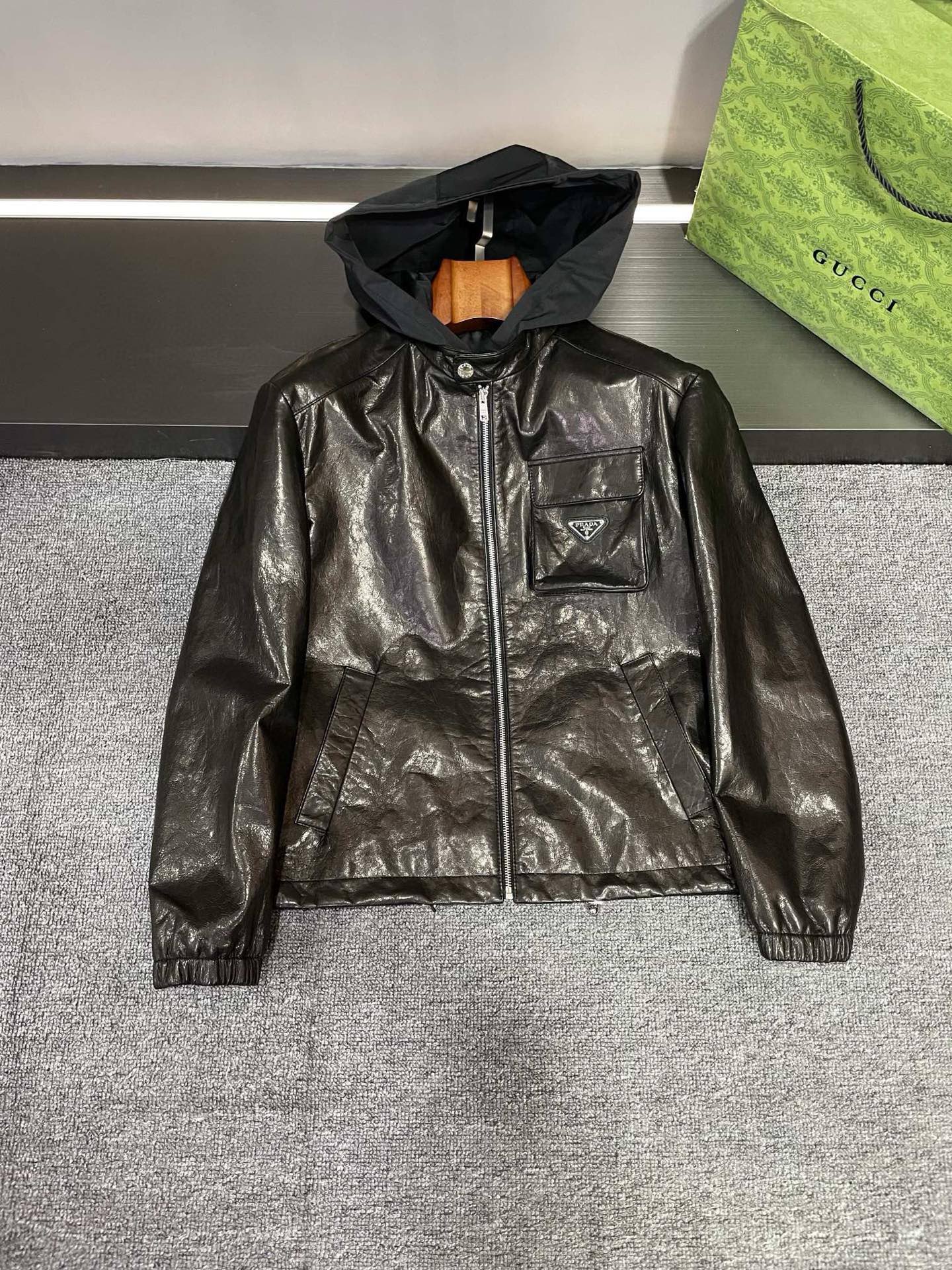 NO:895037,PRADA 25 new autumn and winter new men's sheepskin leather jacket flat lay details Prada's leather jacket is carefully crafted from black sheepskin imported from Australia. The texture is invincible and every detail demonstrates luxury quality. Wearing it will instantly make you look 2.8 meters tall. Whether it is a business occasion or leisure time, you can easily control it and make you the center of attention.  And oh, it also has a super thoughtful design, spliced with a detachable polyester fiber hat. This hat not only adds a sense of fashion to the overall look, but can be disassembled at will according to different occasions and moods, which is very practical. Look at the three-dimensional flap pocket on the chest, which is full of design, not only increases practicality, but also adds a lot to the overall shape. The embellishment of PRADA's iconic triangle logo on the pocket is the finishing touch, instantly improving the recognition and fashion sense of the entire leather jacket.  Prada has always been a leader in the fashion industry, and this new 25 autumn and winter men's sheepskin leather jacket perfectly combines the brand's exquisite craftsmanship and fashionable design. If you are looking for a fashionable and practical autumn and winter jacket for yourself or your loved one, then this leather jacket is definitely your best choice. Size 48-56,, prada, prada, jackets & coats, leather jacket, sheepskin, hats, Top Customize119860909PRADA 普拉达25 秋冬新款男士羊皮皮衣平铺细节图  Prada这款皮衣采用澳洲进口黑色羊皮精心打造,质感无敌,每一处细节都彰显着奢华品质.穿上它,瞬间气场两米八,无论是商务场合还是休闲时光,都能轻松驾驭,让你成为众人瞩目的焦点.  而且哦,它还有一个超贴心的设计,拼接了可拆卸的聚酯纤维帽子.这个帽子不仅为整体造型增添了时尚感,还能根据不同的场合和心情随意拆卸,实用性满分.  再看看胸前的立体揭盖口袋,设计感十足,既增加了实用性,又为整体造型加分不少.而口袋上 PRADA 标志性的三角标 LOGO 点缀,更是画龙点睛之笔,瞬间提升了整个皮衣的辨识度和时尚感.  Prada 一直以来都是时尚界的翘楚,这款 25秋冬新款男士羊皮皮衣更是将品牌的精湛工艺和时尚设计完美结合.如果你正在为自己或者为心爱的他寻找一款既时尚又实用的秋冬外套,那么这款皮衣绝对是你的不二之选.  码数 48-56,,prada,prada,jackets & coats,leather jacket,sheepskin,hats,Top Customize1,Men's clothing