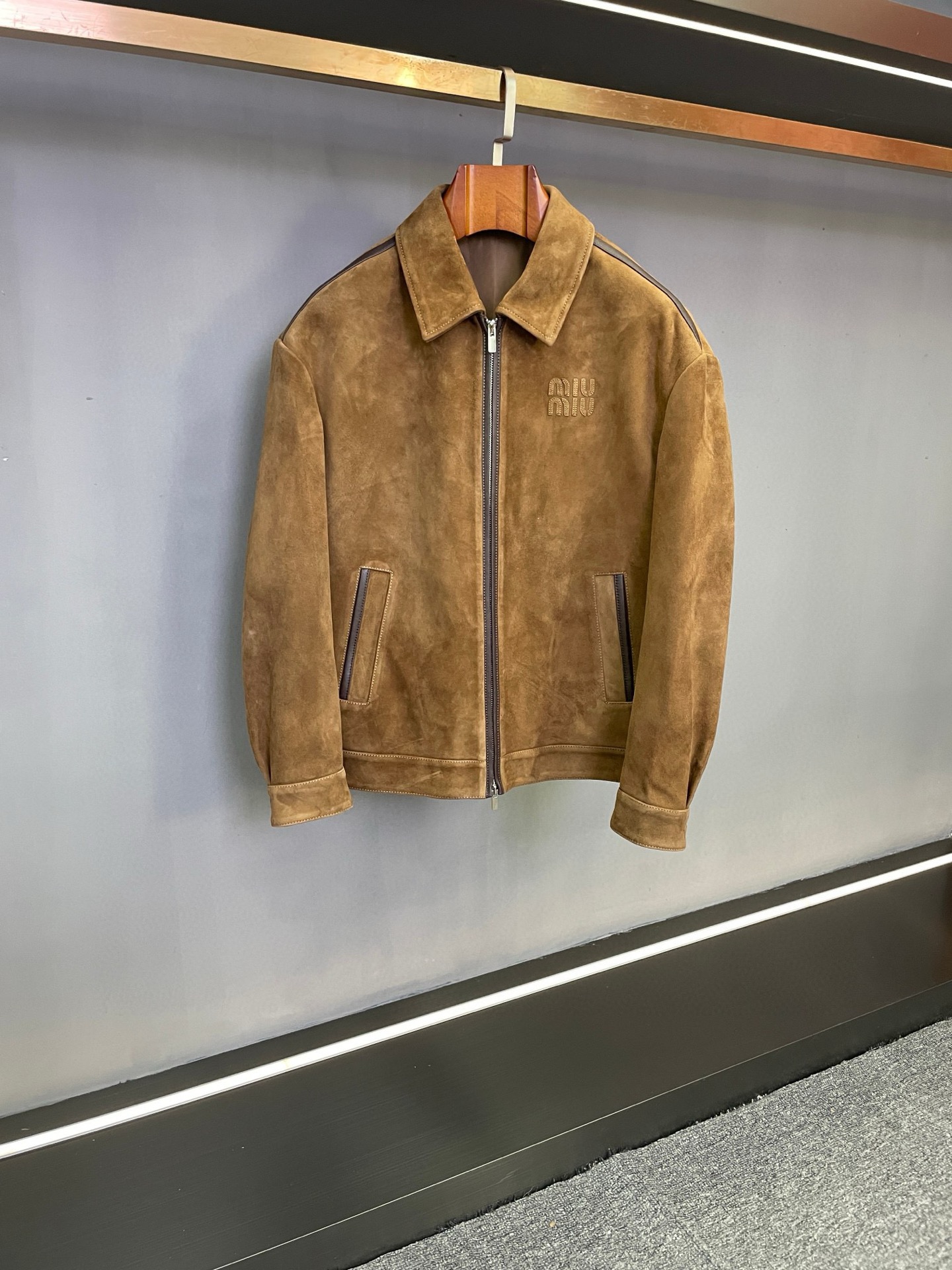 NO:854843,MIU MIU Miu Miu's new autumn and winter men's sheepskin jacket is shockingly launched, opening a new chapter in autumn and winter dressing, interpreting men's elegance and personality with extraordinary design and top-quality materials.  The jacket is made of brown sheepskin imported from New Zealand, which has been treated with fine suede, giving it an unparalleled soft touch, as if it is in gentle dialogue with the skin, and every touch is full of comfort. Not only that, the suede texture also gives the jacket a unique visual texture, showing a low-key and luxurious high-end charm, which flows naturally under the light, showing quality and style.  The iconic MIUMIU embroidery on the chest is a symbol of the brand's identity. It uses exquisite craftsmanship to outline the brand's soul. Miu Miu's ingenuity is hidden in every stitch and line, highlighting the wearer's fashion taste and extraordinary style.  The shoulder line, placket and pockets are edged with orange sheepskin. The bold contrasting color design injects fresh vitality into the entire jacket, finding a delicate balance between calmness and liveliness. The details are full of ingenuity. Whether it is a business negotiation or a casual gathering, it can make you the center of attention and easily manage various occasions.  For matching, you can wear a simple white shirt, black trousers as bottoms, and a pair of exquisite leather shoes to show your gentlemanly demeanor and are suitable for formal business activities. Put on a dark turtleneck sweater and dark blue jeans, and pair it with a pair of casual sneakers to instantly transform into a casual and trendy man, suitable for weekend outings or gatherings with friends. Miu miu's new autumn and winter men's sheepskin jacket is the perfect fusion of fashion and quality. We look forward to you experiencing this unique charm.  Size M-4XL.,,miumiu,jeans,jackets & coats,sweaters,shirts,sheepskin,Top Customize119860909MIU MIU缪缪秋冬新款男士羊皮夹克震撼上市,开启秋冬穿搭新篇,以非凡设计与顶级材质,诠释男士的优雅与个性.  夹克精选新西兰进口棕色羊皮,经过细腻的反绒处理,带来无与伦比的柔软触感,仿佛与肌肤温柔对话,每一次触碰都满是惬意.不仅如此,反绒质地还赋予了夹克独特的视觉质感,呈现出低调奢华的高级韵味,在光线下自然流转,尽显品质与格调.  胸前标志性的MIUMIU刺绣,是品牌身份的象征,以精致工艺勾勒品牌灵魂,一针一线皆藏着缪缪的匠心独运,彰显穿着者的时尚品味与不凡格调.  肩线、门襟以及口袋处,采用橙色羊皮包边,大胆的撞色设计为整件夹克注入了鲜活的生命力,在沉稳与活泼间寻得精妙平衡,细节之处尽显巧思,无论是商务洽谈还是休闲聚会,都能让你成为众人焦点,轻松驾驭各种场合.  搭配上,可内搭简约白衬衫,下装选择黑色西裤,脚蹬一双精致皮鞋,尽显绅士风度,适合正式商务活动；换上深色高领毛衣与深蓝色牛仔裤,再搭配一双休闲板鞋,立刻变身休闲潮男,适配周末出游或朋友聚会.  Miu miu 秋冬新款男士羊皮夹克,是时尚与品质的完美融合,期待您亲身感受这份独特魅力 . 码数M-4XL.,,miumiu,jeans,jackets & coats,sweaters,shirts,sheepskin,Top Customize1,Men's clothing