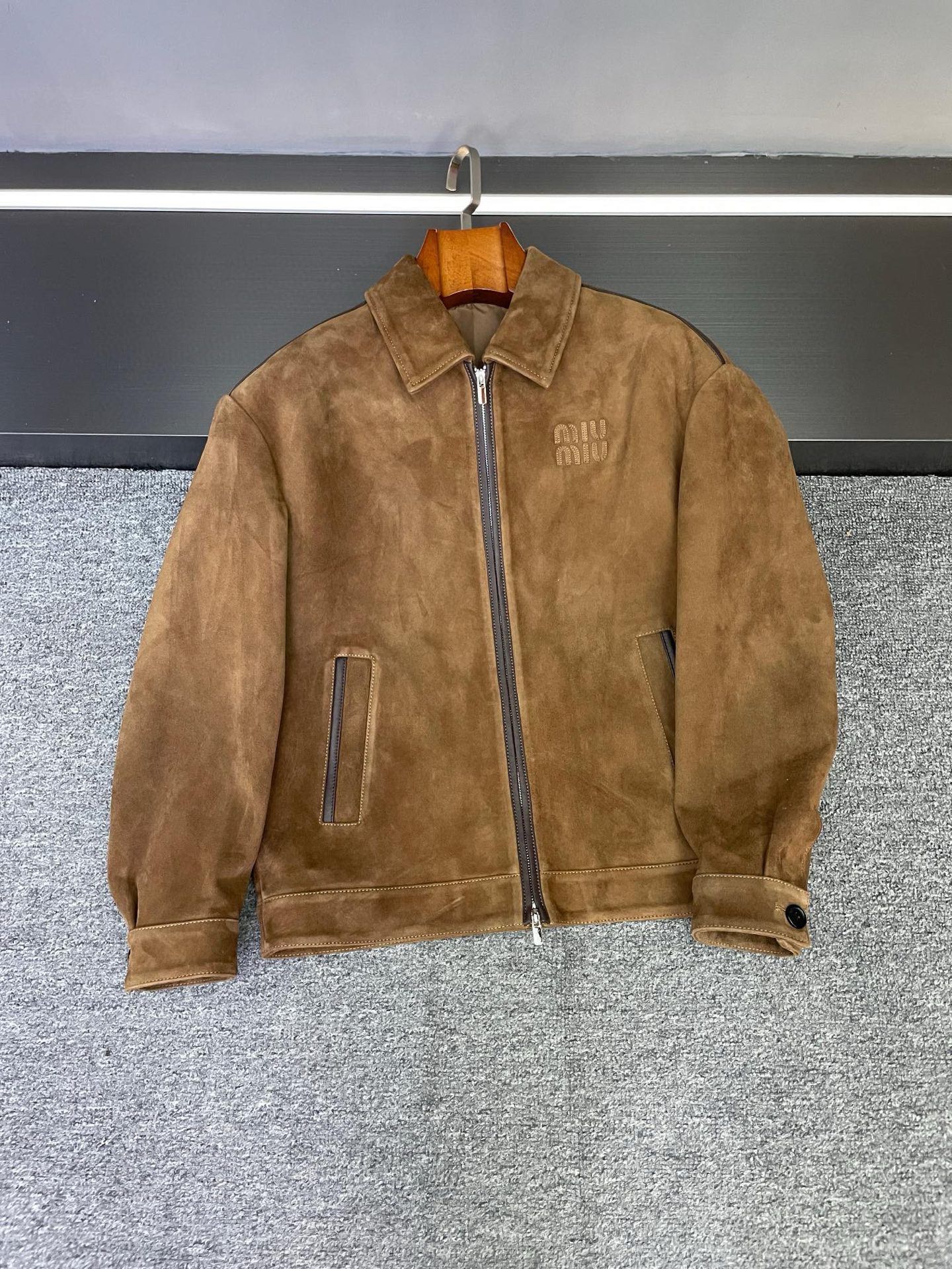 NO:854850,MIU MIU Miu Miu's new men's sheepskin jacket for autumn and winter is shockingly launched, opening a new chapter in autumn and winter dressing. It interprets men's elegance and personality with extraordinary design and top-quality materials. Miu Miu Sheepskin Jacket  Selected brown sheepskin imported from New Zealand has been treated with fine suede, bringing an unparalleled soft touch, as if it is in gentle dialogue with the skin, and every touch is full of comfort. Not only that, the suede texture also gives the jacket a unique visual texture, showing a low-key and luxurious high-end charm, which flows naturally under the light, showing quality and style.  The iconic MIUMIU embroidery on the chest is a symbol of the brand's identity. It uses exquisite craftsmanship to outline the brand's soul. Miu Miu's ingenuity is hidden in every stitch and line, highlighting the wearer's fashion taste and extraordinary style.  The shoulder line, placket and pockets are edged with orange sheepskin. The bold contrasting color design injects fresh vitality into the entire jacket, finding a delicate balance between calmness and liveliness. The details are full of ingenuity. Whether it is a business negotiation or a casual gathering, it can make you the center of attention and easily manage various occasions.  For matching, you can wear a simple white shirt, black trousers as bottoms, and a pair of exquisite leather shoes to show your gentlemanly demeanor, suitable for formal business activities; put on a dark turtleneck sweater, dark blue jeans, and a pair of casual sneakers to instantly transform into a casual and trendy man, suitable for weekend outings or gatherings with friends. Miu Miu's new autumn and winter men's sheepskin jacket is the perfect fusion of fashion and quality. We look forward to you experiencing this unique charm.  Size 48-56,,miumiu,jeans,jackets & coats,jackets & coats,sweaters,shirts,sheepskin,Top Customize119860909MIU MIU 缪缪秋冬新款男士羊皮夹克震撼上市,开启秋冬穿搭新篇,以非凡设计与顶级材质,诠释男士的优雅与个性.  Miu Miu 羊皮外套 精选新西兰进口棕色羊皮,经过细腻的反绒处理,带来无与伦比的柔软触感,仿佛与肌肤温柔对话,每一次触碰都满是惬意.不仅如此,反绒质地还赋予了夹克独特的视觉质感,呈现出低调奢华的高级韵味,在光线下自然流转,尽显品质与格调.  胸前标志性的MIUMIU刺绣,是品牌身份的象征,以精致工艺勾勒品牌灵魂,一针一线皆藏着缪缪的匠心独运,彰显穿着者的时尚品味与不凡格调.  肩线、门襟以及口袋处,采用橙色羊皮包边,大胆的撞色设计为整件夹克注入了鲜活的生命力,在沉稳与活泼间寻得精妙平衡,细节之处尽显巧思,无论是商务洽谈还是休闲聚会,都能让你成为众人焦点,轻松驾驭各种场合.  搭配上,可内搭简约白衬衫,下装选择黑色西裤,脚蹬一双精致皮鞋,尽显绅士风度,适合正式商务活动；换上深色高领毛衣与深蓝色牛仔裤,再搭配一双休闲板鞋,立刻变身休闲潮男,适配周末出游或朋友聚会.  Miu Miu 秋冬新款男士羊皮夹克,是时尚与品质的完美融合,期待您亲身感受这份独特魅力 . 码数48-56,,miumiu,jeans,jackets & coats,jackets & coats,sweaters,shirts,sheepskin,Top Customize1,Men's clothing
