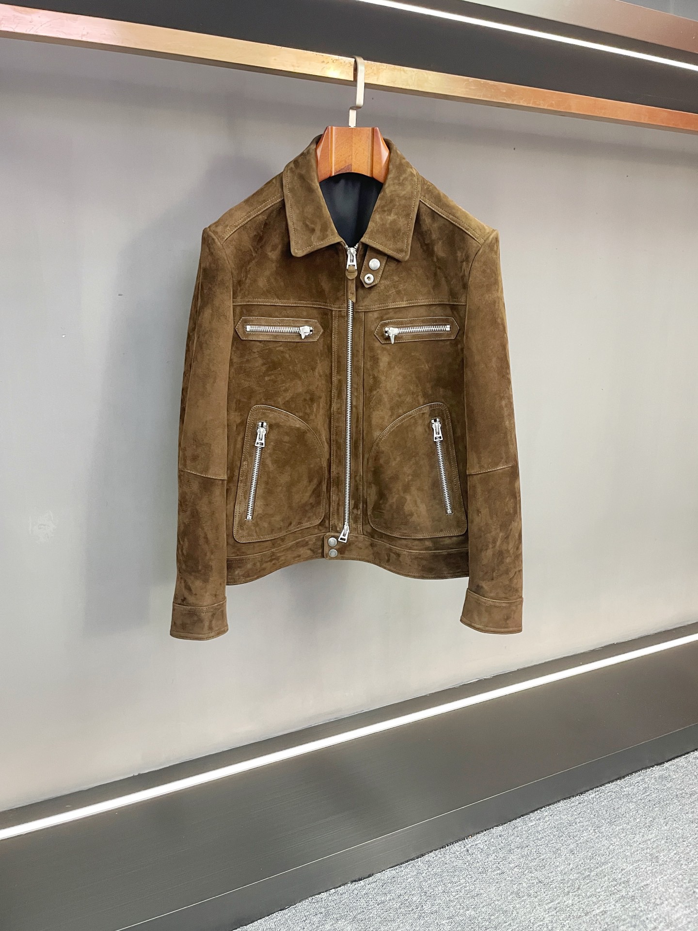 NO:772597,TOM FORD's 2026 spring and summer men's brown suede sheepskin jacket is a hard-core expression of texture and edge. In the style narrative of the 2026 spring and summer, TOM FORD uses classic American men's wear aesthetics as the basis to launch men's brown suede sheepskin jacket, which accurately integrates tough guy style and luxurious texture, becoming an irreplaceable style item in the season.  Material is the core footnote of quality. The jacket is made of suede sheepskin imported from New Zealand. It has a fine and rich suede surface, a warm and soft touch, and a natural brown luster as the light and shadow flow. Every inch of the texture demonstrates the precious texture and durability of natural leather. As the brand's iconic craft heritage, the leather has been finely processed, retaining the softness of sheepskin and being close to the skin, while also having a stiff texture that is strong enough to withstand the coldness of autumn and winter, achieving a balance between comfort and functionality.  The design interprets the tough guy style with 'hard practicality'. The four zipper pockets on the front are arranged at random, which not only strengthens the visual tension of workwear aesthetics, but also makes the storage of daily belongings organized. The placket is equipped with a double puller design, which can freely adjust the opening and closing height. It is equipped with a customized windproof buckle device, which can tightly lock the collar when the cold wind hits. It has both styling layer and thermal insulation performance, and practical ingenuity can be seen in the details. As a TF  A continuation of modern retro aesthetics, this jacket is perfectly suitable for a variety of scenarios - paired with a simple white T-shirt and denim trousers, it is a casual street style; paired with an Oxford shirt and casual trousers, it can switch to a calm business casual style. With the luxurious texture of New Zealand sheepskin as its bone and hard-core details as its soul, it has become an ideal choice for contemporary men to express their firm aura and exquisite taste. Size M-3XL,, tom ford, tom ford, jackets &  coats,shirts,sheepskin,Top Customize119860909汤姆福特 TOM FORD 2026春夏男士棕色反绒羊皮夹克质感与锋芒的硬核表达 在2026春夏的风格叙事中,TOM FORD以经典美式男装美学为基底,推出男士棕色反绒羊皮夹克,将硬汉格调与奢华质感精准融合,成为季节里不可替代的格调单品. 材质是品质的核心注脚.夹克甄选新西兰进口反绒羊皮打造,绒面细腻丰盈,触感温润软糯,随光影流转呈现自然的棕调光泽,每一寸肌理都彰显着天然皮革的珍贵质感与耐用属性.作为品牌标志性的工艺传承,皮革经精细处理,既保留了羊皮的柔软亲肤,又兼具足以抵御秋冬寒意的挺括质感,实现舒适与机能的平衡. 设计上以“硬核实用”诠释硬汉风格.前幅四个拉链口袋错落排布,不仅强化了工装美学的视觉张力,更让日常随身物件的收纳井井有条.门襟搭载双拉头设计,可自由调节开合高度,搭配定制防风扣装置,寒风侵袭时能紧密锁合领口,兼具造型层次与保暖性能,于细节处见实用巧思. 作为TF 现代复古美学的延续,这款夹克完美适配多元场景——内搭简约白T与牛仔长裤,是街头的率性型格；搭配牛津纺衬衫与休闲西裤,则能切换为商务休闲的沉稳格调.它以新西兰羊皮的奢贵质感为骨,以硬核细节为魂,成为当代男士表达坚定气场与精致品味的理想之选. 码数M-3XL,,tom ford,tom ford,jackets & coats,shirts,sheepskin,Top Customize1,Men's clothing